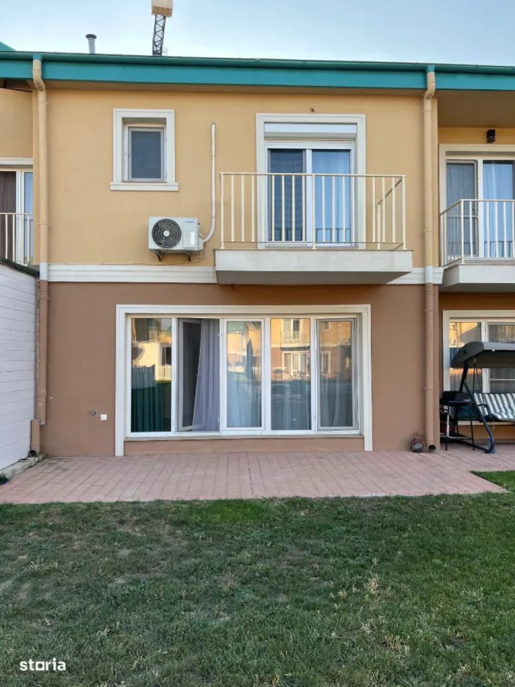 Proprietar inchiriez Cosmopolis Vila N semi-mobilat - Ofer spre închiriere pe termen lung, vila P+1+M, situată in zona noua a complexului Cosmopolis, aproape de intrarea dinspre tunari, este la a doua închiriere, are 2 locuri de parcare pozitionate chiar la intrarea in casa. La parter se afla bucătăria mobilată și cu toate electrocasnicele incluse, livingul generos cu vedere la curtea interioara cu piscina, un hol la intrare și o toaleta de serviciu. La etaj avem un dormitor matrimonial cu hol, dressing, baie cu cada, mașina de spălat, și un alt dormitor cu baia pe hol. Podul este mansardabil sau se poate folosi ca spațiu generos de depozitare. Încălzirea este in pardoseala, avem vecini stânga/dreapta. Suprafata utila este de 95mp, curtea interioara este așa cum se poate observa in poze, cu piscina, iar grădina proprie este de 35mp, îngrădită. Detalii suplimentare la nr de telefon