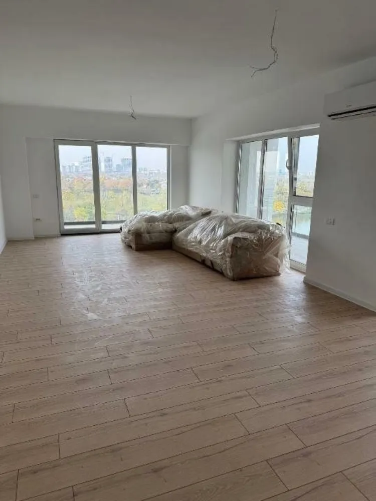 Pers fizică - Apartament de vis cu 3 camere şi vedere superba spre lac! - Descoperă un loc pe care sa-l numeşti acasă! Oferim spre vanzare apartament luminos şi spaţios, cu 3 camere, situat într-o zonă liniştită, cu vedere deosebită către lac. -Vedere panoramică: ferestrele de la living şi dormitoare oferă o privelişte impresionantă asupra lacului şi oraşului, perfectă pentru relaxare în orice moment al zilei. -Spatiu generos: apartamentul dispune de o suprafaţă utilă totală de 103,35 mp, repartizat astfel: 81,91 mp living, bai şi dormitoare şi 21,44 mp dispuşi în 2 balcoane superbe, individuale ce înconjoară livingul. -Bloc nou, dat în folosinţă în luna Noiembrie 2024. -Parcare subterană cu 2 niveluri (sunt rezervate, nefiind incluse în preţ, 2 locuri de parcare alipite la -1 în suprafaţă totală de 32,73 mp la intrarea în bloc, lângă lifturi). -Curtea interioară oferă o grădină botanică fiind investiţi peste 50.000 â‚Ź în copaci, flori şi plante cu sistem propriu de irigaţie. -Blocul este amplasat la: 1 minut de mers pe jos de McDonaldâ€™s, Mega Image, Lidl, mijloace de transport in comun, la 5 metri de intrarea in parcul de pe malul lacului, 170 m şcoala, sub 1 km de autostrada Bucureşti-Ploieşti, 500 m de Şoseaua Fundeni, sub 1 km de Petricani şi Fabrica de Glucoză. -Apartamentul se vinde nemobilat astfel încât viitorul proprietar să-l poată amenaja după propriile preferinţe. -Propretatea se află la etajul 8/10. -Locuinţă dispune de încălzire în pardoseală cu termostat wireless, tâmplărie Salamander, aer condiţionat, 2 băi (una cu cada, una cu rigola), izolaţie cu vată de sticlă, încălzire centralizată. Daca eşti în căutarea unui apartament modern, cu un peisaj unic, aproape de facilităţi esenţiale (şcoli, supermarketuri, mijloace de transport, autostrada, şosea de centură) acest apartament este alegerea perfectă. Pentru mai multe detalii şi programarea unei vizionări nu ezita să ne contactezi la nr. de telefon: .