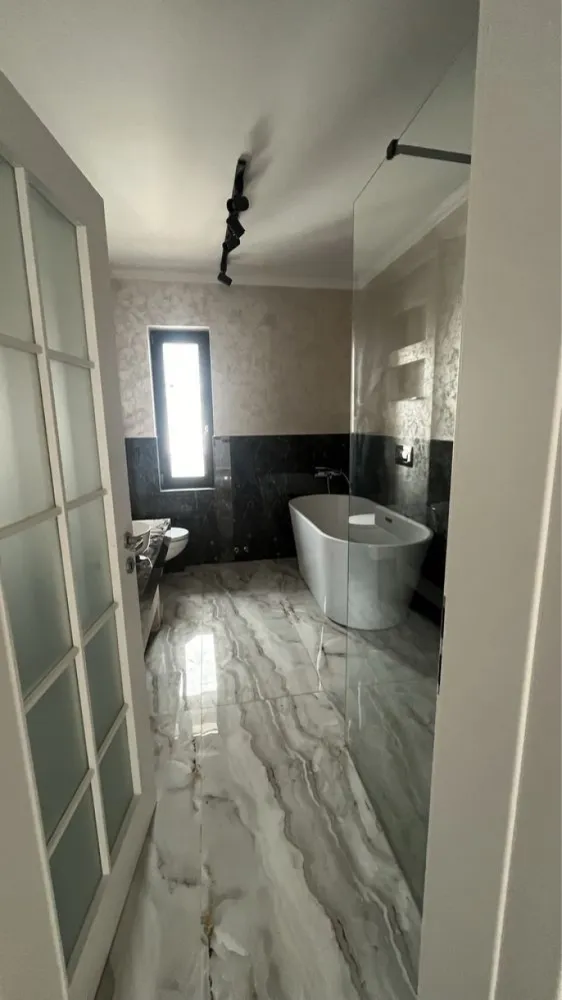 Casa Bucium Noua Direct Dezvoltator - Direct Dezvoltator Aceast ansamblu de case este situat in zona rezidențiala Bucium la 1 km de supermarket LIDL și benzinaria Mol, intr-o locatie foarte liniștita și cu vedere deosebita asupra orașului Iasi.. Este formată din parter și etaj cu o suprafața 112 mp utili și teren 400 mp+77 mp cota indiviză Caile de acces intre proprietati beneficiaza de drumuri asfaltate, alei si trotuare amenajate cu pavele. Casele sunt concepute pentru confortul și necesităților unei familii. Structural sunt coonfigurata din living spațios , 3 dormitoare , bucătărie , dresing , 2 bai , terasa , Magazie. Finisaje exterioare: Tencuiala decorativa Geam termopan de cea mai buna calitate Polistiren 10 cm EPS 100 Grafitat Caramida Porotherm Hidorizolatie acoperis - placa beton armat, hidroizolatie, polistiren Trotuar pavaj in fata casei Platforma pavaj pentru parcare masina Garduri din Boltari și metalice pentru delimitarea curtii Finisaje interioare Tencuiala - Glet Sapa pe baza de ipsos Gresie si faianta pentru bai si bucatarie - modele la alegerea clientului din oferta furnizorilor Panoramic Residence ; Bai echipate (obiecte sanitare: Wc-uri si lavoare portelan, bideu, cada baie, cabina dus) Centrala termica Calorifere otel si incalzire prin pardoseala; Intrerupatoare si prize Usi interioare Pardoseli din parchet laminat montat pe folie PEE 3 mm in dormitoare, hol etaj si living(culori modele - la alegerea clientului); Zugraveli cu vopsea lavabila alba; Scara interioara zidita, placata cu lemn, cu balustrada si mana curenta din lemn MOBILATA Utilitati Apa din reteaua publica Iasi (Apavital) Canalizare retea publica Iasi (Apavital) Gaze (EON) Energie electrica Prețul este de 169900TVA inclus Pentru mai multe detalii ne puteți contacta 07******18 Vezi mai puţin
