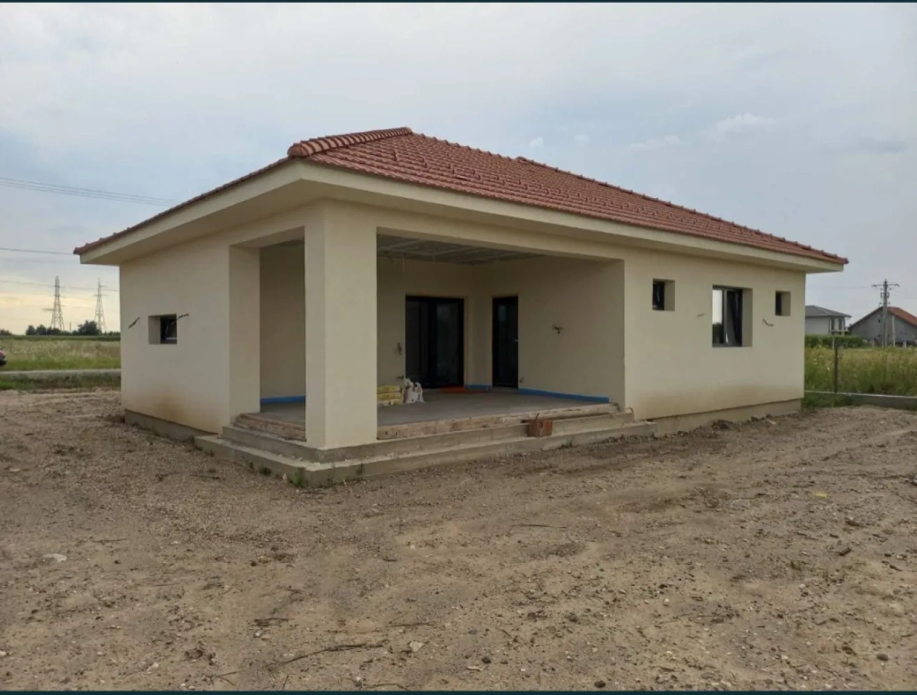 Vand casa Paulesti - Locatie: loc. Paulesti, str. Andrei Muresanu, nr. 12, jud. Satu Mare (proprietate usor accesibila de la strada Principala, fie prin str. Ghioceilor/str. Randunelelor/str. Nicolae Balcescu). Suprafata teren = 600mp (22.10m x 27.15m) Suprafata construita la sol (amprenta) = 175mp Suprafata utila = 142mp Compartimentare: intrare acoperita, vestibul, living, dining, bucatarie, hol, doua bai, trei dormitoare (din care unul matrimonial, cu dressing si baie proprie), spalatorie, camera tehnica si terasa acoperita. Detalii constructive: - Izolatie - Termosistem la fatada este realizata cu vata minerala bazaltica pentru fatada, in grosime de 20cm Rockwool Frontrock Casa (grosime maxima ce se gaseste de vanzare si probabil cea mai buna calitate); - Tamplarie PVC Salamander 92mm (probabil, cea mai performanta la ora actuala) cu 6 camere de izolare si geam termoizolant triplu. Aceasta a fost achizitionata si montata cu cei de la ASO din Baia Mare. Pentru ferestre se poate analiza in detaliu fereastra-aso.ro/exclusiv/, iar pentru usa din terasa fereastra-aso.ro/usi-culisante-cu-ridicare/. - Planseu din beton armat - La acoperis este montata astereala din scandura pe toata suprafata, iar peste aceasta este montata folie anticondens, sipci, contrasipci si invelitoare din tigla ceramica Tondach. - Inaltimea libera intre pardosela si tavan = 2.85m STANDARDUL nZEB Foarte important: casa este proiectata sa se incadreze in Standardul nZEB (Nearly Zero Energy Building), varianta V3 - consum de energie anual mai mic, cel mult egal cu 110 kwh/mp/an – energie primara bruta. STADIU LA PREDARE: La exterior: finalizat. La interior: peretii si tavanul gata pregatiti a fi dati cu lavabila (au fost aplicate tencuiala manuala, si doua staraturi de glet), instalatii sanitare si electrice finalizate, incalzirea in pardoseala finalizata si sapa turnata peste izolatiea la placa pardosela din polistiren de 10cm grosime gata pregatita pentru montaj pardoseli. Curtea nivelata si imprejmuita pe trei laturi. Vor fi puse la dispozitie utilitatile apa, canal - fosa septica si electricitate. Strada Andrei Muresanu este recent asfaltata. Toate lucrarile au fost executate doar cu personal calificat (maistru in constructii), urmarite de inginer constructor si supervizate de diriginte de santier atestat. In momentul vanzarii se va preda cartea tehnica a constructiei cu totalitatea istoricului constructiei, procese verbale de lucrari ascunse, condica de betoane, certificate de conformitate si calitate a tuturor materialelor puse in opera si imagini reale din timpul executiei lucrarilor.