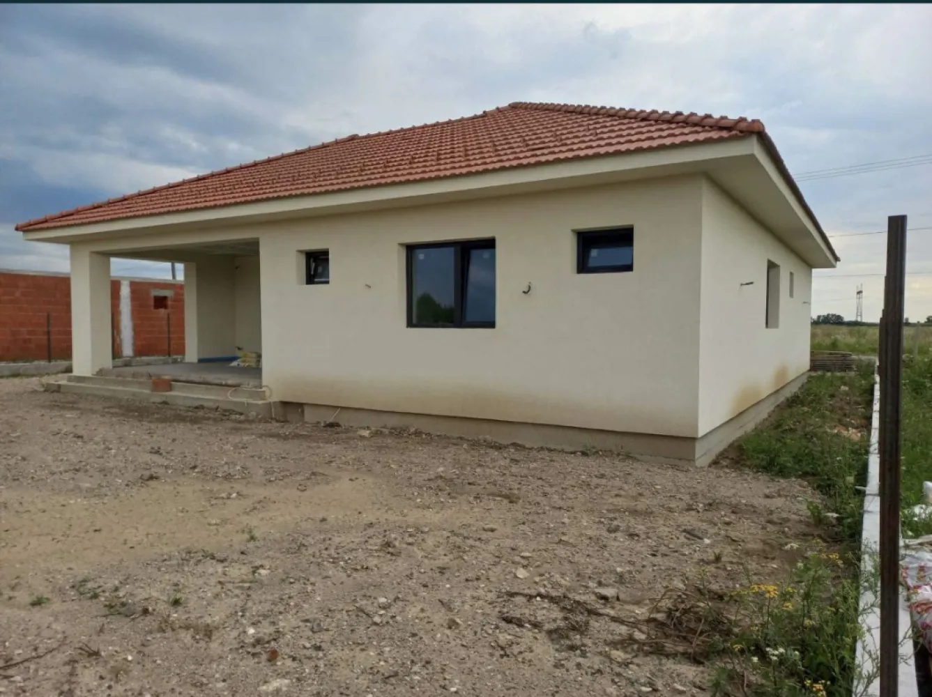 Vand casa Paulesti - Locatie: loc. Paulesti, str. Andrei Muresanu, nr. 12, jud. Satu Mare (proprietate usor accesibila de la strada Principala, fie prin str. Ghioceilor/str. Randunelelor/str. Nicolae Balcescu). Suprafata teren = 600mp (22.10m x 27.15m) Suprafata construita la sol (amprenta) = 175mp Suprafata utila = 142mp Compartimentare: intrare acoperita, vestibul, living, dining, bucatarie, hol, doua bai, trei dormitoare (din care unul matrimonial, cu dressing si baie proprie), spalatorie, camera tehnica si terasa acoperita. Detalii constructive: - Izolatie - Termosistem la fatada este realizata cu vata minerala bazaltica pentru fatada, in grosime de 20cm Rockwool Frontrock Casa (grosime maxima ce se gaseste de vanzare si probabil cea mai buna calitate); - Tamplarie PVC Salamander 92mm (probabil, cea mai performanta la ora actuala) cu 6 camere de izolare si geam termoizolant triplu. Aceasta a fost achizitionata si montata cu cei de la ASO din Baia Mare. Pentru ferestre se poate analiza in detaliu fereastra-aso.ro/exclusiv/, iar pentru usa din terasa fereastra-aso.ro/usi-culisante-cu-ridicare/. - Planseu din beton armat - La acoperis este montata astereala din scandura pe toata suprafata, iar peste aceasta este montata folie anticondens, sipci, contrasipci si invelitoare din tigla ceramica Tondach. - Inaltimea libera intre pardosela si tavan = 2.85m STANDARDUL nZEB Foarte important: casa este proiectata sa se incadreze in Standardul nZEB (Nearly Zero Energy Building), varianta V3 - consum de energie anual mai mic, cel mult egal cu 110 kwh/mp/an – energie primara bruta. STADIU LA PREDARE: La exterior: finalizat. La interior: peretii si tavanul gata pregatiti a fi dati cu lavabila (au fost aplicate tencuiala manuala, si doua staraturi de glet), instalatii sanitare si electrice finalizate, incalzirea in pardoseala finalizata si sapa turnata peste izolatiea la placa pardosela din polistiren de 10cm grosime gata pregatita pentru montaj pardoseli. Curtea nivelata si imprejmuita pe trei laturi. Vor fi puse la dispozitie utilitatile apa, canal - fosa septica si electricitate. Strada Andrei Muresanu este recent asfaltata. Toate lucrarile au fost executate doar cu personal calificat (maistru in constructii), urmarite de inginer constructor si supervizate de diriginte de santier atestat. In momentul vanzarii se va preda cartea tehnica a constructiei cu totalitatea istoricului constructiei, procese verbale de lucrari ascunse, condica de betoane, certificate de conformitate si calitate a tuturor materialelor puse in opera si imagini reale din timpul executiei lucrarilor.