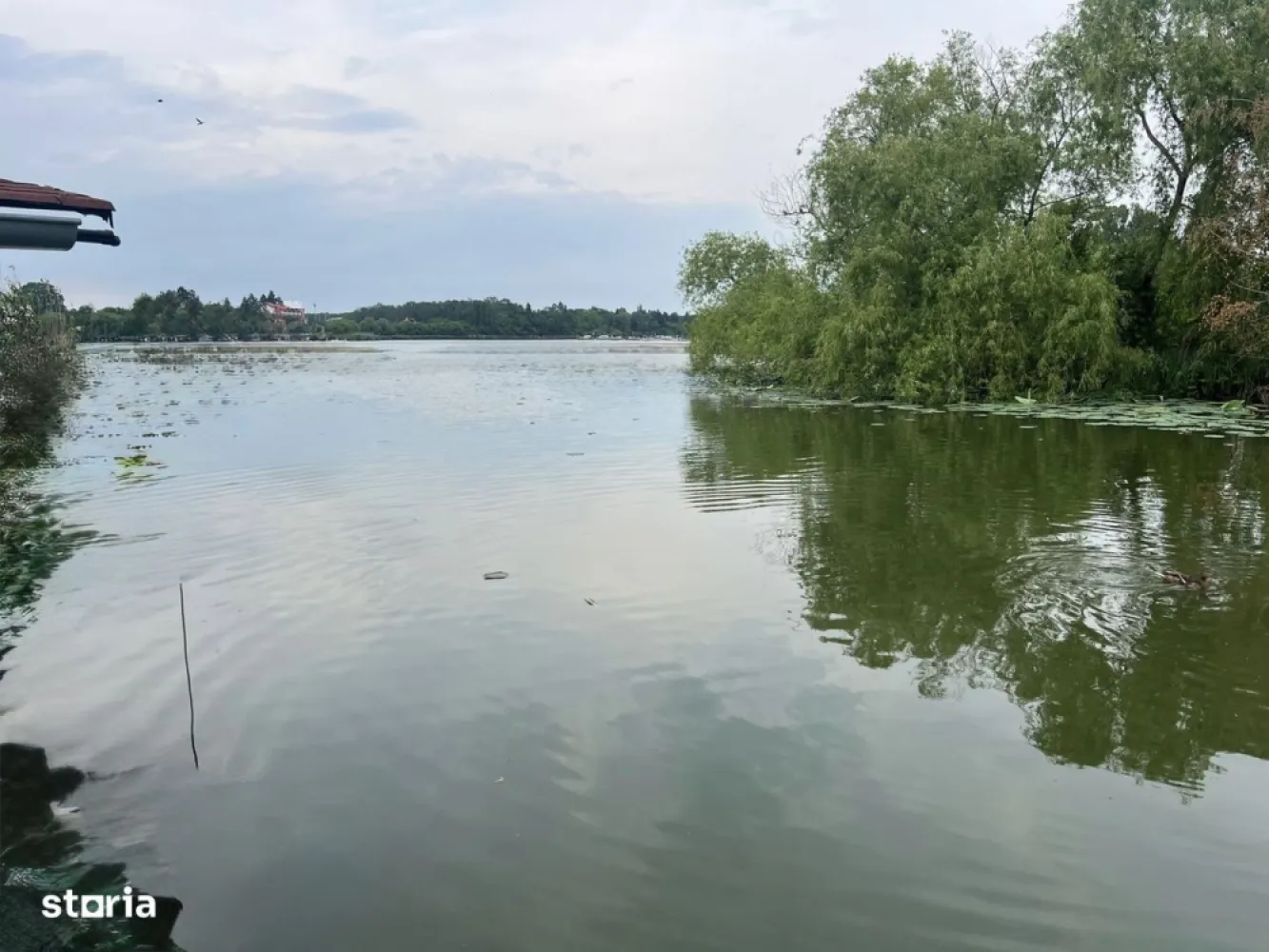 ofer spre vanzare teren pe malul lacului Snagov si vila S+P+E+M - Imobil excelent cu potențial de Dezvoltare Turistică și Rezidențială situat in satul Ghermanesti, cu o deschidere de 37 ml la str. Razboieni (asfaltata) si o deschidere generoasa de 31 ml la mijlocul lacul Snagov ce beneficiază de toate utilitatile (electricitate, apă, gaz și fose septica) .Imobilul este format din teren intravilan in suprafata de 7610 mp , doua constructii: o constructie edificata in anul 1990 si renovata in 2022 din caramida si plansee de beton si acoperita cu tabla Lindab, cu o suprafata desfasurata de 300 mp, avand regim de inaltime S+P+E+M si o constructie veche din 1910 avand regim de inaltime P+M si o suprafata desfasurata de 120 mp (ce poate fi renovata / extinsa rapid) , ponton existent si garaj pentru barcă.Fiind amplasat intr-o zonă recunoscută pentru caracterul sau exclusivist, foarte linistita situata langa Padurea Vladiceasca, cu acces direct la Lacul Snagov si avand o vegetatie bogata si numerosi pomi fructiferi ce ofera intimitate si aer curat, imobilul este o oaza de relaxare fiind ideal pentru uz rezidential de lux.Avantajele si potentialul investitional al imobilului: -Oportunitate deosebită pentru dezvoltări imobiliare mixte cu potențial rezidențial de lux sau destinație turistică premium. avand in vedere caracterul parcelabil al terenului (pana la 10 parcele + drum)-Potențial Rezidențial terenul fiind ideal pentru dezvoltarea unui ansamblu de vile de lux, unele cu vedere la lac, terase, spații verzi private și facilități nautice.-Potențialul investițional este ridicat in contextul cererii în creștere pentru locuințe de vacanță sau reședințe permanente în zone retrase, dar apropiate de București si avand in vedere numarul limitat al imobilelor aflate pe malul lacului Snagov .-Potențial dezvoltare imobiliară Turistic avand in vedere ca lacul Snagov este deja o destinație cu notorietate pentru agrement nautic, pescuit, sporturi pe apă și relaxare. Terenul permite extinderea pontoanelor și construirea unor unități turistice tip bungalow, case plutitoare sau ecovile. Un mini-resort cu ponton privat, spa, restaurant cu vedere panoramică și acces direct la apă este fezabil.-Potențial de valorificare ridicat în regim de închiriere (rezidențial de lux sau turistic) avand in vedere cererea ridicată pentru terenuri cu deschidere la lac și infrastructură existentă. Avantajele amplasarii:- in imediata apropiere a stației de autobuz "Stadionului",-la cativa pasi de Stadionul FC Snagov, -foarte aproape de supermarketul Peny si alte cateva magazine alimentare, -la 2 statii de autobuz de Primaria Snagov.-la 7 km (5 minute de mers cu masina) de autostrada A3 Bucuresti - Ploiesti de unde se poate ajunge facil atat in capitala cat si in Ploiesti.-acces rapid scoala, gradinita si dispensare, -acces usor la DN1.-langa padure-pe malul lacului
