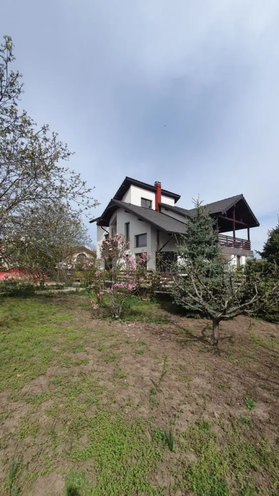 Vila 412 mp Galata, 1201 mp curte, direct proprietar - Vilă de vânzare în zona Galata în zona rezidențială, aproape de pădure. Terenul are o suprafață de 1201 mp și este amplasat la intersecție, având acces auto din două străzi, fiind dotat cu toate utilitățile. Vila D+P+E+M are 7 camere, 4 băi, 3 holuri și 2 bucătării, 1 balcon, 2 terase, 1 garaj. Anul punerii în funcțiune este 2019. Repartizarea camerelor: DEMISOL: 2 camere, baie, hol, spațiu depozitare, beci, bucatarie nemobilata, acces direct din curte și acces din holul casei PARTER: hol, living pe 2 nivele cu șemineu, bucătărie mobilata, loc de luat masa, dormitor, baie, terasă ETAJ: dressing, baie, 2 dormitoare, hol gol peste living,1 balcon, o terasa si acces interior/exterior spre mansardă MANSARDĂ: hol, 1 dormitor, baie, spațiu de depozitare Casa are amprenta la sol de 125 mp și o suprafață totală desfășurată de 412 mp si 293 mp utili. Construcția este solidă, cu structură din beton și zidărie de cărămidă, având pereții exteriori termoizolați cu polistiren de 10 cm, șarpantă din lemn izolata, învelitoare din țiglă, finisaje superioare: încălzire în pardoseală și gresie care imită parchetul la parter și nivelele superioare, parchet la demisol, tâmplărie PVC cu geam termopan la exterior și lemn masiv la interior, faianță și gresie în băi, 2 centrale termice proprii, instalații sanitare și de încălzire dotate cu distribuitoare pe fiecare nivel și cu termostate în fiecare cameră. Pe teren sunt amplasați pomi fructiferi, brazi, o grădină cu flori și sunt amenajate 2 accese auto și 3 accese pietonale și pavaje din beton. Împrejmuirea este realizată din stâlpi de beton cu panouri de fier, având două porți metalice de acces spre străzile la care are front stradal.