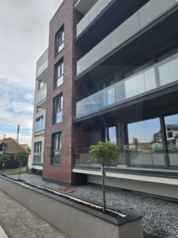 Apartament premium 75 mp utili cu parcare subterana si boxa Central - Agenția imobiliară Azura‑Estate vă propune spre achiziție un apartament superior, complet decomandat, luminos și finisat la standarde înalte, construcție nouă din 2025, izolat exterior cu vată bazaltică și amplasat într-o zonă premium, apreciată pentru accesibilitate, confort și calitatea dezvoltărilor rezidențiale. Locuința dispune de 74.7 mp utili și este configurată ideal pentru un stil de viață modern: living generos cu bucătărie integrată, două dormitoare bine proporționate, două băi, un balcon cu o suprafata de 11 mp utili, parcare subterană și boxă, elemente care completează perfect confortul urban. Apartamentul se remarcă prin compartimentare eficientă, lumină naturală abundentă și finisaje atent alese, oferind un ambient premium. Proiectul este unul dintre cele mai exclusiviste ansambluri rezidențiale ale zonei care impresionează prin arhitectura sa contemporană cu linii curate, fațade elegante îmbinate cu accente de cărămidă și sticlă, balcoane ample cu parapet transparent și o estetică urbană perfect proporționată. Cartierul este bine conectat, cu străzi curate, acces rapid către artere principale, malul Cibinului, centrul orasului, centre comerciale, universitati, școli, gradinite și zone verzi, ceea ce il transforma într-o alegere de top pentru cei care caută nu doar un apartament ci un stil de viață orientat spre calitate. Compartimentare & dotări Living spațios, luminos cu bucatarie open space Două dormitoare aerisite, cu spații generoase de depozitare Două băi moderne – una cu cadă, una cu duș Boxă / spațiu de depozitare la subsol Balcon cu suprafata de 11 mp utili Parcare subterană privata Încălzire în pardoseală, aer condiționat, WiFi, Stradă privată, zonă de case, foarte liniștită Transport public la câțiva pași Priveliște superbă către centrul istoric și către munți Fotografiile sunt cu titlu de prezentare si au fost realizate in apartamente deja vandute! Pretul de vanzare la cheie este de 235000 euro cu TVA 21% inclus!