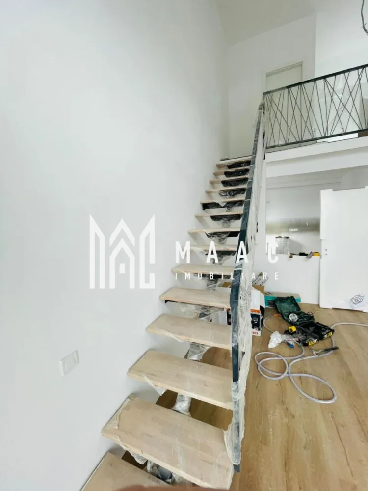 Penthouse 4 Camere I 2 Niveluri I Predare la CHEIE I 103 mp - MAAC Imobiliare vă propune spre vânzare un penthouse modern cu 4 camere, dispus pe două niveluri, situat în Cartierul DaVinci – zona Turnișor, Sibiu, într-un ansamblu rezidențial nou, aerisit, cu spații verzi generoase și acces rapid către oraș.

Această proprietate este ideală pentru cei care caută un apartament de vânzare în Sibiu, în Cartierul DaVinci, spațios, luminos și bine compartimentat, potrivit atât pentru locuință permanentă, cât și pentru investiție imobiliară.

Date tehnice:

Suprafață utilă: 103,55 mp
Logie închisă cu sticlă securizată: 8 mp
Etaj: 2 din 2 (ultimul etaj)
Predare: la cheie
Intabulare la finalizare
Loc de parcare inclus
Preț: 151.000 EUR

Compartimentare:
Living cu înălțime impresionantă de 5,6 m
3 dormitoare spațioase
Bucătărie închisă
2 băi complet finisate
Logie de 8 mp utili, închisă, cu sistem de captare a apelor
Orientare sudică, cu lumină naturală pe tot parcursul zilei
Vedere panoramică spre munți

Dotări și finisaje:
Încălzire în pardoseală pe ambele niveluri
Jaluzele electrice
Izolație cu vată bazaltică pentru eficiență energetică ridicată
Granit pe casa scării
Fațade placate cu larice siberian și piatră naturală
Finisaje de calitate superioară

Facilități ansamblu rezidențial Cartierul DaVinci – Sibiu:
45% din suprafață amenajată ca spații verzi
Locuri de joacă pentru copii
Patru căi de acces către complex
Acces facil către oraș, fără blocaje

Cartierul DaVinci din zona Turnișor este una dintre cele mai apreciate zone rezidențiale noi din Sibiu, datorită arhitecturii moderne, distanței mari dintre clădiri și procentului ridicat de spații verzi.

Acest penthouse de vânzare în Sibiu, Cartierul DaVinci, oferă un echilibru excelent între spațiu, confort și calitatea construcției, fiind ideal pentru familii care își doresc o locuință modernă într-un cadru aerisit, dar aproape de oraș.

Contactează echipa MAAC Imobiliare pentru mai multe informații sau pentru o vizionare si specifica CP2650014.