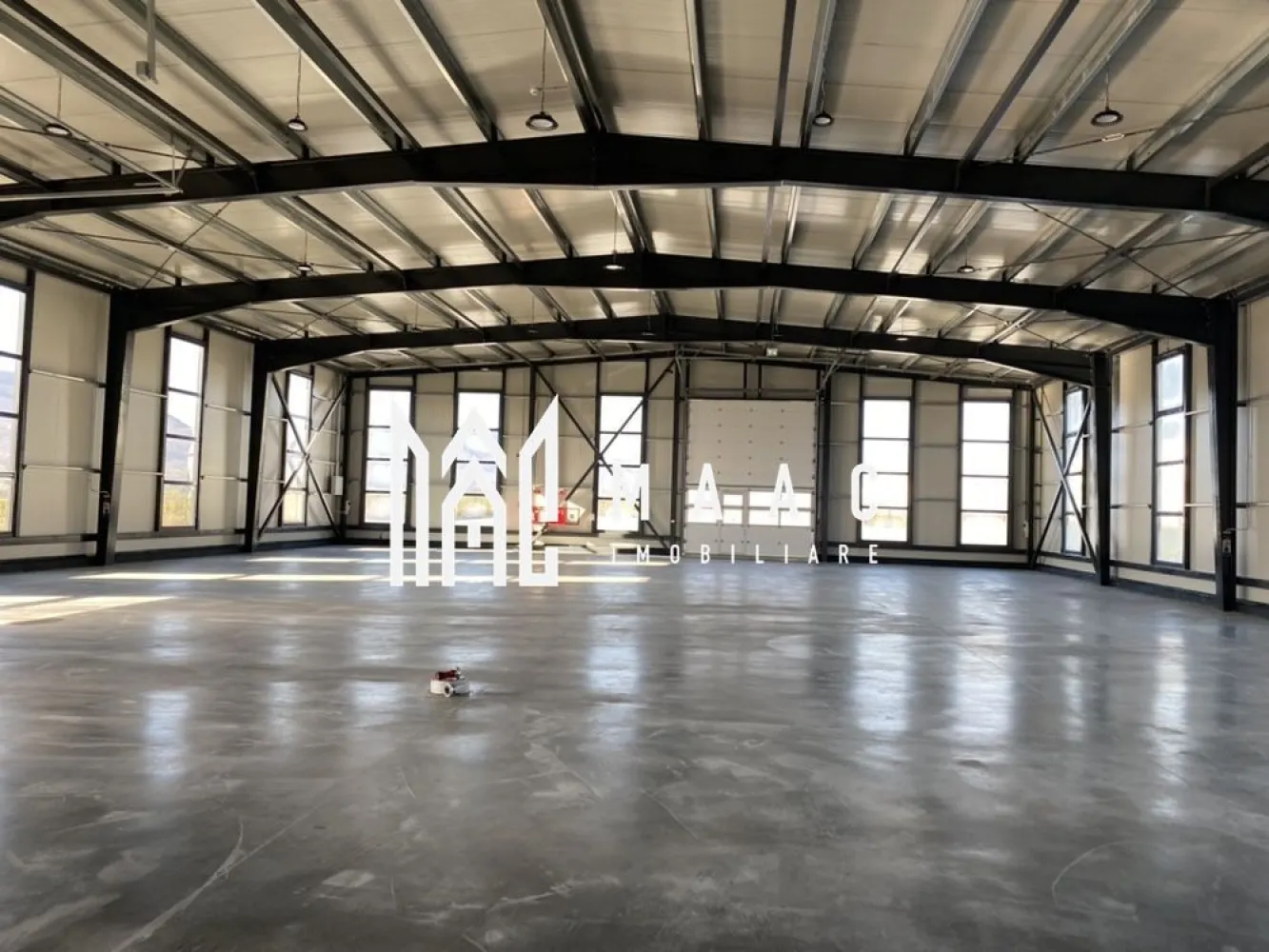 Hală logistică I 1200 mp I Acces TIR I Birouri I Tălmaciu - MAAC Imobiliare vă oferă spre închiriere o hală modernă, recent construită, perfect adaptată pentru activități de depozitare și logistică. Situată strategic, cu acces direct din DN7, această proprietate combină funcționalitatea cu dotări de ultimă generație. Caracteristici principale: Suprafață depozitare: 1200 mp, spațiu generos pentru desfășurarea activităților. Zona birouri: 132 mp – include birouri, recepție și toalete, asigurând un mediu optim pentru operațiuni administrative. Acces încărcare/descărcare: situat frontal și lateral pentru o logistică eficientă. Curte betonată: 2500 mp, destinată parcării și manevrării auto, proiectată pentru trafic greu. Poartă automatizată pentru acces facil și securizat. Incinta iluminată, împrejmuită cu gard și monitorizare video pentru siguranță optimă. Autorizare ISU/pompieri cu avize de funcționare, hidranti interiori și exteriori, conform normelor de siguranță. Dimensiunile halei (22m lățime x 48m lungime x 6m înălțime) permit o utilizare flexibilă, iar toate utilitățile necesare sunt asigurate. Aceasta poate fi locația perfectă pentru dezvoltarea afacerii dumneavoastră. Pentru mai multe detalii sau programarea unei vizionări, nu ezitați să ne contactați, specificând ID CP2557953! }}