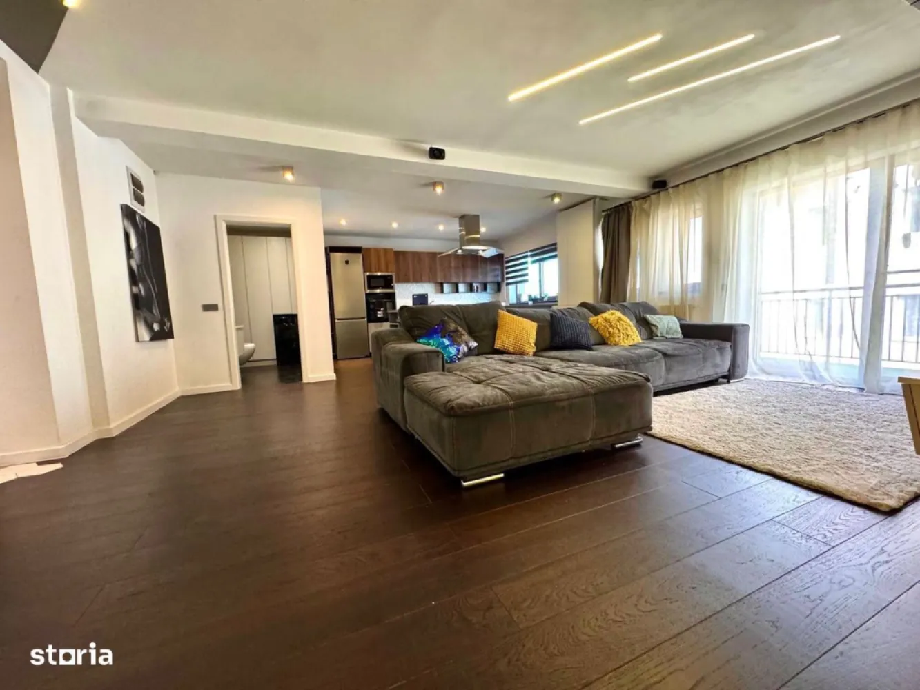 BRASADAS vinde ap 3 cam modern 106mp. mobilat, utilat, garaj. - Apartament spațios și elegant, situat pe strada Eugen Ionesco nr. 101, una dintre cele mai căutate zone rezidențiale din Cluj-Napoca, la doar 3 km de centru. Zona oferă tot ce ai nevoie la câțiva pași: stație de autobuz și easybox chiar în fața blocului, iar la 5 minute de mers pe jos se află Mega Image, Moldovan, farmacie și Profi.Locuința are 106,32 mp utili, completată de un balcon semi-închis de 4,5 mp și o terasă de 17,5 mp, acoperită, orientată spre sud și amenajată cu gazon artificial. Se vinde complet mobilată și utilată, cu electrocasnice moderne achiziționate în 2025 – un apartament pregătit pentru mutare imediată, fără nicio investiție suplimentară.Zona de zi, de peste 40 mp, include un living luminos și o bucătărie open-space, cu baie de oaspeți. Finisajele sunt premium – parchet triplu stratificat din stejar, lumini ambientale și o zonă de bar ce se poate transforma în masă de dining. Bucătăria este generoasă și complet echipată, iar din living și de pe balcon se deschide o frumoasă priveliște asupra orașului.Dormitorul matrimonial (22 mp) include dressing separat de 9,2 mp, birou, aer condiționat smart și acces direct la terasa însorită, perfectă pentru relaxare sau pentru plante ornamentale și aromatice. Baia principală (6,65 mp) este echipată cu produse Grohe, Kludi și Geberit, are încălzire în pardoseală, fereastră și walk-in shower spațios. Dormitorul secundar (15,56 mp), orientat estic, este ideal pentru copii sau oaspeți, dotat cu birou și lumini ambientale.Sistemul de încălzire este pe gaz, cu control smart Netatmo, iar iluminatul se face prin Philips Hue. Apartamentul este prevăzut cu senzori de securitate, internet fibră optică și folie privacy pe o parte din geamuri.Include două locuri de parcare în garajul subteran – unul proprietate și unul cu chirie redusă. Ambele sunt foarte spațioase, potrivite și pentru depozitare, dotate cu siguranță separată și prize 220V simple și industriale (ideal pentru mașini electrice).Imobilul are doar 6 apartamente și dispune de o grădină comună privată, folosită ca loc de joacă și zonă de relaxare. Comunitatea este liniștită și prietenoasă.Str. Eugen Ionesco 101, Cluj-NapocaComplet mobilat și utilat – electrocasnice 2025106,32 mp utili + terasă 17,5 mp + balcon 4,5 mpDouă locuri de parcare (1 proprietate + 1 chirie redusă)