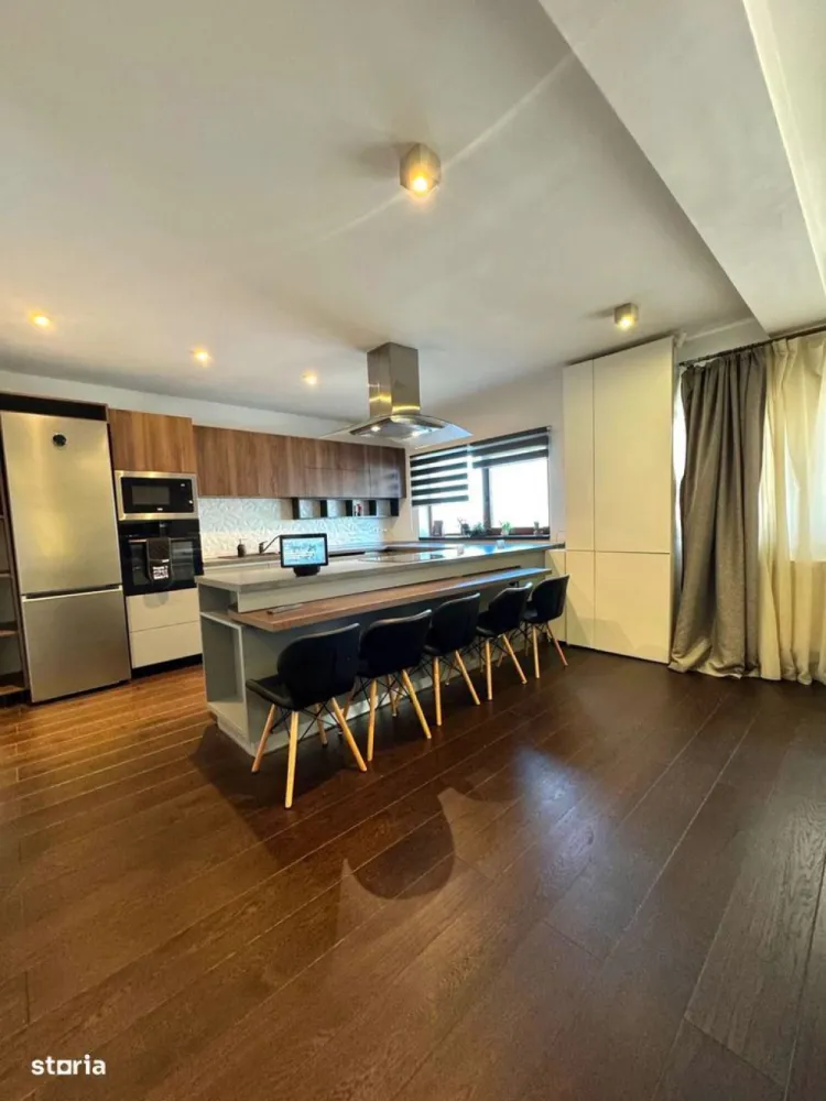 BRASADAS vinde ap 3 cam modern 106mp. mobilat, utilat, garaj. - Apartament spațios și elegant, situat pe strada Eugen Ionesco nr. 101, una dintre cele mai căutate zone rezidențiale din Cluj-Napoca, la doar 3 km de centru. Zona oferă tot ce ai nevoie la câțiva pași: stație de autobuz și easybox chiar în fața blocului, iar la 5 minute de mers pe jos se află Mega Image, Moldovan, farmacie și Profi.Locuința are 106,32 mp utili, completată de un balcon semi-închis de 4,5 mp și o terasă de 17,5 mp, acoperită, orientată spre sud și amenajată cu gazon artificial. Se vinde complet mobilată și utilată, cu electrocasnice moderne achiziționate în 2025 – un apartament pregătit pentru mutare imediată, fără nicio investiție suplimentară.Zona de zi, de peste 40 mp, include un living luminos și o bucătărie open-space, cu baie de oaspeți. Finisajele sunt premium – parchet triplu stratificat din stejar, lumini ambientale și o zonă de bar ce se poate transforma în masă de dining. Bucătăria este generoasă și complet echipată, iar din living și de pe balcon se deschide o frumoasă priveliște asupra orașului.Dormitorul matrimonial (22 mp) include dressing separat de 9,2 mp, birou, aer condiționat smart și acces direct la terasa însorită, perfectă pentru relaxare sau pentru plante ornamentale și aromatice. Baia principală (6,65 mp) este echipată cu produse Grohe, Kludi și Geberit, are încălzire în pardoseală, fereastră și walk-in shower spațios. Dormitorul secundar (15,56 mp), orientat estic, este ideal pentru copii sau oaspeți, dotat cu birou și lumini ambientale.Sistemul de încălzire este pe gaz, cu control smart Netatmo, iar iluminatul se face prin Philips Hue. Apartamentul este prevăzut cu senzori de securitate, internet fibră optică și folie privacy pe o parte din geamuri.Include două locuri de parcare în garajul subteran – unul proprietate și unul cu chirie redusă. Ambele sunt foarte spațioase, potrivite și pentru depozitare, dotate cu siguranță separată și prize 220V simple și industriale (ideal pentru mașini electrice).Imobilul are doar 6 apartamente și dispune de o grădină comună privată, folosită ca loc de joacă și zonă de relaxare. Comunitatea este liniștită și prietenoasă.Str. Eugen Ionesco 101, Cluj-NapocaComplet mobilat și utilat – electrocasnice 2025106,32 mp utili + terasă 17,5 mp + balcon 4,5 mpDouă locuri de parcare (1 proprietate + 1 chirie redusă)