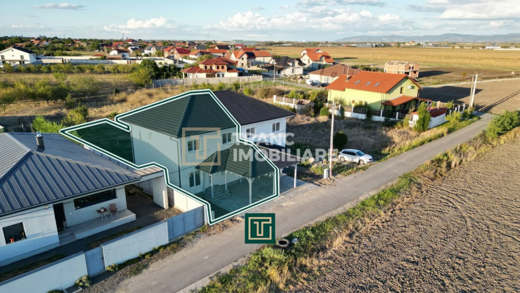 Jumătate de duplex nou cu 4 camere in Vladimirescu - În Vladimirescu, într-o zonă liniștită, dar cu acces rapid la centura Aradului, Tranc Imobiliare vă oferă la vânzare o locuinta formata din jumatate dintr-un duplex nou, finalizat în 2025 și pregătit să fie locuit imediat. Locuința se predă la cheie, nemobilată, cu finisaje moderne și de calitate superioara, gândite pentru a oferi un ambient elegant și ușor de personalizat de către viitorii proprietari.

Suprafața construită este de 154 mp, iar cea utilă de 96 mp, desfășurată pe parter, mansardă și pod. Terenul are 342 mp, cu un front stradal de 8 metri și acces direct din drum asfaltat. Compartimentarea este practică și bine gândită: living luminos, bucătărie spațioasă, trei dormitoare, două băi complet funcționale, o terasă acoperită de 7,6 mp, dar și o cameră tehnică situată sub scară, unde se află centrala termică și spațiu suplimentar pentru depozitare și mașina de spălat. În fața casei, proprietarii beneficiază de o parcare acoperită de 18 mp.
Finisajele interioare sunt moderne și luminoase, cu pardoseli din parchet și gresie în tonuri calde, pereți zugrăviți cu lavabil alb, plinte elegante, uși interioare albe cu design contemporan și băi complet amenajate cu faianță de bun gust. Totul este nou și pregătit pentru a fi folosit din prima zi.

Din punct de vedere tehnic, casa este solid construită, cu pereți din cărămidă, fundație de beton și acoperiș din țiglă ceramică. Izolația exterioară din polistiren de 10 cm asigură eficiență energetică, iar instalațiile electrice din cupru și cele sanitare din PPR oferă durabilitate. Încălzirea se realizează prin centrală pe gaz, cu incălzire în pardoseală. Proprietatea este racordată la toate utilitățile, apă, gaz, curent trifazic, canalizare.
Chiar dacă dormitoarele sunt mai compacte, avantajele acestei proprietăți, prin faptul că este o construcția nouă, finisajele sunt moderne, are eficiența energetică ridicată și zona este liniștită, dar totuși aproape de centură si de zona centrală a satului Vladimirescu, o transformă într-o alegere foarte bună atât pentru locuință permanentă, cât și ca investiție.

Curtea poate fi transformată într-o grădină verde, cu gazon, flori și arbori, sau într-un spațiu de relaxare cu foișor și loc de grătar. Pentru familiile cu copii, terenul poate deveni loc de joacă privat, iar pentru cei care apreciază confortul, există suficient spațiu pentru o piscină mică ori o zonă de terasă extinsă. Astfel, cumpărătorul nu achiziționează doar o locuință modernă, ci și libertatea de a-și crea propriul colț de liniște și confort după dorințe.

Această locuința este soluția ideală pentru o familie care își dorește o casă nouă, bine compartimentată și gata de locuit, unde tot ce rămâne de făcut este să fie mobilată și decorată după gustul personal.