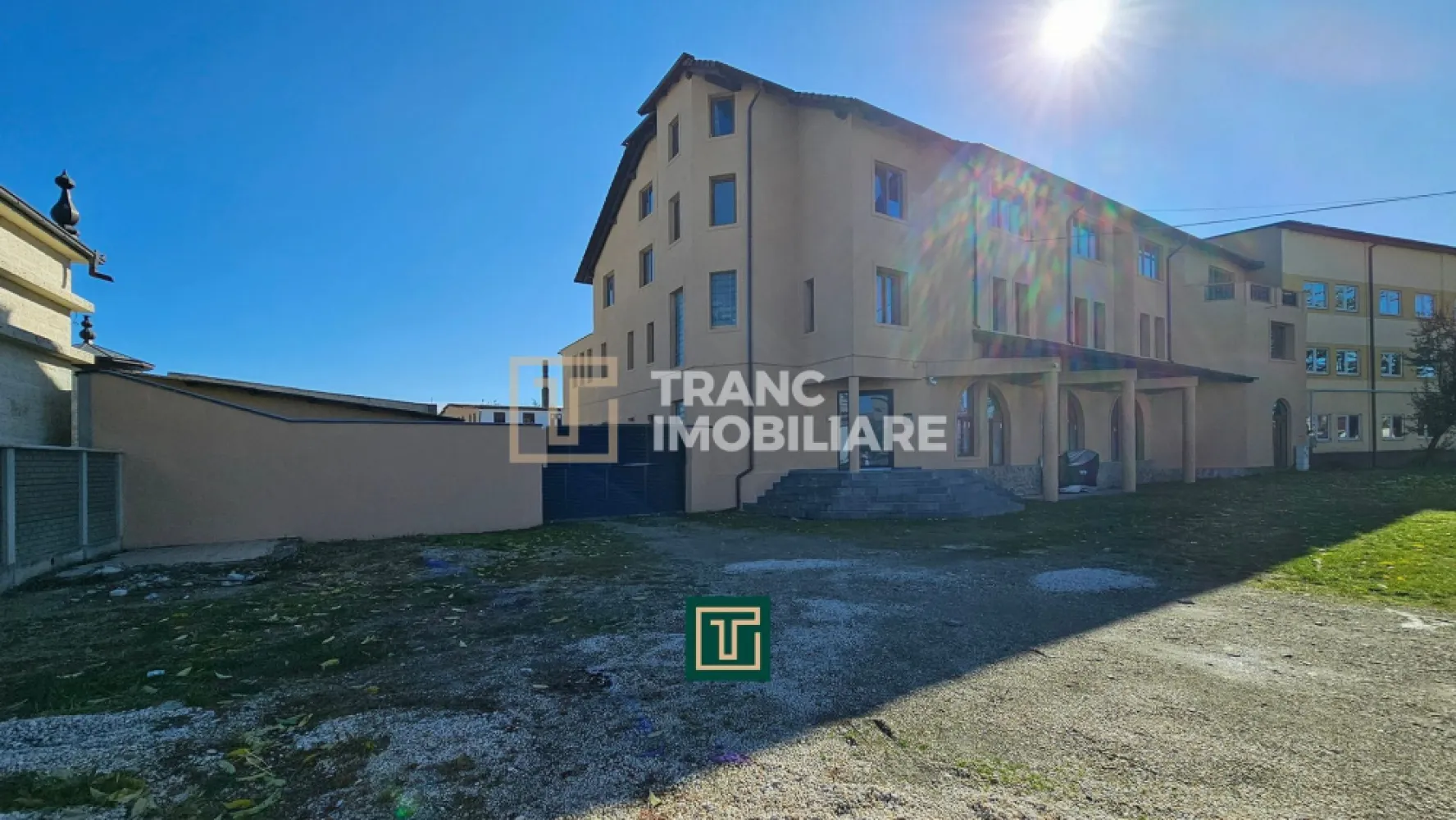 Proprietate multifunctionala - teren generos, cladire si hala in Lugoj - Vă prezentăm o oportunitate imobiliară rară în Lugoj, destinată unui investitor care înțelege valoarea activelor cu suprafețe mari, structură solidă și potențial real de repoziționare. Proprietatea este amplasată în Zona Stadion, într-o zonă foarte bine conectată, vizibilă și ușor accesibilă, vis-a-vis de o sală de evenimente premium, ceea ce îi conferă un plus de imagine, expunere și atractivitate pentru activități comerciale, administrative, medicale, educaționale sau mixte.

Ansamblul este compus dintr-un teren de 2.659 mp, cu mențiunea importantă că, după rectificare, suprafața va depăși 3.100 mp, aspect care adaugă valoare suplimentară investiției. Proprietatea beneficiază de un front stradal de 38 ml și include două corpuri principale: o clădire din cărămidă, dispusă pe Subsol + Parter + 2 Etaje, și o hală pe două niveluri, Parter + Etaj, construită din cărămidă și BCA.

Suprafața utilă totală a clădirii principale este de 1.387,7 mp, iar hala are o suprafață utilă de 1.316 mp. În total, vorbim despre un activ de dimensiuni considerabile, greu de replicat astăzi în aceeași formulă, mai ales într-o zonă urbană bine poziționată. Clădirea permite inclusiv instalarea unui lift, ceea ce o face potrivită pentru transformare în centru medical, sediu de companie, clinică, spații de birouri, centru educațional, aparthotel, centru logistic administrativ sau proiect mixt.

Clădirea principală are o structură solidă și un exterior deja configurat, în timp ce interiorul necesită renovare parțială, estimată la aproximativ 20%. La parter există aproximativ 260 mp care necesită renovare totală, însă exact această zonă poate reprezenta unul dintre cele mai valoroase atuuri ale proprietății, deoarece oferă libertate de recompartimentare și adaptare după destinația dorită.

La subsol, regăsim o suprafață de 101,8 mp, compusă din 3 boxe și casa scării cu zonă de degajament, spațiu util pentru arhivare, depozitare, suport tehnic sau flux operațional.

La parter, proprietatea oferă 465,4 mp, compuși din 2 încăperi tip salon sau spații de depozitare, 4 camere/birouri, 1 hol, 1 casă a scării cu zonă de degajament și 1 grup sanitar. Piesa centrală a acestui nivel este un spațiu open-space de aproximativ 256 mp, cu potențial excelent pentru restaurant, sală de prezentare, showroom, spațiu comercial premium, call-center, zonă de birouri open-space sau sală de evenimente private/business. Acest spațiu poate fi păstrat deschis sau compartimentat în funcție de conceptul de exploatare ales.

La etajul 1, suprafața utilă este de 474 mp, iar compartimentarea cuprinde 1 încăpere tip salon sau spațiu de depozitare, 7 camere/birouri, 2 holuri, 1 casă a scării cu zonă de degajament și 1 grup sanitar. Acest nivel este ideal pentru activități administrative, office, consultanță, servicii profesionale, cabinete sau organizare operațională pe departamente.

La etajul 2, suprafața utilă este de 346,5 mp, nivelul fiind organizat în două apartamente de dimensiuni mari, fapt care adaugă o componentă valoroasă de utilizare mixtă. Acestea pot funcționa ca locuință de serviciu, zonă de protocol, apartamente pentru management, spații executive sau pot fi integrate într-un concept mai amplu de cazare ori utilizare premium.

Apartamentul 1 are 177,6 mp și este compus din hol, baie, debara, bucătărie, sufragerie cu ieșire pe terasă și 3 dormitoare, dintre care două au vedere la stradă, iar unul beneficiază de ieșire pe terasă.
Apartamentul 2 are 155,5 mp utili + 8,4 mp balcon și este compus din hol, baie, debara, bucătărie cu terasă orientată spre curtea interioară, sufragerie cu terasă orientată spre curtea interioară și 2 dormitoare cu vedere la stradă, plus balcon.
Ambele apartamente au acces la terasă comună.

Din punct de vedere tehnic, proprietatea are un avantaj important: sistemele de încălzire sunt deja gândite separat, pe zone, ceea ce permite exploatare eficientă și control diferențiat al costurilor.

La parter, încălzirea este realizată prin calorifere, iar distribuția este organizată astfel:
există o centrală termică dedicată pentru zona compartimentată, respectiv holul și camera tip salon, iar separat există o a doua centrală termică pentru salonul open-space de aproximativ 256 mp. Această separare este extrem de utilă pentru un investitor care dorește să utilizeze spațiile independent sau să le închirieze diferențiat.

La etajul 1, proprietatea beneficiază de încălzire în pardoseală cu agent termic, deservită de o centrală termică separată, ceea ce oferă un nivel superior de confort și un avantaj clar pentru activități office, medicale sau administrative.

La etajul 2, încălzirea este realizată prin calorifere, iar nivelul este deservit de două centrale termice suplimentare, ceea ce permite o administrare eficientă și independentă a spațiilor de locuire sau protocol.

Gazul este în curs de instalare, iar proprietatea va fi livrată cu sistemul de încălzire funcțional. În plus, pentru optimizarea costurilor de operare și alinierea la standardele actuale, se recomandă montarea de panouri fotovoltaice pe acoperișuri, inclusiv prin accesarea programelor de finanțare disponibile, precum și integrarea unei pompe de căldură, soluție care poate reduce semnificativ costurile energetice și poate crește valoarea percepută a proprietății în exploatare.

Cladirea are structurata pe exterior asigurand un aspect comercial si ingrijit.

Hala este dispusă pe două niveluri, P+E, acoperișul halei necesită înlocuire, are o suprafață utilă totală de 1.316 mp și este compusă din 8 încăperi, cu suprafețe cuprinse între 10,4 mp și 654 mp, plus o cameră tehnică și casa scării. În forma actuală, hala este funcțională, însă poate fi cosmetizată, reorganizată, recompartimentată sau convertită după necesitățile noului proprietar. Poate susține activități de depozitare, producție ușoară, logistică, atelier, showroom tehnic, centru de distribuție sau spații hibride business-industrial.

La nivel de utilități și dotări, proprietatea beneficiază de:
curent trifazic,
apă din rețea,
canalizare,
gaz la stradă,
internet prin fibră optică,
cablu TV,
putere instalată de 40 kW,
instalație electrică din cupru,
camere de supraveghere,
ferestre cu tâmplărie PVC,
pardoseli mixte din gresie, parchet laminat și mochetă.

Zona este lipsită de factori perturbatori majori, nefiind semnalate probleme de miros sau zgomot, iar proprietatea beneficiază de iluminat public și drum asfaltat.

Un argument extrem de important pentru orice investitor este poziționarea. Proprietatea se află în Zona Stadion din Lugoj, într-o zonă bine conectată la repere esențiale ale orașului:
Stadionul Vulturii – aproximativ 240 m
Lidl – aproximativ 400 m
centrul orașului – aproximativ 1,5 km
gara – aproximativ 1 km
Carrefour – aproximativ 1 km
Penny – aproximativ 1 km
grădiniță – aproximativ 60 m
școală gimnazială – aproximativ 1 km
Spitalul Municipal „Dr. Teodor Andrei” – aproximativ 2,3 km

Această proximitate față de puncte comerciale, instituții, servicii medicale, educaționale și de transport crește semnificativ flexibilitatea de utilizare a proprietății și atractivitatea ei pentru viitori chiriași, colaboratori sau operatori.

Pentru un investitor din alt oraș, Lugojul are o logică economică solidă. Municipiul beneficiază de conexiune rapidă la infrastructura majoră din vestul României, iar documentele oficiale ale Primăriei Lugoj arată explicit importanța conexiunii către coridorul A1, precum și direcția locală de dezvoltare urbană, economică și de mobilitate. Strategia de dezvoltare a municipiului pentru 2021–2027 pune accent pe mediul de afaceri, infrastructură, servicii și creșterea calității urbane, iar Planul de Mobilitate Urbană evidențiază rolul conexiunii rutiere rapide către A1 pentru distribuția mărfurilor și mobilitatea forței de muncă.

Acest tip de activ nu se cumpără doar pentru ce este astăzi, ci pentru ce poate deveni în 12–24 de luni printr-o repoziționare inteligentă. Proprietatea are suprafață, structură, acces, utilități, versatilitate și o distribuție care permite exploatare etapizată. Se pretează foarte bine pentru:
sediu regional,
clinică sau centru medical,
centru educațional,
showroom + office + depozitare,
business center,
restaurant / evenimente private / sală de prezentare,
proiect mixt administrativ + rezidențial,
sau conversie într-un concept adaptat nevoilor reale ale pieței locale.

În esență, vorbim despre o proprietate mare, bine amplasată, greu de înlocuit, cu structură solidă și cu un potențial real de transformare într-un activ modern, eficient și valoros.

Din perspectivă investițională, unul dintre cele mai puternice argumente ale acestei proprietăți este raportul dintre valoarea estimată de înlocuire și prețul la care proprietarul este dispus să o vândă. Conform calculelor furnizate, valoarea estimată a ansamblului, raportată la costul construirii de la zero, este de aproximativ 1.849.597 euro (teren 83 euro / mp + TVA, cladire 700 euro / mp util (nu construit) +TVA, hala 500 euro / mp util (nu construit) +TVA). Cu toate acestea, proprietarul este dispus să vândă proprietatea la prețul de 1.210.000 euro (teren 83 euro / mp + TVA, cladire 470 euro / mp util (nu construit) +TVA, hala 290 euro / mp util (nu construit) +TVA) ceea ce oferă viitorului cumpărător un avantaj investițional semnificativ.

Diferența până la valoarea estimată de 1.849.597 euro poate fi folosită strategic pentru renovare, modernizare, recompartimentare, eficientizare energetică și aducerea întregului ansamblu la un standard actual, apropiat de cel al unei construcții noi. Tocmai aici se află una dintre marile oportunități ale acestei achiziții: investitorul nu cumpără doar un imobil, ci preia un activ cu structură existentă, suprafețe generoase și poziționare foarte bună, având în același timp spațiu financiar pentru a-l transforma într-un produs imobiliar modern și mult mai valoros.

În cazul în care se urmărește o revânzare ulterioară, această diferență poate contribui direct la creșterea substanțială a valorii activului, prin repoziționarea proprietății într-o formă actualizată, eficientă și adaptată cerințelor pieței.

Astfel de proprietăți nu apar des în piață, iar cele care oferă în același timp teren generos, clădiri masive, flexibilitate de utilizare, poziționare bună și un avantaj real de investiție sunt și mai rare. Dacă ești în punctul în care cauți nu doar un imobil, ci un activ care poate fi transformat inteligent într-un proiect valoros, profitabil și greu de replicat, merită să analizezi această oportunitate înainte să o facă altcineva. Contactează-ne pentru detalii complete, documentație și programarea unei vizionări private. Unele investiții nu trebuie urmărite de pe margine, ci securizate la timp.