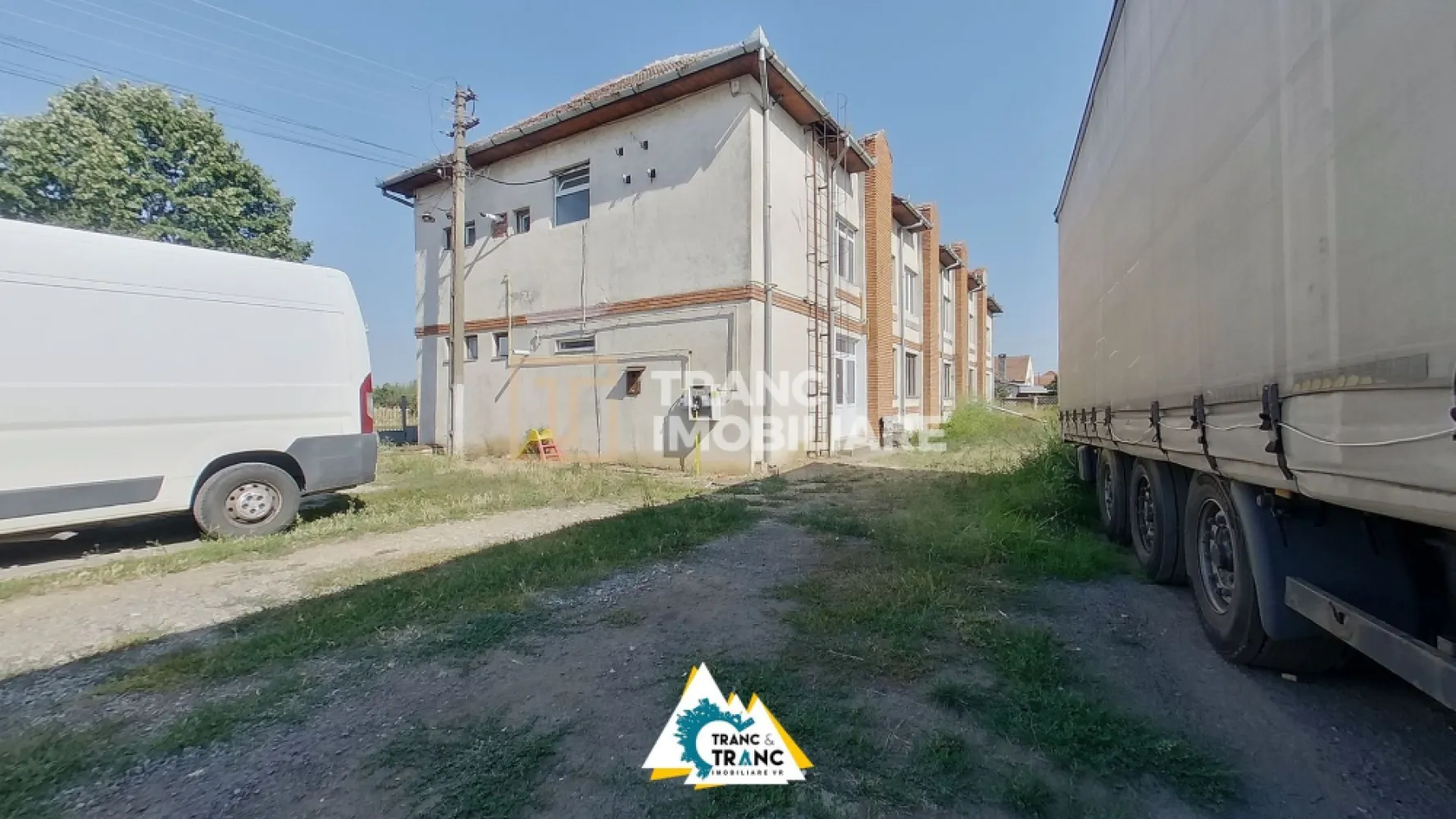 Clădire împunătoare de 540 mp pe 2 nivele în Sânnicolau Mic - Într-o zonă industrială aflată în plină expansiune, în Sânnicolau Mic, poți descoperi o clădire impunătoare, solidă și plină de potențial disponibilă la vânzare în exclusivitate prin Agenția Tranc Imobiliare. Construită pe piloni de beton, cu pereți din cărămidă și geamuri termopan, ea poartă în structura sa siguranța unei investiții de durată.

Poziția sa nu este întâmplătoare – se află în Sannicolau la intersecția a două străzi cu fronturi stradale de 9 ml la o strada și 30 ml la cealata strada care duce direct către noua centură a orașului. Clădirea se află într-o zonă unde prezentul se întâlnește cu viitorul și unde fiecare metru pătrat promite valoare în creștere.

Spațiul este generos de 540 mp desfășurați pe parter și etaj. La parter întâlnim, două încăperi vaste de depozitare de 90 mp fiecare, birou, grup sanitar și casa scării care așteaptă să își continue rolul funcțional. La etaj vom găsi, o sală deschisă de aproape 200 mp, completată de bucătărie, 2 holuri, grup sanitar și casa scării. În prezent, etajul își așteaptă următorul destin – poate o sală de sport, poate un atelier de creație, poate birouri moderne. În trecut a găzduit croitorii, antrenamente de judo, iar astăzi este pregătită să se reinventeze. Clădirea este ocupată de chiriașii existenți de la parter și își deschide orizontul pentru noi povești la etaj. 

Cu toate utilitățile la îndemână – curent trifazic, gaz, apă, canalizare, încălzire centrală – ea poate deveni ceea ce viitorul proprietar își dorește: spațiu de producție, depozitare, centru de fitness sau un sediu impunător de companie. În curte sau in fața clădirii exista posibilitate de parcare a autoturismelor sau a mașinilor de transport marfa.

Aici vei cumpăra mai mult decât ziduri. Cumperi o oportunitate sigură, o investiție ce promite profit și creștere odată cu dezvoltarea zonei și modernizarea accesului către centură.

Această clădire nu te așteaptă. Ea își caută următorul stăpân care să vadă dincolo de pereți, să simtă potențialul și să îl transforme în realitate.
Sună acum și descoperă cum această poveste poate deveni a ta.

Pretul afisat nu contine TVA