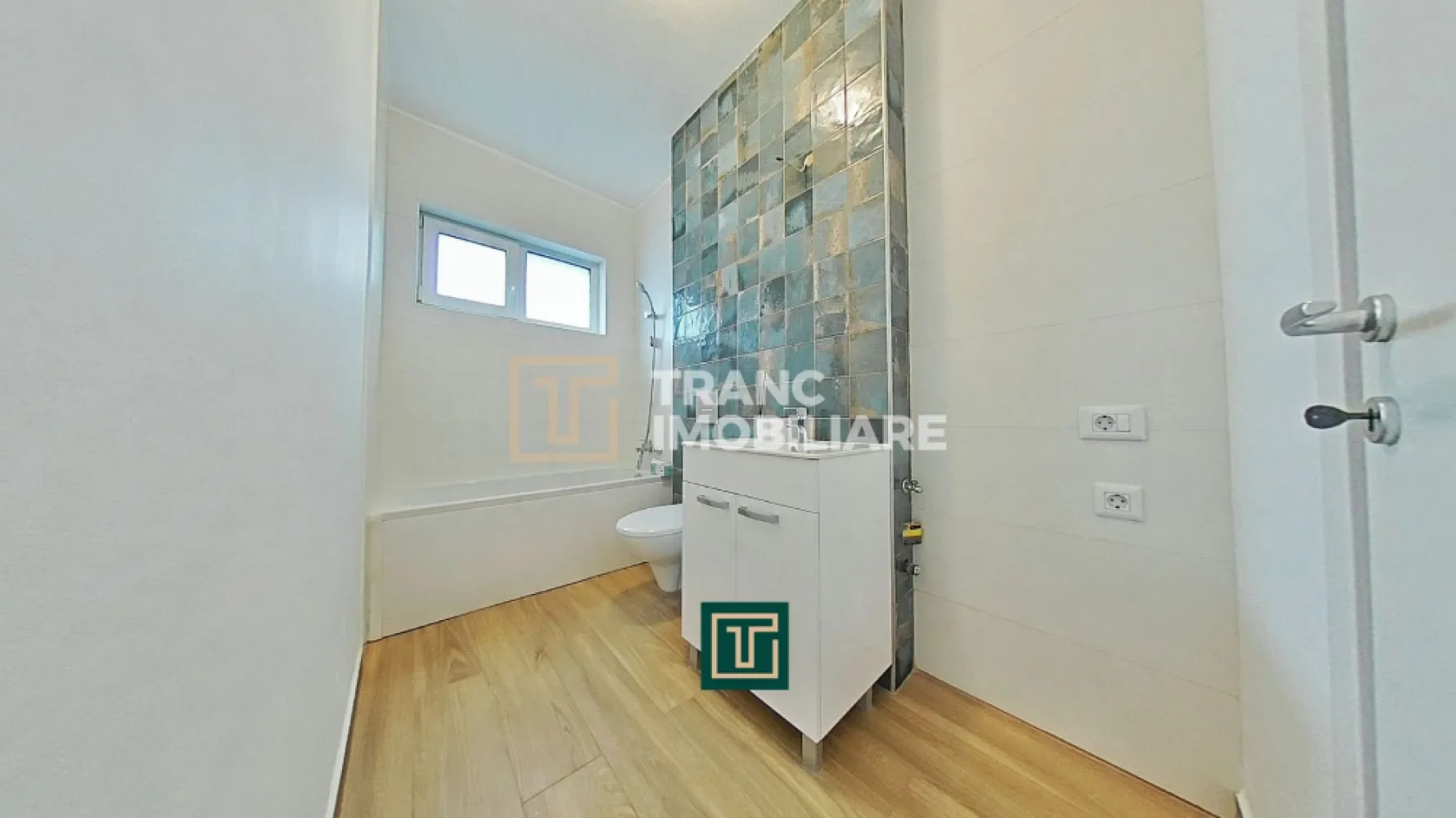 Apartament cu 3 camere în bloc nou – Via Carmina, Vladimirescu - Comision 0% pentru cumpărător!

Îți prezentăm spre vânzare un apartament modern cu 3 camere, situat într-un imobil nou, finalizat în anul 2024, parte din proiectul rezidențial Via Carmina, recunoscut ca una dintre cele mai apreciate zone din Vladimirescu, județul Arad. Zona este liniștită, sigură și bine conectată cu orașul, fiind potrivită atât pentru familii, cât și pentru persoane active.

Apartamentul este poziționat la etajul 2 al unui bloc cu 4 etaje, prevăzut cu lift, și dispune de o suprafață utilă de 64,45 mp, respectiv 77,34 mp suprafață construită. Compartimentarea semidecomandată este eficientă și aerisită, incluzând două dormitoare, un living cu bucătărie open-space, o baie și un balcon, oferind un spațiu funcțional și plăcut pentru viața de zi cu zi.

Locuința se evidențiază prin finisaje contemporane și dotări de calitate: parchet, gresie, vopsea lavabilă, centrală termică proprie pe gaz de 24 kW și sistem de încălzire prin pardoseală, asigurând un confort optim în orice sezon. Apartamentul se predă cu bucătăria complet mobilată și utilată, aer condiționat cu control de la distanță, videointerfon și izolație termică performantă.

Ansamblul rezidențial pune la dispoziție numeroase facilități: loc de joacă pentru copii, alei de promenadă, masă de ping-pong, zonă de grătar și spații dedicate relaxării în aer liber. Întreaga zonă este amenajată modern, cu drumuri asfaltate și iluminat public.
Prețul afișat nu include TVA 21% și locul de parcare.
