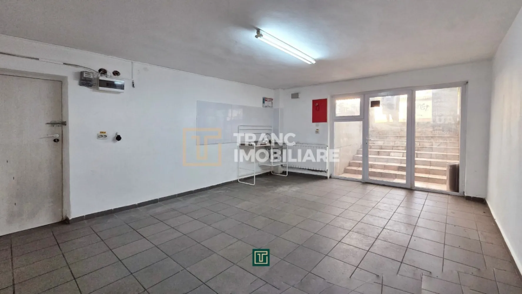 Spațiu comercial în Calea Lipovei – Zonă excelentă, aproape de Iulius Town - Vă propunem spre închiriere un spațiu cu 1 cameră, în suprafață utilă de 26 mp (30 mp construiți), situat la demisolul unui imobil construit în 2007, cu regim de înălțime P+1E. Spațiul este potrivit pentru activități care nu necesită punct de lucru cu trafic intens, birou administrativ, arhivă, atelier ușor sau depozitare.

Proprietatea dispune de curent trifazic, apă și canalizare din rețeaua publică, precum și izolație termică exterioară. Baia este comună, utilizată împreună cu alți chiriași din clădire. Menționăm că spațiul nu este înscris în CF ca spațiu comercial, aspect ce limitează desfășurarea unor activități comerciale cu public.

Un avantaj major îl reprezintă poziționarea excelentă, la doar 150 m de artera principală care face legătura între Timișoara și Dumbrăvița, în imediata apropiere de Iulius Town Timișoara. În vecinătate regăsim benzinărie, cafenele, farmacie, hypermarket, stație de autobuz și stație de tramvai, oferind acces facil și vizibilitate bună.

Dacă sunteți în căutarea unui spațiu accesibil, bine poziționat și potrivit pentru activități administrative sau depozitare, această proprietate poate fi soluția potrivită.