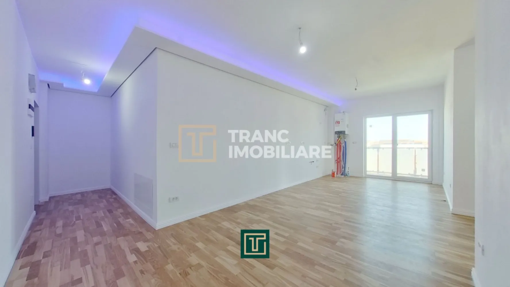 Apartament modern cu 3 camere in bloc nou in Micalaca zona Miorita - In continuare ne face o deosebită plăcere să îți prezentăm un apartament cu 3 camere într-un bloc nou și modern, cu lift, construit în 2023, poziționat pe Calea Radnei, în Micalaca, zona Miorița, vis-a-vis de Rompetrol, într-o zonă unde blocurile noi apar rar, iar proprietățile moderne, bine gândite, se vând repede. Apartamentul are 57 mp utili și un balcon generos de 14 mp, iar compartimentarea este exact genul acela care îți face viața mai ușoară zi de zi, fără spații irosite și fără compromisuri. În plus, blocul este dotat cu lift, un detaliu care contează enorm în confortul zilnic, indiferent de vârstă sau stilul tău de viață.

În interior te întâmpină o sufragerie luminoasă în open space cu bucătăria, un spațiu aerisit, modern, susținut de geamuri vitrate mari care lasă lumina naturală să intre exact cât trebuie. Holul de intrare și zona open-space sunt puse în valoare de un tavan decorat cu scafe și proiecții LED, pe care le poți seta în culorile pe care le dorești, astfel încât atmosfera să fie mereu adaptată stării tale: cald și relaxant seara, elegant când ai musafiri, discret când vrei liniște.

Confortul este completat de încălzirea prin pardoseală, asigurată de o centrală termică pe gaz, astfel încât ai o temperatură plăcută, uniformă, și control total asupra consumului și ambientului, exact cum își dorește cineva care vrea un apartament modern, făcut pentru viața reală.

Zona de noapte este clară și practică, ai un dormitor matrimonial pentru intimitate și odihnă și un dormitor pentru copil, perfect și ca dormitor, și ca spațiu de studiu sau birou, în funcție de nevoile tale. Parchetul este nou, premium, triplustratificat, iar asta se simte imediat, nu doar ca aspect, ci și ca senzație de confort.

Unul dintre punctele forte reale ale apartamentului este balconul, Cu 14 mp, pe două părți, cu acces atât din sufragerie, cât și din dormitorul matrimonial. Este acel tip de detaliu care schimbă complet felul în care folosești casa, pentru că ai un spațiu exterior real, conectat natural cu zona de zi și cu intimitatea dormitorului. Balconul este modern, cu rame de metal și sticlă, într-un design minimalist, plăcut și elegant, genul acela care arată bine și peste ani.

Baia este luminoasă, are duș și este completată de o oglindă luminată, un detaliu mic, dar care ridică imediat senzația de „nou” și de spațiu îngrijit, bine finisat.
Dacă îți dorești un apartament nou, modern, cu lumină naturală, încălzire în pardoseală, finisaje care se simt premium, un balcon mare cu design minimalist și o compartimentare practică pentru viața de zi cu zi, atunci merită să-l vezi pe viu. Pentru detalii și programarea unei vizionări, scrie-mi sau sună-mă.