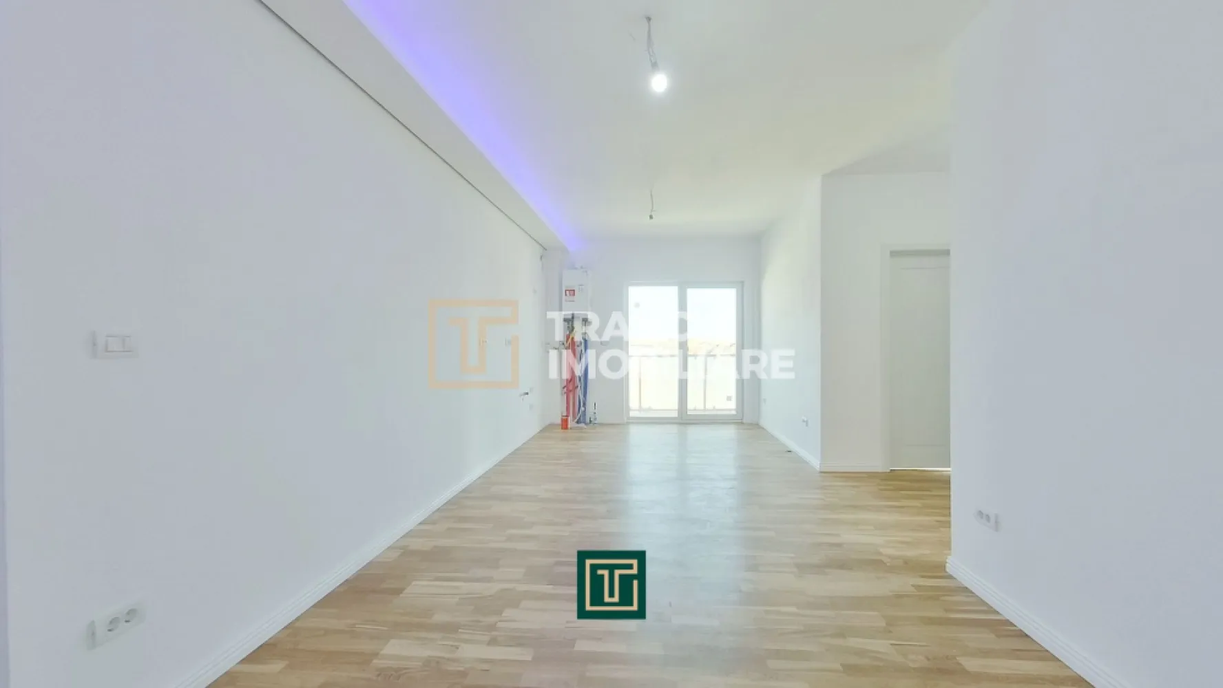 Apartament modern cu 3 camere in bloc nou in Micalaca zona Miorita - In continuare ne face o deosebită plăcere să îți prezentăm un apartament cu 3 camere într-un bloc nou și modern, cu lift, construit în 2023, poziționat pe Calea Radnei, în Micalaca, zona Miorița, vis-a-vis de Rompetrol, într-o zonă unde blocurile noi apar rar, iar proprietățile moderne, bine gândite, se vând repede. Apartamentul are 57 mp utili și un balcon generos de 14 mp, iar compartimentarea este exact genul acela care îți face viața mai ușoară zi de zi, fără spații irosite și fără compromisuri. În plus, blocul este dotat cu lift, un detaliu care contează enorm în confortul zilnic, indiferent de vârstă sau stilul tău de viață.

În interior te întâmpină o sufragerie luminoasă în open space cu bucătăria, un spațiu aerisit, modern, susținut de geamuri vitrate mari care lasă lumina naturală să intre exact cât trebuie. Holul de intrare și zona open-space sunt puse în valoare de un tavan decorat cu scafe și proiecții LED, pe care le poți seta în culorile pe care le dorești, astfel încât atmosfera să fie mereu adaptată stării tale: cald și relaxant seara, elegant când ai musafiri, discret când vrei liniște.

Confortul este completat de încălzirea prin pardoseală, asigurată de o centrală termică pe gaz, astfel încât ai o temperatură plăcută, uniformă, și control total asupra consumului și ambientului, exact cum își dorește cineva care vrea un apartament modern, făcut pentru viața reală.

Zona de noapte este clară și practică, ai un dormitor matrimonial pentru intimitate și odihnă și un dormitor pentru copil, perfect și ca dormitor, și ca spațiu de studiu sau birou, în funcție de nevoile tale. Parchetul este nou, premium, triplustratificat, iar asta se simte imediat, nu doar ca aspect, ci și ca senzație de confort.

Unul dintre punctele forte reale ale apartamentului este balconul, Cu 14 mp, pe două părți, cu acces atât din sufragerie, cât și din dormitorul matrimonial. Este acel tip de detaliu care schimbă complet felul în care folosești casa, pentru că ai un spațiu exterior real, conectat natural cu zona de zi și cu intimitatea dormitorului. Balconul este modern, cu rame de metal și sticlă, într-un design minimalist, plăcut și elegant, genul acela care arată bine și peste ani.

Baia este luminoasă, are duș și este completată de o oglindă luminată, un detaliu mic, dar care ridică imediat senzația de „nou” și de spațiu îngrijit, bine finisat.
Dacă îți dorești un apartament nou, modern, cu lumină naturală, încălzire în pardoseală, finisaje care se simt premium, un balcon mare cu design minimalist și o compartimentare practică pentru viața de zi cu zi, atunci merită să-l vezi pe viu. Pentru detalii și programarea unei vizionări, scrie-mi sau sună-mă.