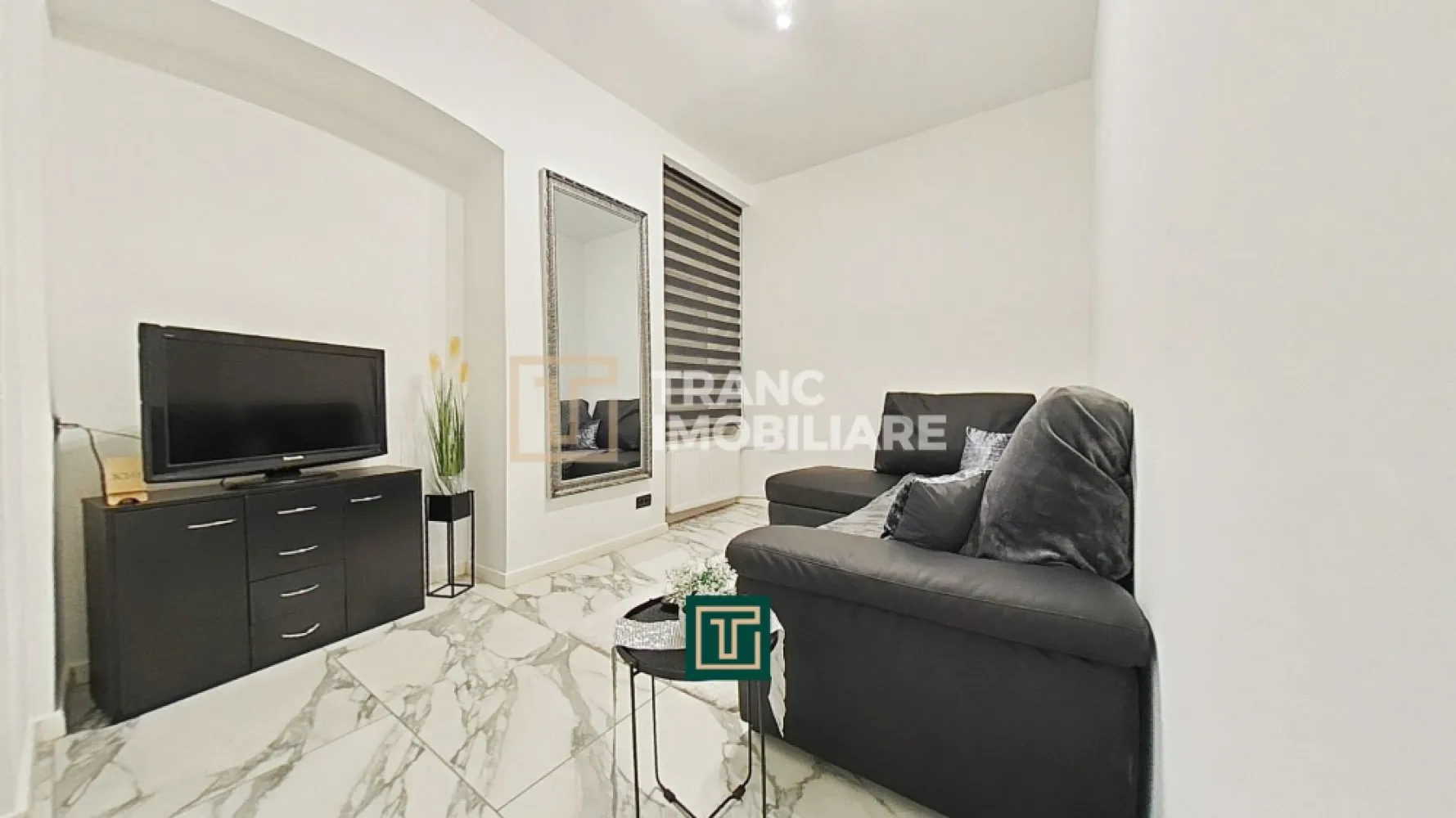 Apartament modern cu 2 camere de închiriat – Bulevardul Revoluției, Arad - Îți prezentăm un apartament modern și elegant, situat chiar în inima orașului Arad, pe Bulevardul Revoluției, în imediata apropiere a Teatrului Clasic „Ioan Slavici”. Cu o suprafață desfășurată de 77 mp, acest apartament oferă un stil de viață confortabil și rafinat, potrivit atât pentru o persoană activă, cât și pentru un cuplu care apreciază calitatea și proximitatea față de toate punctele de interes din oraș.

Apartamentul este amplasat la etajul 1 al unui imobil cu 3 nivele și are o compartimentare practică, compus dintr-un dormitor primitor, o sufragerie luminoasă, o bucătărie complet utilată și o baie modernă.

Renovat integral în 2024, apartamentul se remarcă prin finisaje contemporane și dotări de ultimă generație: întrerupătoare tactile, rolete acționate electric, aer condiționat, pardoseală cu gresie porțelanată, instalații electrice și sanitare din cupru. Încălzirea este asigurată prin sistemul centralizat CET.

Poziționarea ultracentrală este unul dintre cele mai mari avantaje — la doar câțiva pași se află cafenele, restaurante, Teatru, Catedrala, primăria, facultate, licee, farmacie, frizerie, dentist, hypermarket și stații de tramvai.

Un apartament care îmbină perfect confortul modern cu farmecul centrului istoric al Aradului — pregătit să devină noul tău cămin!