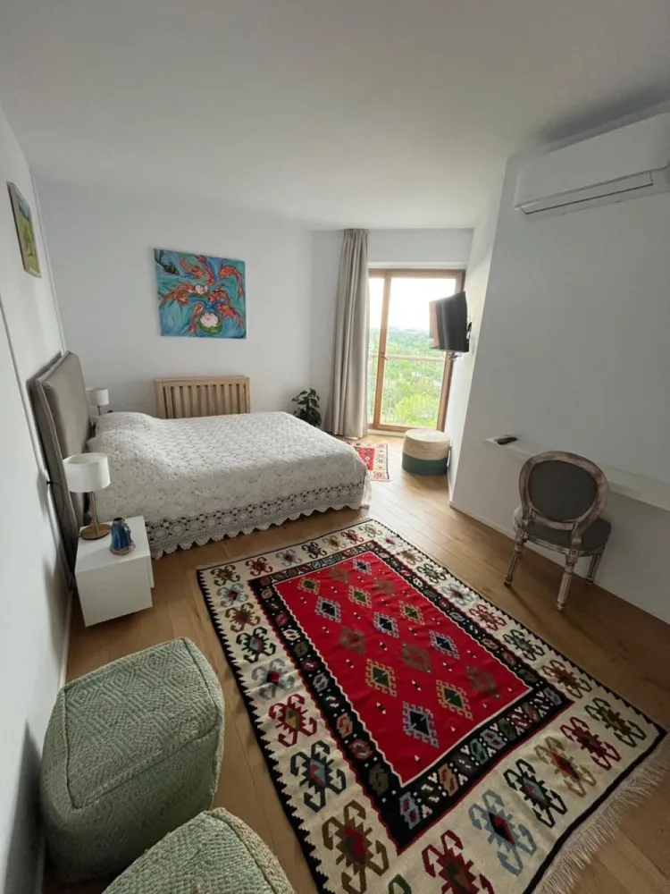 Piata Presei Libere apartament 3 camere de vanzare - K Imobiliare va propune in zona Piata Presei Libere apartament care arată foarte bine renovat, luminos și modern, cu un stil curat și aerisit. Se vede că a fost gândit pentru confort și estetică.

 Living
Spațios, open-space cu zona de dining
Multă lumină naturală datorită ferestrelor mari
Mobilier simplu, elegant
Bibliotecă încorporată + TV montat pe perete → aspect ordonat

Amplasată lângă balcon
Foarte luminoasă
Masă din sticlă + scaune elegante → senzație de spațiu
 Dormitoare
Luminoase, cu acces sau vedere spre exterior
Mobilate minimalist, dar plăcut
Un dormitor are birou (bun pentru work from home)
Aer condiționat instalat

 Băi
Design modern
Duș walk-in
Finisaje curate și actuale
Terasă & priveliște (mare plus)
Balcon curbat – element arhitectural rar
Priveliște deschisă spre oraș și spațiu verde
Etaj înalt → lumină + intimitate

 Compartimentare & suprafață
~92 mp utili + ~12 mp terasă = ~104 mp total
Compartimentare eficientă:
Separare bună zi/noapte
Spații de depozitare (hol + dressing)
🏢 Bloc & facilități
Construit în 2007
Dotări importante:
Sală fitness
Curățătorie
Restaurant
Pază 24/7
Lifturi Schindler

Foarte luminos
Terasă + vedere spectaculoasă
Complet mobilat (gata de mutare)
Renovare modernă
Facilități multiple în complex

Este un apartament foarte bun ca lifestyle, potrivit pentru:
cuplu sau familie mică
persoane care apreciază lumina naturală și view-ul
cineva care vrea să se mute fără renovări