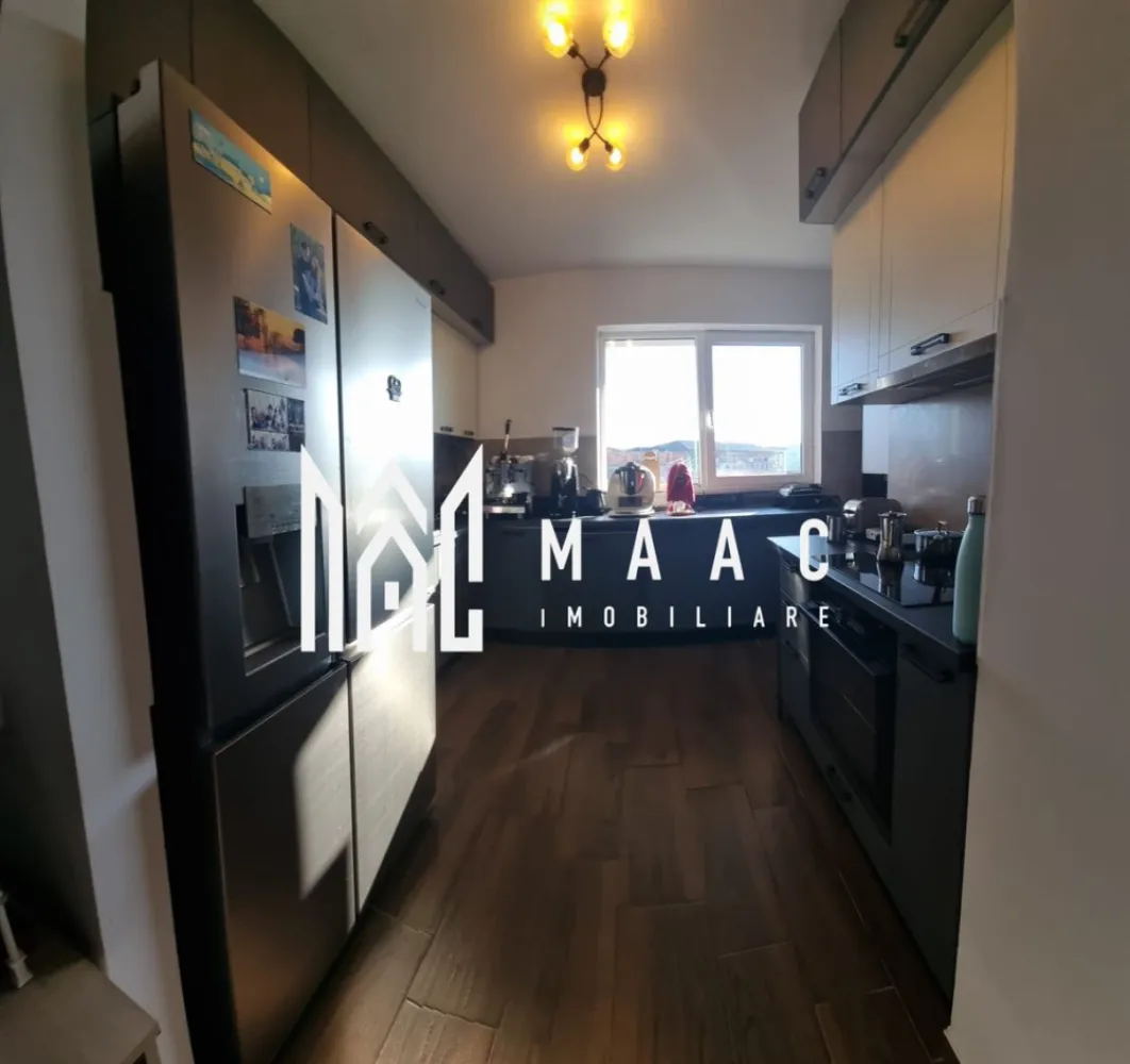 Apartament 3 camere | 93 mp utili+29mp terasa | Zona liniștită – Piata Rahovei - MAAC Imobiliare vă propune spre vânzare un apartament spațios și luminos, situat în una dintre cele mai bine cotate și liniștite zone ale Sibiului – Piața Rahovei, amplasat la etajul 3 al unui bloc nou, construcție 2023, realizat integral din beton monolit, cu regim de înălțime P+10, dotat cu 2 lifturi, parcare subterană și adăpost antiatomic.

Apartamentul are o suprafață utilă de 93 mp, la care se adaugă o terasă generoasă de 23 mp și două balcoane de câte 3 mp fiecare, oferind o priveliște spectaculoasă către lanțul muntos. Compartimentarea este excelentă, cu un living de dimensiuni ample, iar fiecare cameră beneficiază de acces direct la terasă sau balcon.

Compartimentare:
-hol intrare: 3,4 mp
-debara: 1,0 mp
-loc de luat masa: 10,6 mp
-cameră de zi: 30,8 mp
-bucătărie: 9,7 mp
-cămară: 0,6 mp
-WC: 2,7 mp
-dormitor matrimonial: 14,6 mp
-sas: 3,6 mp
-baie: 4,1 mp
-dormitor: 11,4 mp

Avantaje majore:
-3 camere decomandate
-2 băi, ambele dotate cu duș
-terasă de 23 mp și 2 balcoane
-acces exterior din fiecare cameră
-bloc solid din beton, izolat termic
-2 lifturi și casă a scării spațioasă
-spații de depozitare la demisol
-adăpost antiatomic
-posibilitate achiziționare parcare subterană

Finisaje și dotări:
-ușă de intrare metalică
-uși interioare celulare
-tâmplărie PVC
-pereți finisați cu vopsea lavabilă și faianță
-pardoseli din parchet rezistent la apă și trafic intens, gresie în bucătărie și băi
-contorizare separată pentru apă, căldură și curent

Utilități:
-curent electric
-apă
-canalizare
-CATV
-fibră optică
-interfon și supraveghere video
-parcare privată delimitată cu bariere

Zona oferă acces rapid către piața agroalimentară Piața Rahovei, școală, grădiniță, farmacii, magazine diverse și Supeco, la aproximativ 10 minute de centrul comercial Șelimbăr și la 2 minute de stația de autobuz, fiind o zonă foarte bine cotată și liniștită.

Apartamentul se vinde nemobilat dar contra cost se poate vinde ca in poze.

Pentru mai multe detalii și programarea unei vizionări vă rugăm să menționați la telefon numărul CP2898570.