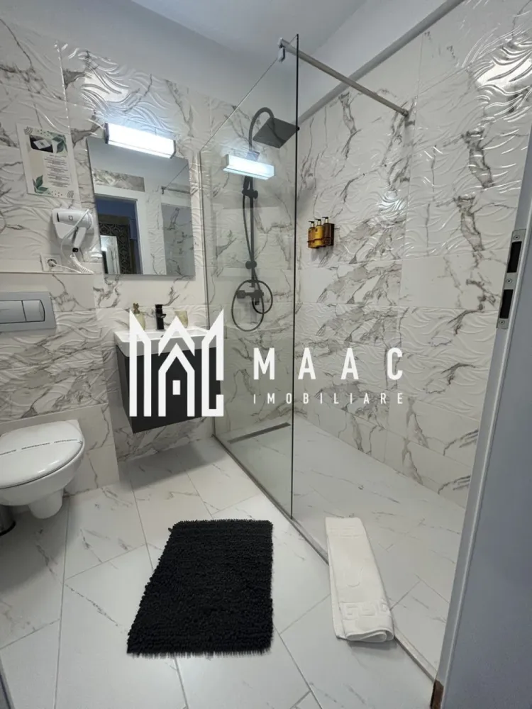 Apartamente 2 Camere | 40Mp | Balcon | Loc de Parcare | Cartierul Henri Coandă - MAAC Imobiliare vă propune spre vânzare un apartament modern cu 2 camere, situat în cartierul Henri Coandă din Sibiu, într-o zonă rezidențială aflată în plină dezvoltare, apreciată pentru liniște, acces facil către oraș și comunitatea rezidențială în continuă formare. Proprietatea reprezintă o alegere potrivită atât pentru locuință personală, cât și pentru investiție imobiliară, datorită poziționării într-un cartier modern și a nivelului ridicat de amenajare.

Apartamentul este amenajat la standarde premium și se vinde complet mobilat și utilat, fiind pregătit pentru mutare imediată sau pentru introducerea rapidă în circuitul de închiriere. Spațiul interior este gândit pentru confort și funcționalitate, cu finisaje moderne, mobilier de calitate superioară și un ambient elegant care oferă un spațiu luminos și primitor.

Dotări și beneficii:
-încălzire în pardoseală
-aer condiționat
-bucătărie complet utilată (plită electrică, frigider și electrocasnice)
-televizoare în fiecare cameră
-mobilier modern de calitate superioară
-loc de parcare inclus

Interiorul apartamentului este amenajat într-un stil modern și elegant, cu atenție la detalii și materiale de calitate, oferind un nivel ridicat de confort pentru viitorii proprietari. Compartimentarea și dotările îl fac potrivit atât pentru utilizare imediată, cât și pentru exploatarea eficientă ca investiție.

Proprietatea este potrivită pentru:
-închiriere pe termen lung
-regim hotelier
-locuință personală

Datorită poziției în cartierul Henri Coandă, una dintre zonele rezidențiale aflate în dezvoltare din Sibiu, apartamentul reprezintă o oportunitate atractivă pentru cumpărătorii care caută o locuință modernă sau o investiție sigură pe piața imobiliară locală.

Bonus: primele apartamente vândute vor beneficia de spațiu de depozitare la subsol, ideal pentru depozitarea obiectelor personale sau sezoniere.

Proprietățile bine amenajate din această zonă se vând rapid, motiv pentru care recomandăm programarea unei vizionări din timp pentru a descoperi avantajele acestei proprietăți.

Pentru mai multe informații și programări la vizionare, vă rugăm să ne contactați telefonic și să menționați CP2955537.