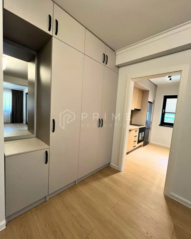Apartament Premium 2 Camere | Zonă Semicentrală | Parcare - Amplasat într-o zonă semicentrală foarte bună, apartamentul oferă acces rapid către toate punctele de interes: magazine, farmacii, școli, grădinițe, parcuri și stații de transport în comun. Aveți tot ce vă trebuie la câteva minute distanță, fără a renunța la liniștea și confortul de acasă.

Compartimentare & Design Interior:
Interiorul impresionează printr-un design modern și armonios, în nuanțe neutre deschise, completate de textura caldă a lemnului și accente elegante de gri deschis. Materialele sunt de calitate superioară, iar mobilierul este nou, ales cu atenție pentru un ambient rafinat.

Livingul: Luminos, creează un spațiu aerisit și primitor.

Bucătăria: Separată, complet mobilată și utilată – perfectă pentru cei care preferă un spațiu distinct pentru gătit.
Dormitorul: Intim și relaxant, dotat cu pat matrimonial, noptiere moderne și aplice cu lumină ambientală pentru un plus de confort și stil.
Baia: Finisată cu foarte mult bun gust, dispune de plăci ceramice care imită lemnul în zona chiuvetei și a dușului, oferind un efect vizual cald și sofisticat.
Balcon: Atât livingul, cât și bucătăria au ieșire directă pe balcon.

Confort & Beneficii incluse:
Eficiență termică: Sistem de încălzire prin pardoseală, asigurând un confort uniform și costuri optimizate.
Dotări: Electrocasnice moderne și mobilier nou, de înaltă calitate.

Parcare securizată: Loc de parcare inclus în curtea interioară a imobilului, dotată cu poartă automatizată.

Condiții de închiriere:
Preț chirie: 550 Euro / lună.
Loc de parcare: inclus în preț.
Garanție: Contravaloarea a 2 luni de chirie.

Comision agenție: 50% din prima lună de chirie.

Un apartament ideal, cu acces facil către tot ce contează. Pentru detalii suplimentare și programarea unei vizionări, vă invităm să ne contactați!
