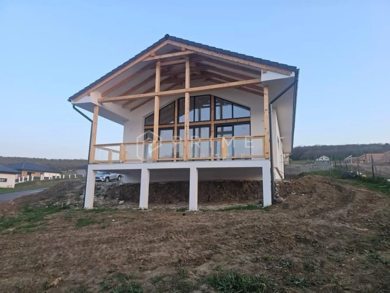 Vilă chalet modern cu perete panoramic de sticlă - Livezeni, Mureș - Vă prezentăm la vânzare o casă individuală cu design chalet contemporan, situată într-un cartier rezidențial aerisit din Livezeni, județul Mureș. Construcția impresionează prin peretele panoramic de sticlă pe toată înălțimea șarpantei, care inundă livingul cu lumină naturală și oferă o priveliște deschisă spre dealurile împrejmuitoare.
Planul interior se desfășoară pe un singur nivel, cu o configurație gândită pentru confort și funcționalitate: 
bucătărie cu living open-space, trei dormitoare generoase, două băi, dressing și cămară. 
Terasa acoperită de 25 m², cu balustradă din sticlă și lemn, prelungește natural spațiul de locuit spre exterior.
Podul este podit și poate fi utilizat ca spațiu de depozitare suplimentar, un avantaj rar în construcțiile noi.
Izolație superioară · eficiență energetică ridicată
Exterior termoizolat cu polistiren expandat de 15 cm; interior izolat cu spumă poliuretanică aplicată în strat continuu — eliminarea punților termice și consum redus de energie pe tot parcursul anului.
Proprietatea se vinde la stadiu semifinisat avansat. 

La Prime Properties, fiecare tranzacție înseamnă mai mult decât o simplă achiziție – este un proces complet, în care colaborăm cu cei mai buni profesioniști: notari, avocați, designeri, arhitecți, evaluatori, specialiști în certificate energetice, consultanți de credite imobiliare.
Astfel, atunci când alegi o proprietate prin noi, primești la pachet și siguranță, transparență și servicii impecabile pe tot parcursul drumului tău către casa ideală.
Ne dedicăm 100% fiecărui client, iar asta se reflectă în rezultate și în încrederea pe care o primim înapoi prin recomandările lor.
Proprietatea aceasta nu se potrivește exact nevoilor tale?
Lasă-ne să îți găsim alternativa potrivită. Agentul nostru îți va oferi soluții avantajoase și adaptate stilului tău de viață.
📞 Contactează-ne astăzi. Până acum nu am dezamăgit niciun client – și nu vom începe cu tine.
Comision 0% pentru cumpărători