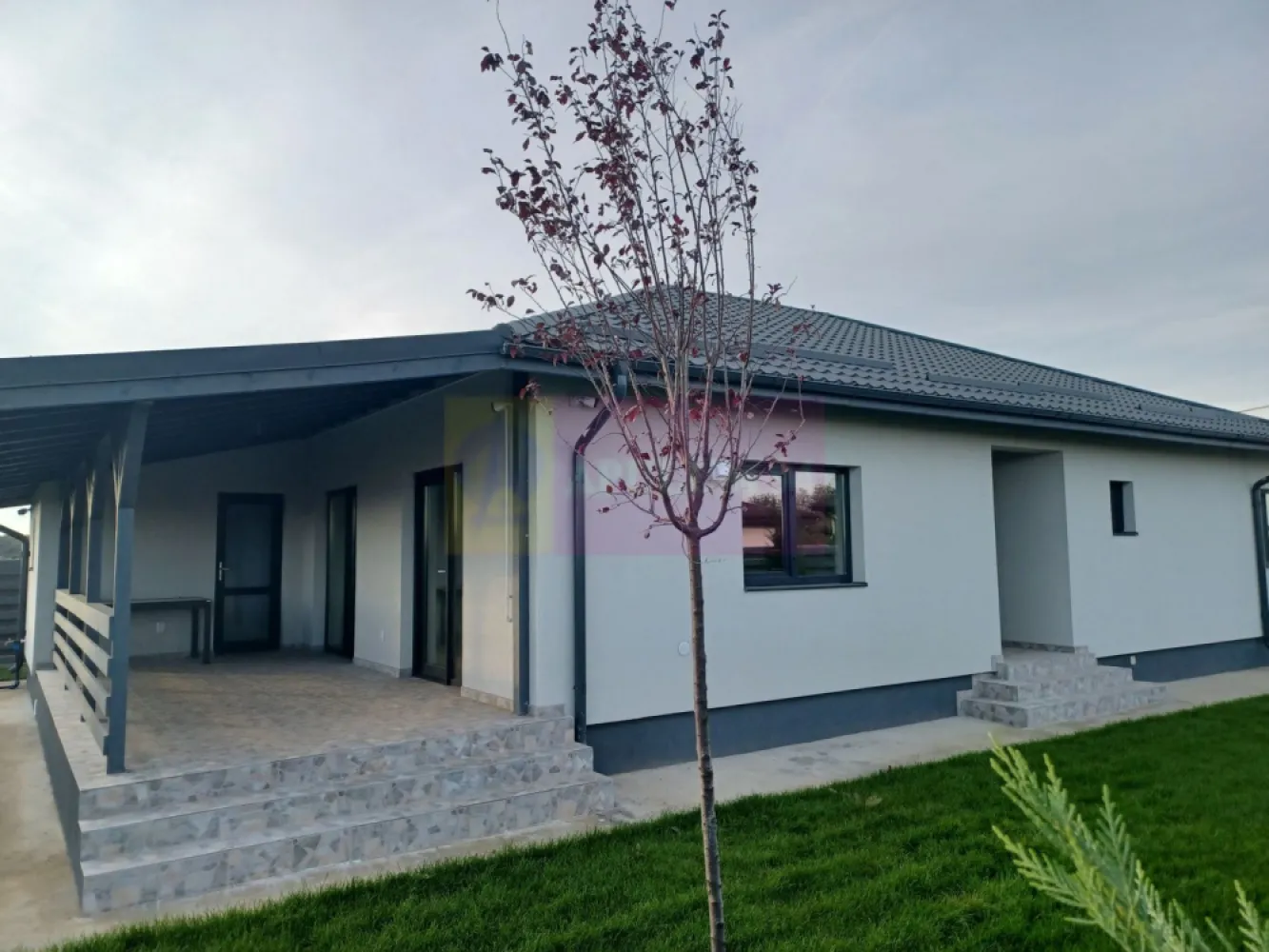 Casă nouă parter 162 mp, curte 504 mp, Săbăreni - Imobilul se află in localitatea Săbăreni, în apropierea celor 2 păduri, într-o zonă rezidențială nouă, ferită de traficul rutier, la aproximativ 200 m de strada Principală, DJ 602. Este o casă tip parter, cu structura de rezistență din beton armat și zidărie din căramidă, tencuită atât pe interior cât si pe exterior, peste care s-a aplicat polistiren de 150 mm si tencuiala decorativă Kober. Casa este acoperită cu țiglă metalică mată, ferestrele sunt Salamander cu geamuri tripan. Casa are placă din beton armat peste parter, podul este înalt, izolat termic cu celuloză, cu fereastră tip Velux. Locuința beneficiază de încălzire în pardoseală, centrală termică pe gaze în condensație. Finisajele interioare pot fi alese de cumpărător, intr-un anumit buget convenit cu vânzatorul. Casa are 3 dormitoare, living, bucătărie (18 mp), 2 băi, dresing, hol, cameră tehnică, pivniță si terasă acoperită. Imaginile din prezentare sunt de la o casă vândută. Termen de finalizare, la cheie Februarie 2026. Pret 157.000 EUR, cu TVA 21% inclus. Nu se plătește comision.