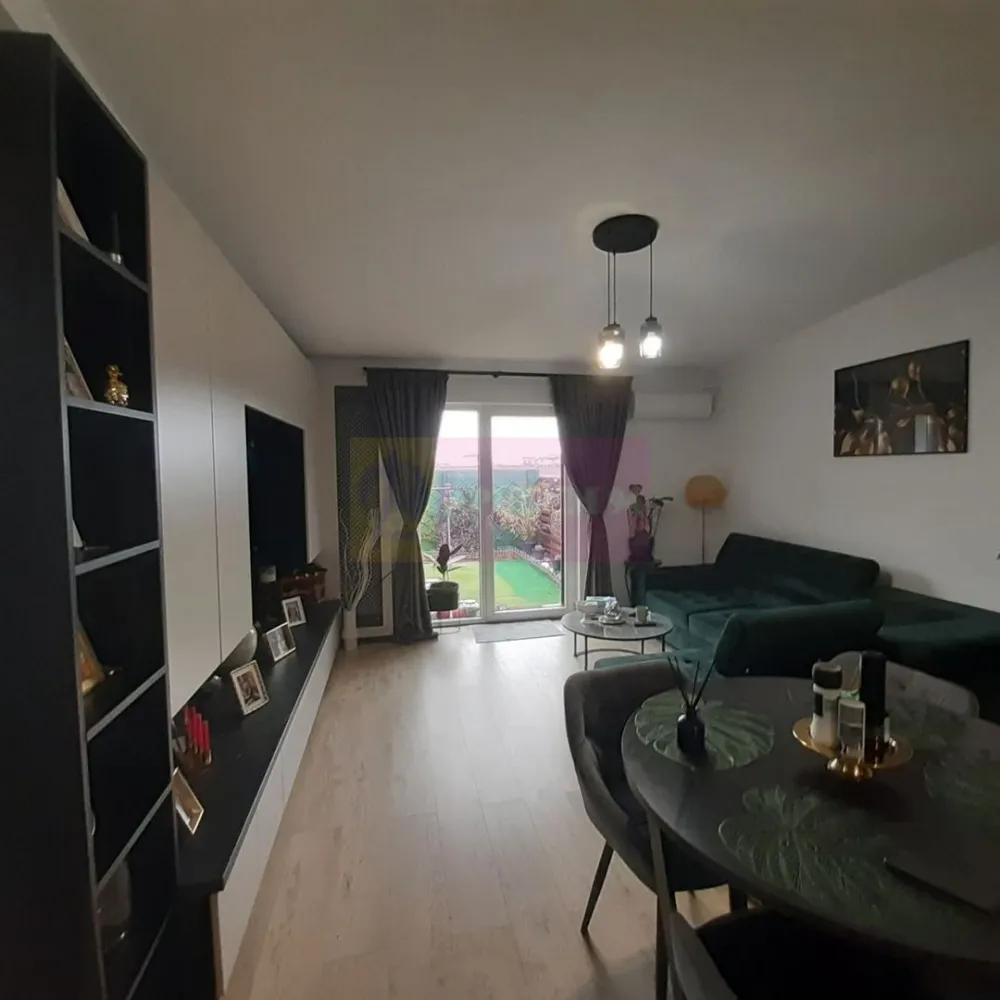 Casă pe Parter în Măgurele, aproape de București - Apulum94 vă prezintă un imobil frumos, casă situată într-un cartier nou din Măgurele, este un imobil pe model englezesc, casă într-un complex de mai multe case înșuruite, casă lângă casă, foarte aproape de București foarte aproape de joncțiunea localităților Măgulele și Bragadiru, cu acces facil din București zona Teiuș - Antiaeriană- Alexandriei, din Pucheni sau din DNCB - Centura București. Casa face parte dintr-un complex rezidențial nou, oferă un maxim de confort din punct de vedere termic și energetic la costuri mici tuturor celor care locuiesc aici fiind o casă dispusă doar pe parter iar curtea din spatele casei se poate personaliza după bunul gust al fiecăruia și folosi pentru orice activitate doriți. Avem o compartimentare plăcută a casei cu acces in zona de socializare care este deschisă și include atât zona de gătit cât și zona de servit masa. dar și o zonă de loisir și socializare. Avem o bucătărie cu mobilier modern, cu un design modern și foarte practică cu insulă și electrocasnice Electrolux incorporate, totul nou. Compartimentarea este foarte bine gândită astfel încât cei care locuiesc în imobil se bucură de un confort maxim, zona de parcare este foarte aproape de intrarea în casă iar la intrare în casă avem zona de gătit prevăzută cu spațiile aferente de depozitare optimizând astfel fluxul uzual de alimentare cu cele necesare este un trai confortabil și sănătos. Living-ul spațios permite acces rapid spre dormitoare și grupul sanitar dar și spre curtea din spate (English Backyard-ul aferent caselor construite pe model englezesc). Zona de odihnă este reprezentată de cele două dormitoare ideale ca suprafață, între ele fiind amplasată baia prevăzută cu cabină de duș tip Walk-in, prevăzută deasemenea cu spații de depozitare. Grădina este și ea frumos organizată pe mai multe zone, avem spațiu pentru grătar, o zonă de socializare acoperită cu mobilier de grădină și o zonă liberă perfectă pentru un loc de joacă, bricolat sau ring de dans funcție de nevoi și de starea de zi cu zi celor care se bucură de imobil. Tot în grădină se află să o mică cămară care este perfectă pentru depozitare și activități de bricolaj. Finisajele casei sunt foarte plăcute iar costurile de întreținere și cu utilitățile sunt la nivelul costurilor pentru o garsonieră. Documentația este la zi. Pentru mai multe detalii și programarea de vizionări nu ezitați să ne contactați. La vizionare se semnează un formular de vizionare și este necesar să aveți la dumneavoastră actele de identitate. La prețul afișat mobilierul de bucătărie este inclus. Vă așteptăm cu drag să vă mutați în acest imobil și să duceți alături de cei dragi o viață de basm.