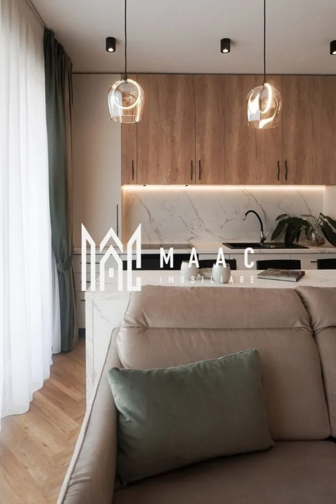 Apartament Premium | 3 camere | Balcon | Garaj subteran | Turnișor - MAAC vă propune spre închiriere un apartament premium cu 3 camere, conceput într-un stil minimalist și funcțional, unde confortul, eleganța și atenția la detalii se îmbină perfect pentru a oferi un spațiu ideal de locuit.

Apartamentul dispune de un living generos cu bucătărie open-space, amenajată modern și echipată cu hotă puternică cu evacuare exterioară, perfectă pentru un plus de confort și eficiență. Zona de zi este completată de o canapea extensibilă, ideală atât pentru relaxare, cât și pentru oaspeți.

Locuința beneficiază de două dormitoare luminoase, două băi finisate premium și mobilier realizat integral la comandă, inclusiv saltelele, pentru un nivel ridicat de confort și un design unitar, modern și rafinat.

Încălzirea se realizează prin pardoseală, cu centrală proprie și termostat individual în fiecare cameră, inclusiv în băi, oferind un control optim al temperaturii și eficiență energetică. Orientarea sud-estică asigură lumină naturală pe tot parcursul zilei.

Unul dintre punctele forte ale proprietății este balconul generos de 10 mp, care poate fi amenajat în funcție de nevoile și preferințele viitorului chiriaș. Proprietarii sunt deschiși la sugestii pentru a transforma experiența locuirii într-una cât mai plăcută.

Apartamentul beneficiază și de loc de parcare în garajul subteran, iar accesul se face într-un ansamblu rezidențial modern și liniștit, cu multă zonă verde, pomi fructiferi, loc de joacă pentru copii, zonă de fitness, spații de relaxare, zonă de grătar și fire pit.

În plus, proprietatea are ieșire către o curte interioară amenajată cu zonă de fructe și legume, flori, arbuști decorativi și spațiu de relaxare, unde se poate oferi acces, dacă se dorește.

Poziționarea este excelentă, într-o zonă liniștită, cu acces facil către magazine precum Profi și Trans Agape, stații de autobuz, zona industrială și aeroport, aflate la aproximativ 5 minute cu mașina, iar centrul orașului și Piața Mare se află la doar 15 minute distanță.

Un apartament ideal pentru cei care își doresc un stil de viață modern, confortabil și echilibrat, într-un cadru verde și liniștit.

Pentru mai multe detalii și vizionări, vă rugăm să menționați ID : CP3081929