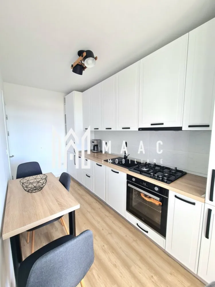 Apartament 2 camere | 57 Mp | Loc de Parcare | 2 Balcoane | Henri Coanda - MAAC Imobiliare vă propune spre vânzare un apartament modern cu 2 camere, complet mobilat și utilat, situat într-un ansamblu rezidențial liniștit, construit în anul 2020.

Apartamentul are o suprafață utilă de 57 mp și este amplasat la etajul 1 al unui imobil prevăzut cu lift și boxe de depozitare la subsol. Proprietatea se remarcă prin starea impecabilă, fiind foarte curată, îngrijită și pregătită pentru mutare imediată, fără investiții suplimentare.

Compartimentarea este practică și confortabilă:
living generos și luminos;
bucătărie separată, mobilată la comandă și complet utilată cu plită pe gaz, cuptor electric și mașină de spălat vase;
dormitor matrimonial;
cameră transformată în dressing room, amenajată cu mobilier realizat la comandă și mașină de spălat rufe;
baie cu cadă;
2 balcoane.

Apartamentul se vinde complet mobilat și utilat, împreună cu loc de parcare inclus.

Ansamblul rezidențial beneficiază de o poziționare excelentă, într-o zonă aerisită și în continuă dezvoltare, având în imediata apropiere stație de autobuz și viitorul magazin Kaufland aflat în construcție, ceea ce oferă proprietății un potențial foarte bun de valorificare.

Pentru mai multe detalii sau pentru programarea unei vizionări, vă rugăm să ne contactați specificând ID:CP3064295