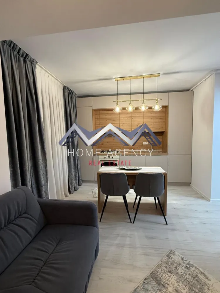 Apartament 2 camere | Otopeni central | include parcare - Vă propunem, spre închiriere, un apartament modern cu 2 camere, situat într-un ansamblu rezidențial nou, ideal pentru cei care își doresc confort, funcționalitate și un ambient elegant.

Locuința beneficiază de o compartimentare practică și aerisită, fiind compusă dintr-un hol lung de acces prevăzut cu dressing generos, living luminos cu bucătărie open-space complet mobilată și utilată, dormitor spațios, baie modernă și balcon generos, perfect pentru relaxare.

Apartamentul este complet mobilat și utilat, cu finisaje moderne și mobilier atent ales pentru a crea un spațiu primitor și funcțional. Zona de living oferă un ambient confortabil, iar bucătăria este integrată armonios în spațiu, fiind dotată cu electrocasnice și multiple spații de depozitare. Dormitorul este spațios și elegant amenajat, iar baia impresionează prin designul modern și finisajele de calitate. În prețul chiriei este inclus și un loc de parcare suprateran, un avantaj important pentru confortul zilnic.

Apartamentul este ideal pentru o persoană sau un cuplu care își dorește o locuință modernă, gata de mutare, într-o zonă liniștită și cu acces rapid către principalele puncte de interes, magazine, DN1, Aeroport etc.

Programează acum o vizionare!