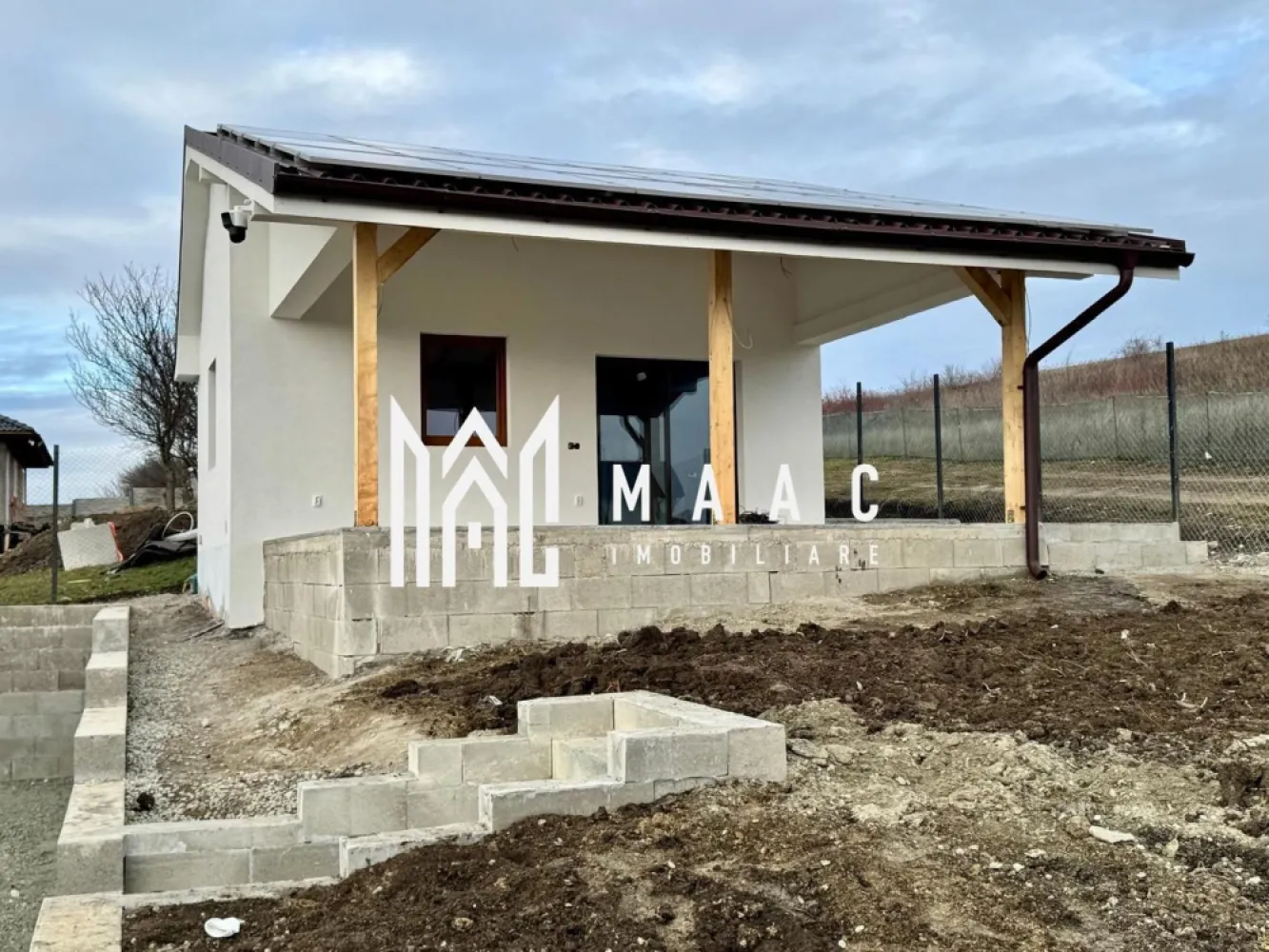 Casă individualăI I 115 mp utili I Teren 536 mp I Șura Mare - MAAC Imobiliare va propune spre vanzare o casă modernă individuală situată în Șura Mare, cu o suprafață utilă de 115 mp și un teren de 536 mp, poziționată într-o zonă liniștită, cu priveliște deosebită spre Sibiu și lanțul montan, vizibilă atât din livingul panoramic, cât și de pe terasa casei. Imobilul este structurat pe demisol, parter și mansardă, fiind compartimentat astfel: Demisol: cameră tehnică, baie, spațiu pentru pivniță si încăpere multifuncțională (bucătărie de vară, birou, hobby room sau depozitare). Parter: living open-space cu bucătărie, dormitor, baie, hol și scară interioară pentru acces la mansarda. Mansardă: 2 dormitoare, ambele cu acces pe terasă, hol, baie, spații de depozitare si terasă exterioară cu priveliște panoramică către munți. Casa dispune de un sistem fotovoltaic complet, care asigură alimentarea întregului sistem electric: panouri fotovoltaice: 10,5 kW, baterii de stocare: 20 kW, invertoare: 12 kW si instalație electrică completă: tablouri, siguranțe, prize, întrerupătoare, lămpi exterioare. Dotări și facilități: 2 sisteme de climatizare de 18.000 BTU fiecare, centrală pe peleți cu automatizare,încălzire în pardoseală la parter și mansarda, boiler 200 litri si sistem de supraveghere video. Construcție și finisaje: demisol din beton, parter și mansardă din cărămidă și structură de lemn, izolație exterioară cu polistiren si terasă finisată cu gresie și balustradă din sticlă. Utilități: apă, canalizare (fosă septică) si curent – alimentare din sistemul fotovoltaic. Casa se poate preda la stadiul actual, conform pozelor, sau există posibilitatea de finisare la cheie, în funcție de preferințele cumpărătorului. Proprietatea este ideală pentru cei care își doresc o locuință modernă, eficientă energetic, cu costuri reduse de întreținere, într-o zonă aerisită, aproape de Sibiu, cu o priveliște rar întâlnită. O casă potrivită atât pentru locuire permanentă, cât și ca investiție pe termen lung. Casa se află în imediata apropiere de: Prima Shopping Center, grădinițe și școli,mijloace de transport în comun,restaurante și magazine. Proprietatea este ideală pentru o familie care își dorește confort, liniște și acces rapid către oraș, într-un cadru modern și bine organizat. Pentru mai multe detalii si programarea unei vizionari va rugam sa specificati ID: CP2880444. }}