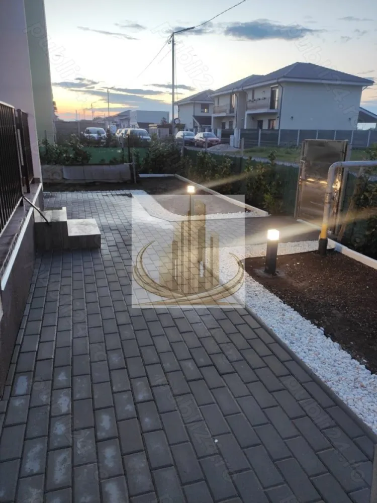 Ap cu 2 cam și curte proprie de 115 mp, Giroc | Bloc nou | Investitie - Echipa Grand Mobilis Imobiliare vă propune spre vânzare o proprietate cu adevărat specială, un apartament care reușește să combine perfect confortul unui apartament modern cu intimitatea și atmosfera unei case, datorită curții proprii generoase și amenajării atent gândite.

Situat la parterul unui imobil nou construit în anul 2022, apartamentul impresionează prin designul contemporan, finisajele premium și atenția la detalii, fiecare spațiu fiind amenajat cu materiale de calitate și mult bun gust.

Locuința este decomandată și beneficiază de o compartimentare extrem de practică și echilibrată:

hol generos de acces;
living luminos și primitor;
bucătărie închisă, separată;
dormitor spațios;
baie modern amenajată.

Încă de la intrare, apartamentul transmite senzația unui spațiu elegant, cald și aerisit, ideal pentru cei care își doresc un cămin modern, gata de mutare imediată. Proprietatea se vinde complet mobilată și utilată, exact cum se prezintă.

Confortul termic este asigurat prin intermediul centralei proprii și al încălzirii în pardoseală, oferind un plus de confort și eficiență energetică.

Elementul care transformă această proprietate într-una rară pe piață este curtea proprie de aproximativ 115 mp, amenajată cu atenție pentru a crea un adevărat spațiu de relaxare privat. Curtea este frumos întreținută și dispune de:

gazon;
plante ornamentale;
pietriș decorativ;
pavaj;
zone ideale pentru relaxare și petrecerea timpului în aer liber.

În plus, în curte regăsim și o căsuță cu utilități trase, perfectă pentru depozitare, hobby sau amenajarea unui spațiu suplimentar multifuncțional.

Proprietatea beneficiază și de 2 locuri de parcare înscrise în CF, un avantaj extrem de important pentru confortul cotidian.

Un alt aspect rar întâlnit este faptul că accesul în apartament se poate face atât prin interiorul blocului, cât și direct din curtea proprie, oferind intimitate și senzația autentică de locuință tip casă.

Poziționarea completează perfect această proprietate:

zonă liniștită și aerisită;
magazine, restaurante și cafenele în apropiere;
școală, grădiniță, creșă și liceu;
mijloace de transport în comun;
acces rapid către principalele artere ale orașului;
centura ocolitoare la aproximativ 10-12 minute distanță.

Acest apartament este alegerea ideală pentru o familie sau un cuplu care își dorește mai mult decât o simplă locuință — un spațiu modern, elegant și intim, unde confortul interior se îmbină perfect cu avantajele unei curți generoase.

Totodată, proprietatea reprezintă și o oportunitate excelentă de investiție, datorită cererii ridicate pentru închiriere în zonă și a caracteristicilor rare pe care le oferă. 

Pentru mai multe detali sau programarea unei vizionari, echipa Grand Mobilis Imobiliare va sta la dispozitie! 
ID Intern: CP3106818