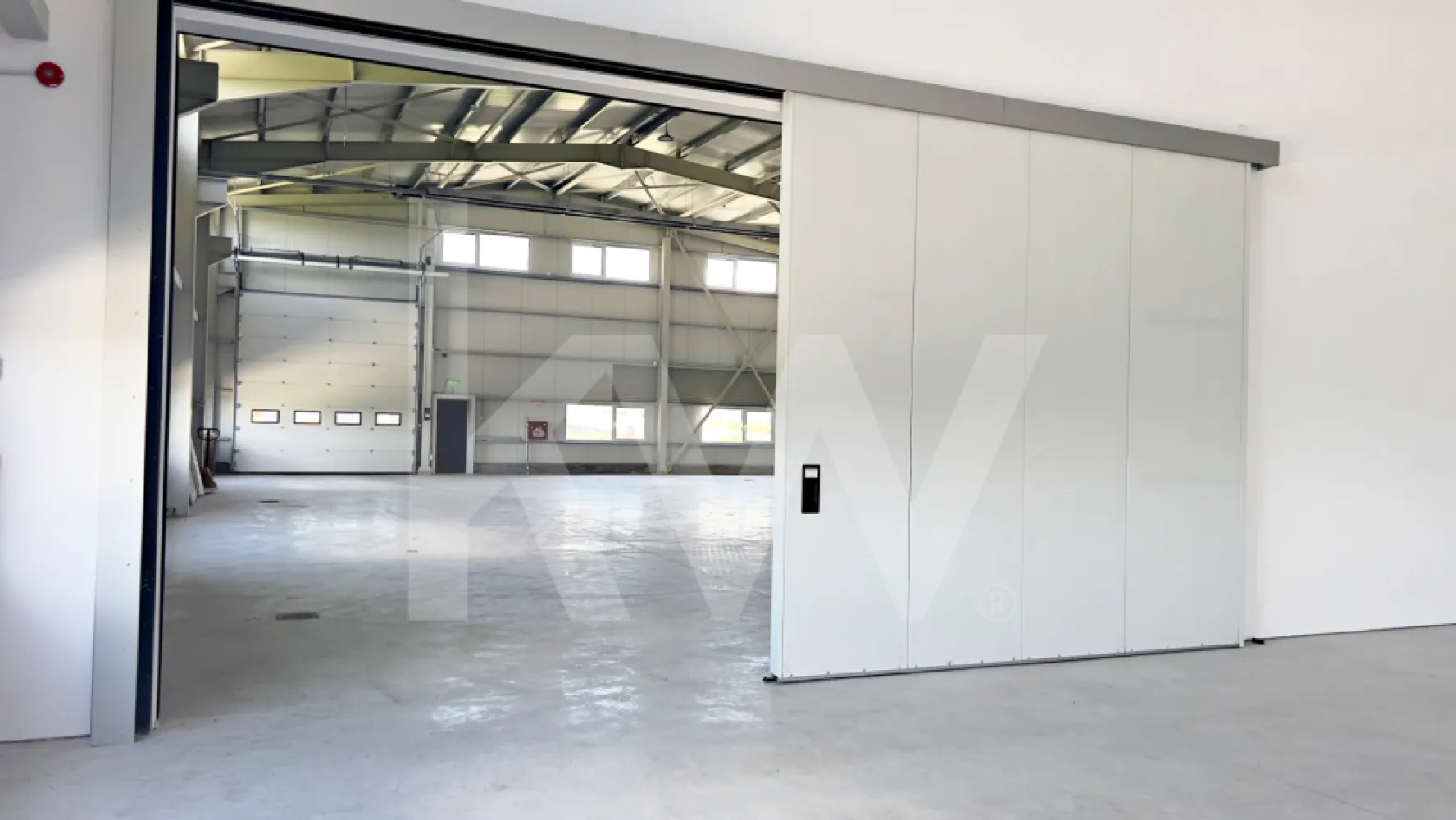 DE ÎNCHIRIAT — Hală producție/depozitare + birouri. Parcul Industrial Vest-Sibiu - DE ÎNCHIRIAT — Hală producție/depozitare + birouri | Parcul Industrial Vest, Sibiu | 2026

O hală nouă arată diferit. Aceasta chiar arată diferit.

Dacă ai văzut destule hale cu pereți mucegăiți, pardoseli crăpate și birouri improvizate dintr-un container, oprește-te aici. Această proprietate a fost construită în 2026, la un standard pe care îl vei vedea imediat la prima vizionare — și pe care îl vei simți în costurile de operare în fiecare lună.

LOCAȚIE
Parcul Industrial Vest, Sibiu
2 km față de centura orașului | 5 min de aeroport | Fără restricții de tonaj | Acces direct TIR 

CE ÎNCHIRIEZI
HALA — ~960 mp utili  (două nave comunicante: ~535 + ~425 mp)
- Înălțime liberă utilă minimă: 6,10 m | Înălțime la coamă: 8,4 m
- Structură cadre metalice, pereți panouri sandwich 100 mm (REI 15)
- Pardoseală beton elicopterizat cu inserție quartz — standard DIN 18202
- 2 uși drive-in electrice L 4,2 ml × H 4,5 ml + ușă de comunicare între nave (3,5 × 3,5 m)
- Iluminat LED high-bay
- Încălzire prin tuburi radiante pe gaz — sistem eficient energetic pentru volume mari
- Sistem automat de desfumare prin ferestre acționate mecanic
- Hidranți interiori și exteriori

BIROURI — ~360 mp (parter + etaj parțial)
- Finisaje complete: SPC tarkett și gresie, vopsea lavabilă
- Încălzire în pardoseală + centrale pe gaz cu puffere TESY (sistem dublu, independent pentru fiecare aripă)
- Aer condiționat split în toate birourile
- Grupuri sanitare separate femei/bărbați — finisate cu plăci mari format marmură
- Sală de mese/bucătărie echipată (mobilier inclus)
- Vestiare separate femei/bărbați
- Cameră tehnică dedicată

EXTERIOR
- Platformă exterior totală: ~2.600 mp — pavaj + asfalt frezat copactat rezistent la trafic TIR
- Acces circular TIR în jurul clădirii
- 10 locuri de parcare
- Împrejmuire perimetrală metalică H=2 m | CCTV
- Copertină de acces la intrarile principale

UTILITĂȚI
- Energie electrică: 200 kW putere aprobată | Trafo propriu 250 kVA | Subcontorizare separată pe cele două corpuri
- Gaze naturale: racordate, contorizare separată (1 contor principal + 4 subcontoare)
- Apă: rețea municipală
- Canalizare: fosă septică industrială proprie + separator de hidrocarburi
- Internet fibră optică: în curs de racordare (negocieri în desfășurare cu operatorul)

 SITUAȚIE JURIDICĂ
- Autorizație ISU: în curs de finalizare

CONDIȚII COMERCIALE
- Chirie: 8.900 EUR/lună + TVA (hală + birouri, pachet complet)
- Contract minim: 3 ani
- Garanție: echivalent 2 luni chirie
- Posibilitate personalizare spațiu (fit-out) — se discută de la caz la caz
- Nu se închiriază separat hala de birouri

 POTRIVIT PENTRU
Producție ușoară și medie | Asamblare | Logistică și distribuție | Service tehnic | Depozitare

*Nu se acceptă: reciclare deșeuri, colectare fier vechi, procesare chimică grea.

Vizionare: disponibilă imediat, cu programare.
Contact: Caius Giurgiu | [0790823369]

