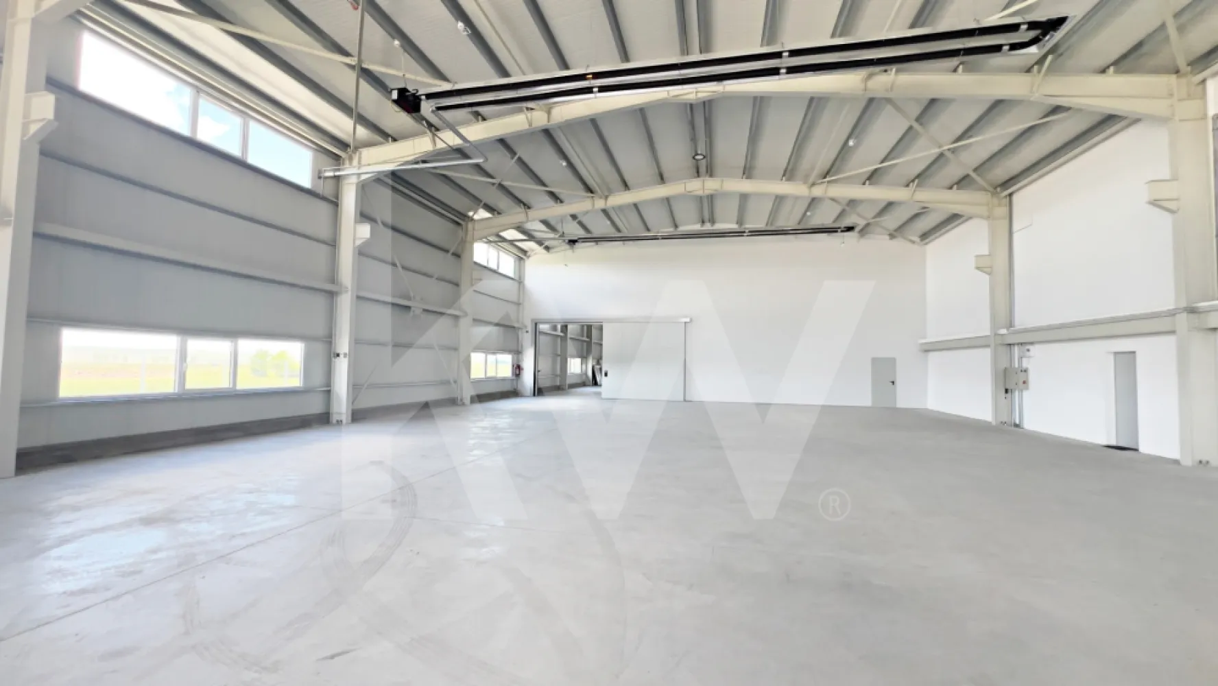 DE ÎNCHIRIAT — Hală producție/depozitare + birouri. Parcul Industrial Vest-Sibiu - DE ÎNCHIRIAT — Hală producție/depozitare + birouri | Parcul Industrial Vest, Sibiu | 2026

O hală nouă arată diferit. Aceasta chiar arată diferit.

Dacă ai văzut destule hale cu pereți mucegăiți, pardoseli crăpate și birouri improvizate dintr-un container, oprește-te aici. Această proprietate a fost construită în 2026, la un standard pe care îl vei vedea imediat la prima vizionare — și pe care îl vei simți în costurile de operare în fiecare lună.

LOCAȚIE
Parcul Industrial Vest, Sibiu
2 km față de centura orașului | 5 min de aeroport | Fără restricții de tonaj | Acces direct TIR 

CE ÎNCHIRIEZI
HALA — ~960 mp utili  (două nave comunicante: ~535 + ~425 mp)
- Înălțime liberă utilă minimă: 6,10 m | Înălțime la coamă: 8,4 m
- Structură cadre metalice, pereți panouri sandwich 100 mm (REI 15)
- Pardoseală beton elicopterizat cu inserție quartz — standard DIN 18202
- 2 uși drive-in electrice L 4,2 ml × H 4,5 ml + ușă de comunicare între nave (3,5 × 3,5 m)
- Iluminat LED high-bay
- Încălzire prin tuburi radiante pe gaz — sistem eficient energetic pentru volume mari
- Sistem automat de desfumare prin ferestre acționate mecanic
- Hidranți interiori și exteriori

BIROURI — ~360 mp (parter + etaj parțial)
- Finisaje complete: SPC tarkett și gresie, vopsea lavabilă
- Încălzire în pardoseală + centrale pe gaz cu puffere TESY (sistem dublu, independent pentru fiecare aripă)
- Aer condiționat split în toate birourile
- Grupuri sanitare separate femei/bărbați — finisate cu plăci mari format marmură
- Sală de mese/bucătărie echipată (mobilier inclus)
- Vestiare separate femei/bărbați
- Cameră tehnică dedicată

EXTERIOR
- Platformă exterior totală: ~2.600 mp — pavaj + asfalt frezat copactat rezistent la trafic TIR
- Acces circular TIR în jurul clădirii
- 10 locuri de parcare
- Împrejmuire perimetrală metalică H=2 m | CCTV
- Copertină de acces la intrarile principale

UTILITĂȚI
- Energie electrică: 200 kW putere aprobată | Trafo propriu 250 kVA | Subcontorizare separată pe cele două corpuri
- Gaze naturale: racordate, contorizare separată (1 contor principal + 4 subcontoare)
- Apă: rețea municipală
- Canalizare: fosă septică industrială proprie + separator de hidrocarburi
- Internet fibră optică: în curs de racordare (negocieri în desfășurare cu operatorul)

 SITUAȚIE JURIDICĂ
- Autorizație ISU: în curs de finalizare

CONDIȚII COMERCIALE
- Chirie: 8.900 EUR/lună + TVA (hală + birouri, pachet complet)
- Contract minim: 3 ani
- Garanție: echivalent 2 luni chirie
- Posibilitate personalizare spațiu (fit-out) — se discută de la caz la caz
- Nu se închiriază separat hala de birouri

 POTRIVIT PENTRU
Producție ușoară și medie | Asamblare | Logistică și distribuție | Service tehnic | Depozitare

*Nu se acceptă: reciclare deșeuri, colectare fier vechi, procesare chimică grea.

Vizionare: disponibilă imediat, cu programare.
Contact: Caius Giurgiu | [0790823369]
