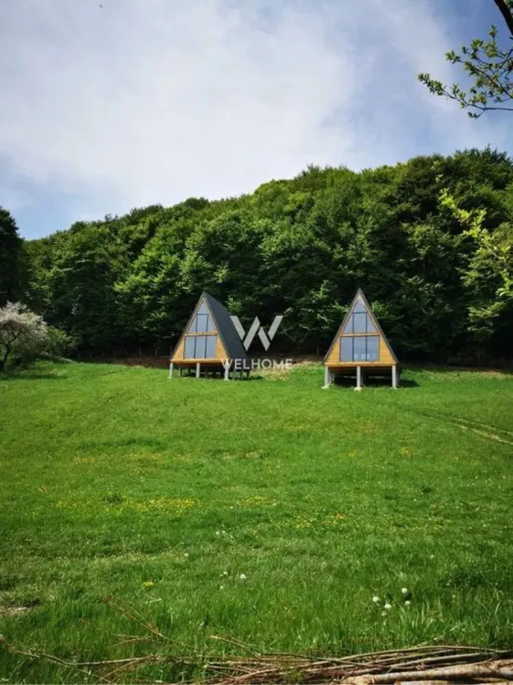 Teren cu cabane A-Frame și priveliște către Munții Făgăraș - Se vinde teren intravilan de 5.129 mp, situat la ieșirea din Bradu, într-o zonă retrasă și liniștită, cu priveliște spectaculoasă spre Munții Făgăraș și pădure în spate. Acces facil, aproape de drum, fără trafic sau zgomot. Pe proprietate se află: 2 cabane tip A-Frame (22 mp parter + 11 mp dormitor în mansardă) băile neamenajate parchet din lemn masiv disponibil filigorie de aprox. 75 mp, complet echipată (grătar, chiuvetă, mese, bănci) Utilități: apă pe teren, curent trifazic tras până la cabane (necesită panou), gaz în apropiere. Terenul este ideal pentru investiție turistică, retreat-uri sau casă de vacanță, având potențial excelent de extindere (cabane, ciubăr, saună). O proprietate specială, pentru cei care caută liniște, natură și acces rapid către Sibiu, Păltiniș, Valea Avrigului și atracțiile din zonă. Detalii și vizionări: 0743030351 }}