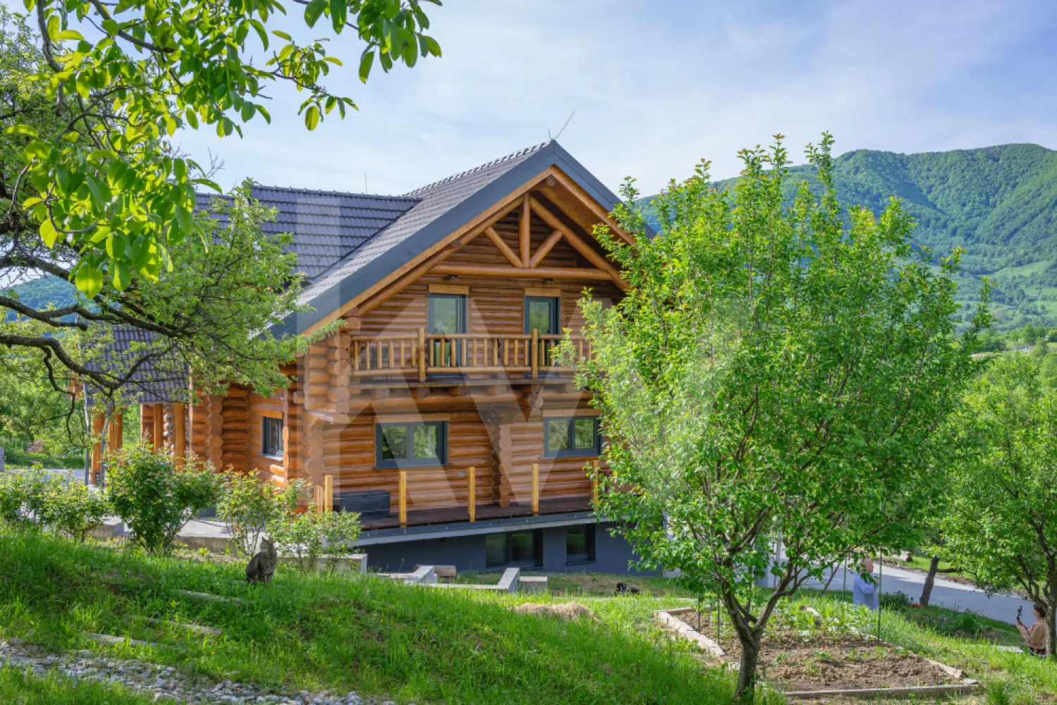 Stil de viață de vânzare – liniște, natură și confort premium - Unele proprietăți sunt cumpărate pentru numărul de metri pătrați.
Altele… pentru felul în care te fac să respiri.

Aceasta nu este doar o casă de vânzare.
Este o oportunitate rară de stil de viață.
Un refugiu creat pentru oamenii obosiți de zgomot, grabă și beton, pentru cei care visează să se trezească înconjurați de liniște, aer curat, priveliști deschise și natură cât vezi cu ochii.
Construită din bușteni masivi de lemn de 40 cm, proveniți exclusiv din păduri europene certificate și tratați împotriva îmbătrânirii, proprietatea emană căldură, autenticitate și acel sentiment greu de descris pe care doar o casă cu adevărat specială îl poate oferi.
Aici, fiecare dimineață se simte diferit.
Lumina naturală atinge delicat lemnul, sunetele naturii te înconjoară, iar timpul pare să încetinească… suficient cât să îți amintească ce înseamnă cu adevărat să trăiești frumos.
Casa este gândită generos și inteligent:
Subsol – 136 mp
Garaje duble cu porți electrice, cameră tehnică, cameră de duș, spații foarte generoase de depozitare, zonă de lounge, cămară și un atelier/birou cu acces direct în curte — locul perfect pentru creativitate, relaxare sau propriul refugiu privat.
Parter – 138 mp
Un impresionant Great Room de aproximativ 50 mp, cu galerie deschisă și tavan înalt ce evidențiază spectaculoasa structură din bușteni, centrat în jurul unui șemineu elegant și al luminii naturale, un hol generos, toaletă și dressing, două camere interconectate de 17 mp și o spectaculoasă bucătărie de 37 mp cu acces direct către terasa de 70 mp — locul unde serile devin amintiri.
Etaj
Două dormitoare spațioase de aproximativ 17 mp fiecare, plus un dormitor matrimonial de 28 mp. Proprietatea include o baie pentru oaspeți de 10 mp, precum și o baie en-suite de 8 mp pentru dormitorul matrimonial, dotată cu o cabină de duș dublă și sistem tip rain shower. Toate dormitoarele beneficiază de balcoane private cu priveliști spectaculoase către munții din jur.
Impresionanta galerie deschisă are aproximativ 30 mp și include suplimentar o zonă de birou de 9 mp.

Confortul modern completează perfect farmecul natural:

 încălzire în pardoseală la parter și etaj
 calorifere în subsol
 sistem fotovoltaic de 12,5 kW cu baterii de stocare și circuit bidirecțional
 proprietatea este conectată și la rețeaua principală de electricitate
 boiler de 1500 L pentru apă caldă menajeră cu sistem de filtrare
 alimentare cu gaz prin rezervor de 1000 L
 rezervor de apă de 7000 L, ideal pentru irigarea grădinii și situații de urgență
 proprietatea este conectată la rețeaua publică de apă și canalizare

Iar afară… povestea devine și mai frumoasă.

 Suprafață totală teren: 5.683 mp
 Aproximativ 5.003 mp spațiu verde liber
 Aproximativ 620 mp curte pavată
 Mică oază de apă
 Grădină de legume
 Intimitate completă, liniște și un cadru natural spectaculos

Și poate cel mai special element al proprietății:
 un Pub privat de 20 mp — un spațiu autentic unde serile cu prietenii, muzica bună și conversațiile memorabile capătă un farmec aparte.

Toate acestea la doar câteva minute de agitația orașului…
dar suficient de departe încât să poți auzi cu adevărat liniștea.

Aceasta nu este pur și simplu o casă.
Este locul unde înveți din nou să trăiești încet.
Să îți bei cafeaua fără grabă.
Să asculți ploaia căzând peste lemn.
Să privești apusul fără să îți verifici telefonul.

Un colț rar de lume, creat pentru oamenii care înțeleg că adevăratul lux înseamnă spațiu, natură, liniște și libertate.