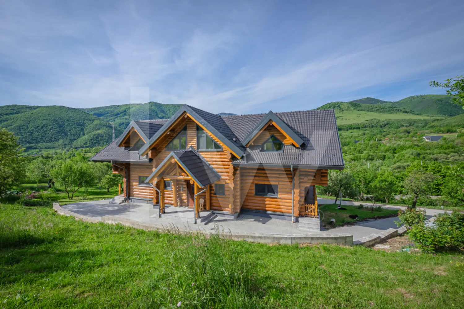 Stil de viață de vânzare – liniște, natură și confort premium - Unele proprietăți sunt cumpărate pentru numărul de metri pătrați.
Altele… pentru felul în care te fac să respiri.

Aceasta nu este doar o casă de vânzare.
Este o oportunitate rară de stil de viață.
Un refugiu creat pentru oamenii obosiți de zgomot, grabă și beton, pentru cei care visează să se trezească înconjurați de liniște, aer curat, priveliști deschise și natură cât vezi cu ochii.
Construită din bușteni masivi de lemn de 40 cm, proveniți exclusiv din păduri europene certificate și tratați împotriva îmbătrânirii, proprietatea emană căldură, autenticitate și acel sentiment greu de descris pe care doar o casă cu adevărat specială îl poate oferi.
Aici, fiecare dimineață se simte diferit.
Lumina naturală atinge delicat lemnul, sunetele naturii te înconjoară, iar timpul pare să încetinească… suficient cât să îți amintească ce înseamnă cu adevărat să trăiești frumos.
Casa este gândită generos și inteligent:
Subsol – 136 mp
Garaje duble cu porți electrice, cameră tehnică, cameră de duș, spații foarte generoase de depozitare, zonă de lounge, cămară și un atelier/birou cu acces direct în curte — locul perfect pentru creativitate, relaxare sau propriul refugiu privat.
Parter – 138 mp
Un impresionant Great Room de aproximativ 50 mp, cu galerie deschisă și tavan înalt ce evidențiază spectaculoasa structură din bușteni, centrat în jurul unui șemineu elegant și al luminii naturale, un hol generos, toaletă și dressing, două camere interconectate de 17 mp și o spectaculoasă bucătărie de 37 mp cu acces direct către terasa de 70 mp — locul unde serile devin amintiri.
Etaj
Două dormitoare spațioase de aproximativ 17 mp fiecare, plus un dormitor matrimonial de 28 mp. Proprietatea include o baie pentru oaspeți de 10 mp, precum și o baie en-suite de 8 mp pentru dormitorul matrimonial, dotată cu o cabină de duș dublă și sistem tip rain shower. Toate dormitoarele beneficiază de balcoane private cu priveliști spectaculoase către munții din jur.
Impresionanta galerie deschisă are aproximativ 30 mp și include suplimentar o zonă de birou de 9 mp.

Confortul modern completează perfect farmecul natural:

 încălzire în pardoseală la parter și etaj
 calorifere în subsol
 sistem fotovoltaic de 12,5 kW cu baterii de stocare și circuit bidirecțional
 proprietatea este conectată și la rețeaua principală de electricitate
 boiler de 1500 L pentru apă caldă menajeră cu sistem de filtrare
 alimentare cu gaz prin rezervor de 1000 L
 rezervor de apă de 7000 L, ideal pentru irigarea grădinii și situații de urgență
 proprietatea este conectată la rețeaua publică de apă și canalizare

Iar afară… povestea devine și mai frumoasă.

 Suprafață totală teren: 5.683 mp
 Aproximativ 5.003 mp spațiu verde liber
 Aproximativ 620 mp curte pavată
 Mică oază de apă
 Grădină de legume
 Intimitate completă, liniște și un cadru natural spectaculos

Și poate cel mai special element al proprietății:
 un Pub privat de 20 mp — un spațiu autentic unde serile cu prietenii, muzica bună și conversațiile memorabile capătă un farmec aparte.

Toate acestea la doar câteva minute de agitația orașului…
dar suficient de departe încât să poți auzi cu adevărat liniștea.

Aceasta nu este pur și simplu o casă.
Este locul unde înveți din nou să trăiești încet.
Să îți bei cafeaua fără grabă.
Să asculți ploaia căzând peste lemn.
Să privești apusul fără să îți verifici telefonul.

Un colț rar de lume, creat pentru oamenii care înțeleg că adevăratul lux înseamnă spațiu, natură, liniște și libertate.