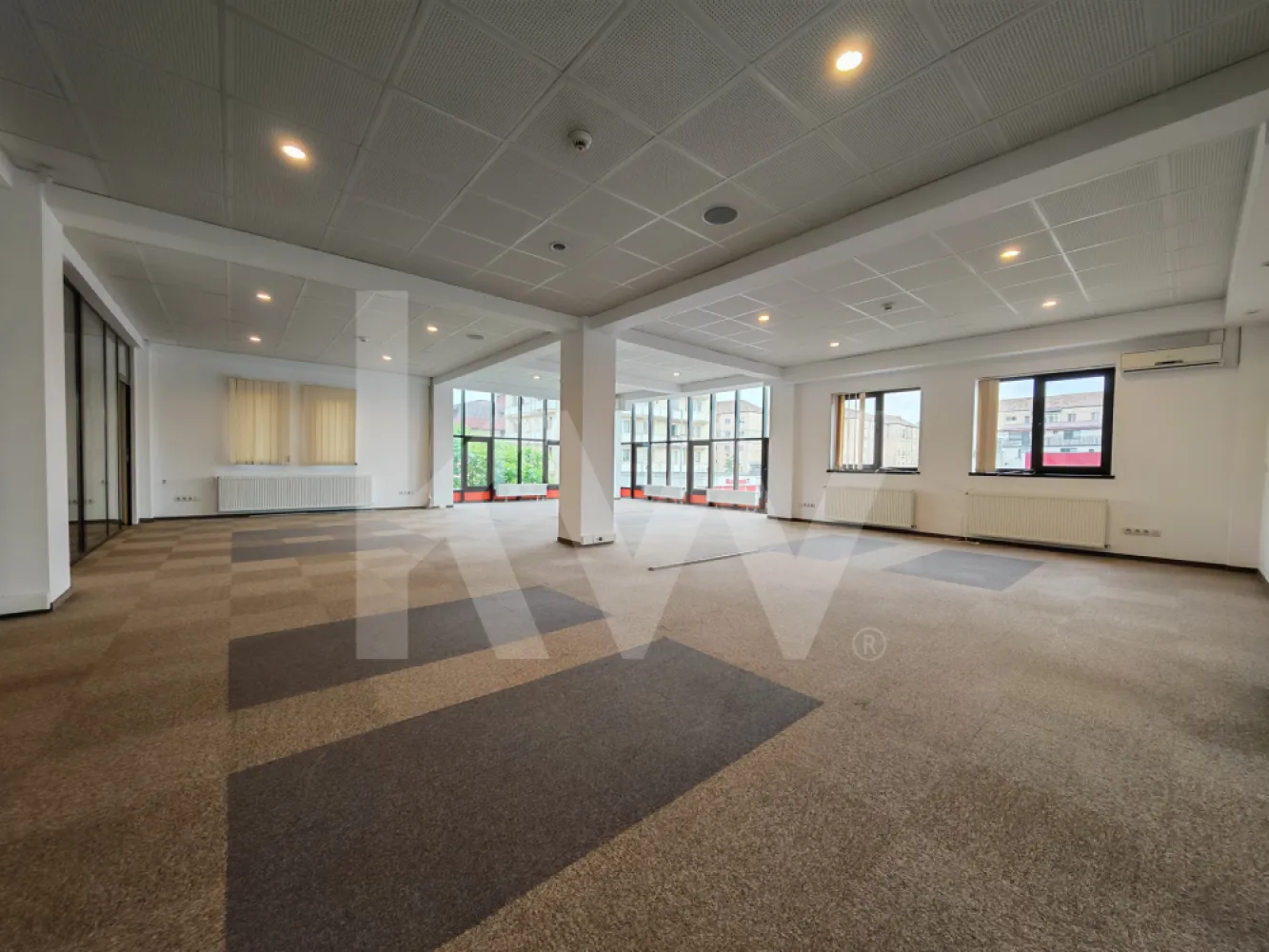 Spațiu de birouri luminos și modular – perfect pentru echipa ta! - Cauți un loc unde ideile bune să aibă spațiu să crească? Acest birou open-space combină perfect funcționalitatea cu o atmosferă aerisită și luminoasă. Cu compartimentări inteligente din sticlă și un design minimalist, oferă echilibrul ideal între transparență, colaborare și intimitate.

Ce îți va plăcea aici:

Compartimentare inteligentă: Zonă generoasă de open-space completată de birouri individuale sau săli de ședințe delimitate prin pereți eleganți de sticlă.

Lumină naturală din plin: Ferestrele mari și orientarea spațiului asigură o atmosferă caldă și productivă pe tot parcursul zilei.

Zonă de dining/chicinetă complet mobilată: O bucătărie modernă, utilată (mobilier gri/alb, chiuvetă din inox, spații mari de depozitare), ideală pentru pauzele de cafea și prânzul echipei.

Confort și utilități: Sistem de climatizare, corpuri de iluminat LED integrate în tavanul casetat, mochetă profesională de trafic intens și calorifere eficiente.

Facilități: Zonă de acces/scări curată, grupuri sanitare și finisaje moderne în nuanțe neutre de alb și gri.

Un spațiu curat, gata de personalizat, care își așteaptă viitoarea echipă!