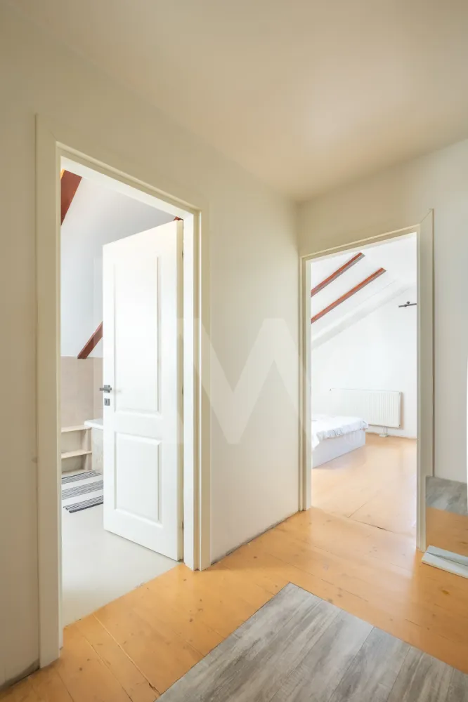 Apartament cu 3 camere, pod amenajat și 2 locuri de parcare - Se vinde apartament spațios situat la etajul 1 al unui imobil modern, completat de un pod amenajat care dublează utilitatea spațiului. Proprietatea are o suprafață utilă de 77 mp, este foarte bine iluminată natural și se predă cu două locuri de parcare supraterane incluse în preț.

Cum este compartimentat:

Etajul 1: Zonele sunt clar delimitate. Avem un living generos de tip open space, unit cu bucătăria, de unde se iese direct pe balconul exterior. Tot la acest nivel se află un hol de distribuție, cele două dormitoare și o baie mare, utilată complet atât cu cadă, cât și cu cabină de duș separată.

Podul amenajat: Accesul se face pe o scară interioară stabilă. Spațiul de la etaj este complet finisat, izolat și decorat elegant cu grinzi din lemn la vedere. Datorită ferestrelor Velux, zona este foarte luminoasă și poate fi folosită imediat ca al treilea dormitor, birou generos, zonă de joacă sau spațiu de relaxare.

Detalii tehnice și avantaje:

Suprafață utilă: 77 mp

Etaj: 1 + pod amenajat

Parcare: 2 locuri supraterane private

Confort sporit datorită structurii pe două niveluri, oferind intimitate fiecărui membru al familiei.

Proprietatea este ideală pentru locuit sau pentru investiție pe termen lung, fiind situată într-o zonă accesibilă.