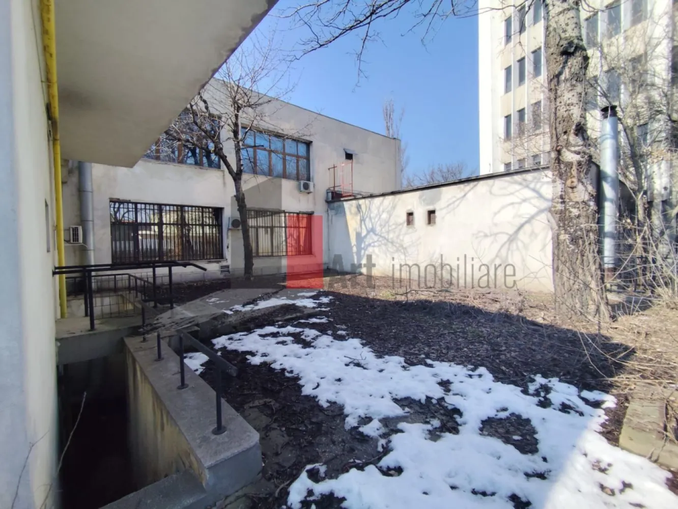 Comision 0% Spatiu comercial de inchiriat in Bucurestii Noi - Oportunitate Rara - Clădire emblematică în Bucureștii Noi – spațiu comercial de mari dimensiuni, disponibil pentru închiriere - Fara Comision / 0

Proprietate rar disponibilă pe piață, situată într-una dintre cele mai recunoscute clădiri din Bucureștii Noi, poziționată strategic într-un punct cu trafic pietonal și rutier ridicat. Imobilul reprezintă un reper al cartierului, fiind cunoscut de locuitori de peste 15 ani datorită funcționării sale continue ca sediu bancar. Vizibilitatea, notorietatea și poziționarea conferă spațiului o valoare comercială superioară, greu de găsit în zona de Nord-Vest a Capitalei.

Caracteristici generale ale proprietății

Clădirea este amplasată pe un teren de 1.292 mp, având o amprentă la sol de 473 mp și o suprafață desfășurată totală de 1.249 mp.
Construcția este dezvoltată pe trei niveluri – subsol, parter și etaj – toate utile, funcționale și compartimentate pentru activități diverse.

Datorită configurației, imobilul poate acomoda cu succes:
supermarket, clinici medicale, hub de birouri, showroom, unitate bancară, restaurant, sediu corporate, centru educațional, laborator, spațiu logistic ușor sau mix funcțional.

Detalierea suprafețelor și compartimentărilor
SUBSOL – 295 mp

Conceput pentru activități ce necesită securitate, depozitare sau subdivizări multiple. Include:

10 camere utilizabile individual;

spații tehnice și anexe funcționale;

coridoare generoase de circulație;

cameră tezaur construită la standarde bancare;

spațiu dedicat casetelor de valori, configurat pentru activități cu cerințe speciale de securitate.

Ideal pentru: arhivă, depozit logistic, laborator, zona tehnică, camere server, spații auxiliare.

PARTER – 368 mp

Nivel cu potențial comercial maxim, datorită vizibilității și accesului direct din bulevard. Cuprinde:

9 camere și încăperi ce pot fi adaptate în funcție de activitate;

zone de acces și fluxuri bine definite;

grupuri sanitare;

garaj integrat cu acces direct;

casa scării poziționată eficient, facilitând circulația între niveluri.

Parterul este potrivit pentru orice funcțiune cu contact direct cu publicul, având flux pietonal constant și posibilitate de vitrină extinsă.

ETAJ – 263 mp

Zona ideală pentru operaționale, birouri sau servicii. Structurat în:

7 camere spațioase;

încăperi anexe;

grupuri sanitare;

holuri ample, ce permit reorganizarea circulației interioare.

Poate fi transformat ușor într-o zonă administrativă, birouri pentru echipe, cabinete sau spații de lucru open-space.

Teren, acces și facilități exterioare

Parcare proprie, poziționată lateral, cu acces facil din bulevard.

În partea din spate a proprietății se află o suprafață generoasă ce poate fi amenajată în funcție de necesități:

extindere parcare,

zonă de încărcare/descărcare,

terasă pentru restaurant sau cafenea,

spațiu tehnic sau zonă verde.

Lotul permite extindere funcțională și personalizare în funcție de interesele chiriașului.

Nu se percepe comision