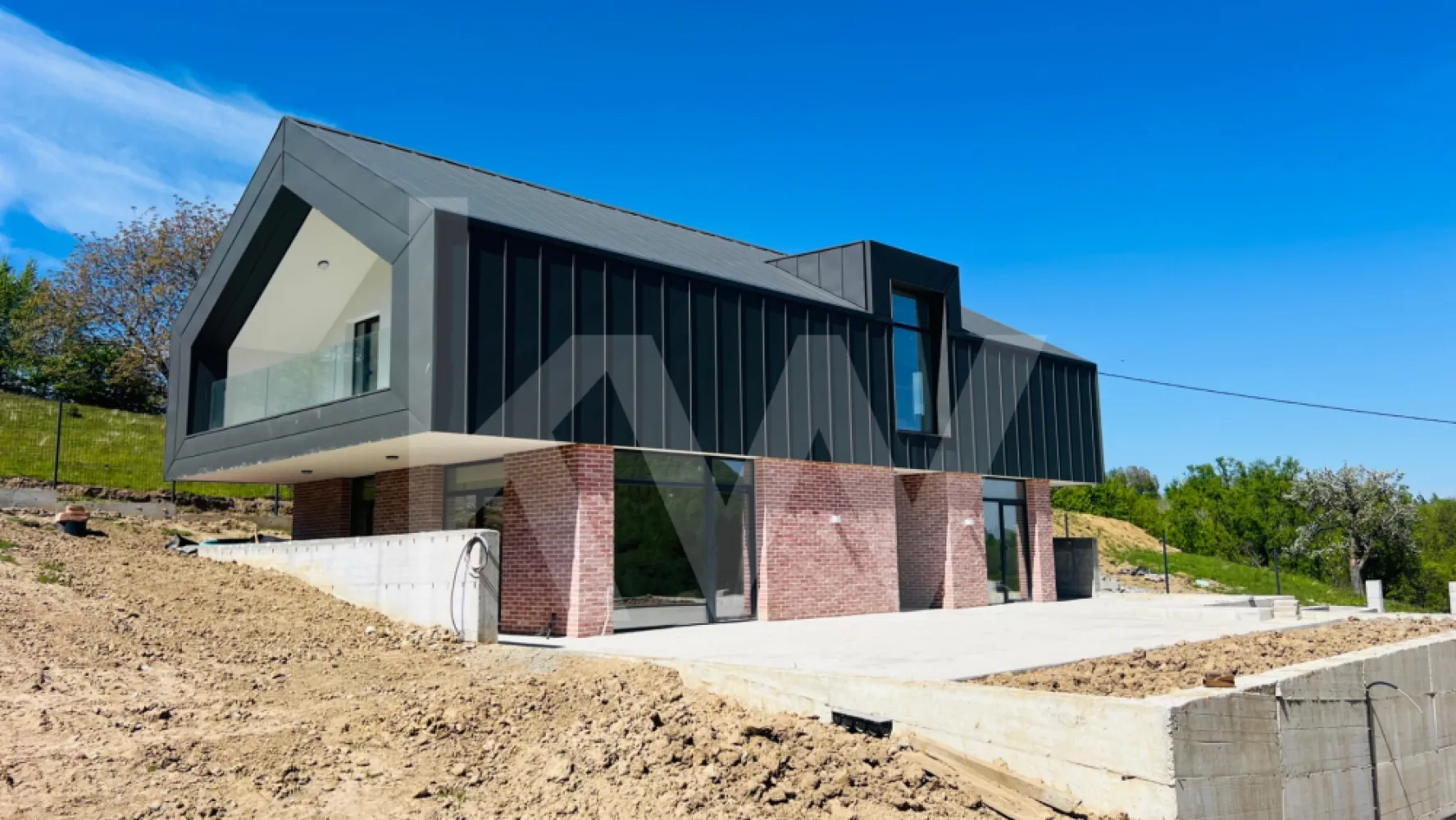 Casă arhitectură modernă cu panoramă spre Munții Făgăraș și Cetatea Cisnădioara - Descoperă o locuință unifamilială care îmbină armonios designul modern cu funcționalitatea inteligentă, situată într-o zonă deosebită, cu panoramă spectaculoasă spre Cetatea Cisnădioarei și Munții Făgăraș.

Această proprietate impresionează prin arhitectura contemporană, liniile curate și atenția la detalii, fiind construită cu materiale de calitate superioară și finisaje realizate cu grijă, pentru un confort durabil și un stil de viață modern.

Compartimentarea este gândită eficient, oferind spații generoase și bine delimitate. La parter, intrarea se deschide către un living luminos și primitor, ideal pentru momentele petrecute în familie. În partea dreaptă se află un birou versatil, cu acces direct către exterior, perfect pentru lucru de acasă sau activități creative. Casa scării este poziționată central, iar în proximitate se regăsesc baia și spațiul tehnic, discret integrate. Bucătăria, amplasată în continuarea zonei de zi, este practică și bine organizată, beneficiind de cămară proprie.

Etajul oferă intimitate și confort, fiind compartimentat în trei dormitoare, dintre care unul matrimonial, dotat cu dressing și baie proprie. În plus, există o baie suplimentară și o cameră de lucru, ideală pentru birou sau hobby-uri. Toate dormitoarele au acces către una dintre cele două logii spațioase, oferind deschidere către peisajul natural și lumină din plin.

Curtea, generoasă și aerisită, este complet împrejmuită și parțial pavată, fiind amenajată peisagistic cu bun gust. Elementele arhitecturale decorative, evidențiate prin iluminat ambiental cu bandă LED, creează un cadru elegant și relaxant, perfect pentru petrecerea timpului în aer liber.

Predarea imobilului se realizează la stadiul de glet interior, oferindu-ți libertatea de a personaliza finisajele finale după propriul gust.

Această proprietate reprezintă alegerea ideală pentru cei care caută un cămin modern, într-un cadru natural de excepție, fără compromisuri în ceea ce privește calitatea și confortul.

