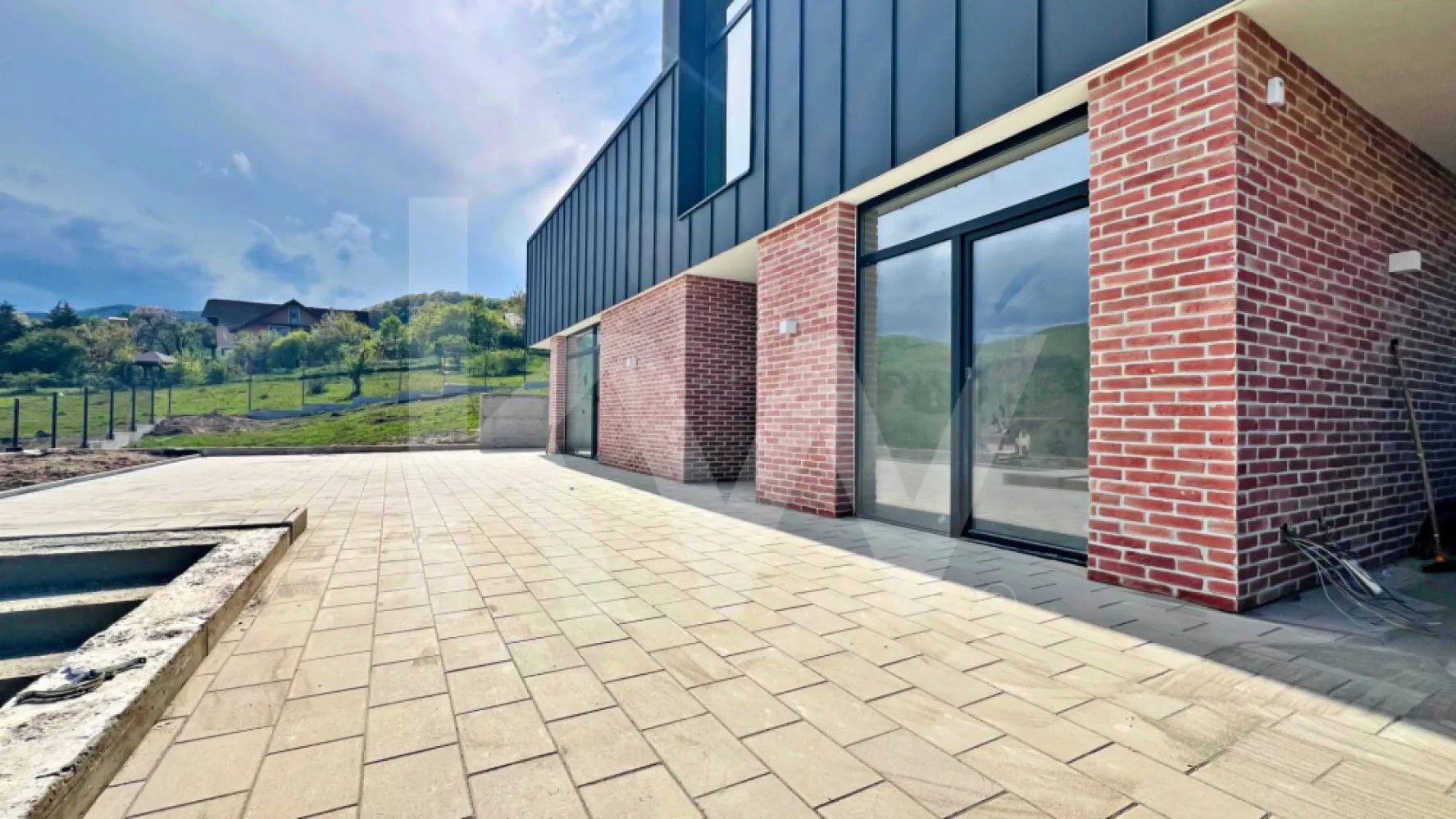 Casă arhitectură modernă cu panoramă spre Munții Făgăraș și Cetatea Cisnădioara - Descoperă o locuință unifamilială care îmbină armonios designul modern cu funcționalitatea inteligentă, situată într-o zonă deosebită, cu panoramă spectaculoasă spre Cetatea Cisnădioarei și Munții Făgăraș.

Această proprietate impresionează prin arhitectura contemporană, liniile curate și atenția la detalii, fiind construită cu materiale de calitate superioară și finisaje realizate cu grijă, pentru un confort durabil și un stil de viață modern.

Compartimentarea este gândită eficient, oferind spații generoase și bine delimitate. La parter, intrarea se deschide către un living luminos și primitor, ideal pentru momentele petrecute în familie. În partea dreaptă se află un birou versatil, cu acces direct către exterior, perfect pentru lucru de acasă sau activități creative. Casa scării este poziționată central, iar în proximitate se regăsesc baia și spațiul tehnic, discret integrate. Bucătăria, amplasată în continuarea zonei de zi, este practică și bine organizată, beneficiind de cămară proprie.

Etajul oferă intimitate și confort, fiind compartimentat în trei dormitoare, dintre care unul matrimonial, dotat cu dressing și baie proprie. În plus, există o baie suplimentară și o cameră de lucru, ideală pentru birou sau hobby-uri. Toate dormitoarele au acces către una dintre cele două logii spațioase, oferind deschidere către peisajul natural și lumină din plin.

Curtea, generoasă și aerisită, este complet împrejmuită și parțial pavată, fiind amenajată peisagistic cu bun gust. Elementele arhitecturale decorative, evidențiate prin iluminat ambiental cu bandă LED, creează un cadru elegant și relaxant, perfect pentru petrecerea timpului în aer liber.

Predarea imobilului se realizează la stadiul de glet interior, oferindu-ți libertatea de a personaliza finisajele finale după propriul gust.

Această proprietate reprezintă alegerea ideală pentru cei care caută un cămin modern, într-un cadru natural de excepție, fără compromisuri în ceea ce privește calitatea și confortul.

