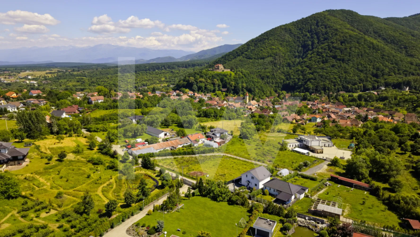 Teren 1340 mp în Cisnădioara – Cu Vedere la Cetatea Medievală și Munții Făgăraș - Imaginează-ți cum te trezești în fiecare dimineață cu Munții Făgăraș la orizont și cu o cetate medievală de peste 800 de ani veghind dealul din fața ta. Acest teren de 1340 mp, situat în Cisnădioara — una dintre cele mai pitorești și autentice localități din Mărginimea Sibiului — îți oferă exact această priveliște, în fiecare zi.
De pe parcelă se vede direct Cetatea Cisnădioarei, una dintre cele mai vechi și mai bine conservate biserici fortificate din Transilvania, ridicată în stil romanic la finalul secolului al XII-lea. Pe lângă valoarea istorică, dealul cetății oferă o panoramă spectaculoasă spre Munții Cibinului și culmile Făgărașului — exact priveliștea de care te vei bucura și tu, direct din curtea casei tale.
Caracteristicile terenului:
Cu o formă dreptunghiulară și acces printr-o stradă privată, terenul este intravilan, cu destinație pentru construcția unei case, vile sau pensiuni — liniște și intimitate garantate, fără vecini gălăgioși sau trafic. Beneficiezi deja de apă curentă direct pe parcelă, un avantaj important pentru orice proiect de construcție. Infrastructura este pregătită pentru dezvoltare: există deja o conductă de canalizare de 65 mm pe teren, fiind necesară doar montarea unei mini-stații de pompare pentru racordarea completă. Gazul și curentul electric sunt prezente în apropiere, cu posibilitate de extindere — îți poți planifica racordările exact după nevoile proiectului tău.
De ce Cisnădioara?
Pentru cei din București care își doresc o evadare reală din agitația capitalei, Cisnădioara este alegerea perfectă: un sat sătesc cu sute de ani de istorie, la doar 10 km de Sibiu și 17 km de Aeroportul Internațional Sibiu (zboruri directe din București). Te bucuri de liniștea muntelui, de trasee de drumeție și ciclism la doar câteva sute de metri de poartă, dar ai la îndemână tot ce oferă un oraș cultural important — restaurante, magazine, evenimente, școli.
Fie că vrei o casă de vacanță în care să te retragi din weekend în weekend, o reședință permanentă într-un decor de poveste, sau o investiție inteligentă într-o zonă cu potențial turistic în continuă creștere, acest teren are toate ingredientele unei povești de viață frumoase.
Preț: 139.900 euro, negociabil.
Locurile cu o astfel de poveste și priveliște nu apar des pe piață. Programează o vizionare și descoperă personal frumusețea acestui loc.
 Contact: 0790823369

