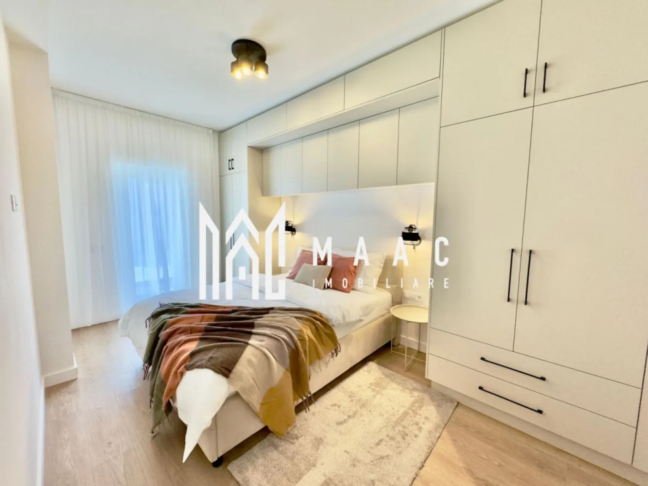 Apartament 2 camere | 53,55 MPU | Balcon | Loc de parcare - MAAC Imobiliare vă propune spre vânzare un apartament cu 2 camere în Sibiu, situat în Ansamblul Rezidențial într-o zonă aerisită, cu acces rapid către Zona Industrială Vest și principalele puncte de interes din oraș.

Apartamentul are suprafață utilă de 53,55 mp și balcon tip logie de 7,29 mp, orientat spre sud, oferind lumină naturală pe tot parcursul zilei.
Locuința este potrivită atât pentru locuit, cât și pentru investiție imobiliară în Sibiu.

Detalii apartament

Suprafață utilă: 53,55 mp
Balcon: 7,29 mp
Încălzire în pardoseală
Compartimentare practică
Vedere deschisă
Loc de parcare inclus
Compartimentare
Hol de acces
Living
Bucătărie
Dormitor
Baie
Balcon 

Opțiuni de predare

Apartamentul poate fi predat în funcție de preferințele cumpărătorului, existând mai multe variante disponibile:

Predare la alb – finisaje de bază realizate, pregătit pentru personalizarea interioară
Predare la cheie – complet finisat, gata pentru mutare
Predare complet mobilat și utilat – locuință pregătită pentru mutare imediată sau pentru investiție în închiriere

A. Locație avantajoasă pentru un apartament nou în Sibiu

Acces rapid către Zona Industrială Vest
Conexiune rapidă către principalele artere ale orașului
Zonă rezidențială aerisită, ferită de trafic intens
Acces facil către magazine, servicii și zone comerciale
Timp redus de deplasare către locul de muncă sau centrul orașului

B. Eficiență energetică și dotări

Încălzire în pardoseală
Centrală termică în condensare
Tâmplărie PVC cu 5 camere și 3 foi de sticlă
Jaluzele electrice exterioare
Aer condiționat inclus
Balcon finisat cu granit și balustradă din sticlă securizată
Izolație exterioară cu vată bazaltică
Casa scării placată cu granit
Fațadă decorată cu larice siberian și piatră naturală

C. Spații verzi și confort în ansamblu

45% din suprafață destinată spațiilor verzi
Sistem automatizat de irigație
Arbori ornamentali maturi
Vedere panoramică spre munți
Orientare sudică pentru balcoane

4 căi de acces în ansamblu
Locuri de joacă pentru copii
Drumuri complet pavate
Locuri de parcare incluse
Ansamblu rezidențial cu densitate redusă a construcțiilor

 Pentru informații suplimentare, menționează codul ID: CP2956277