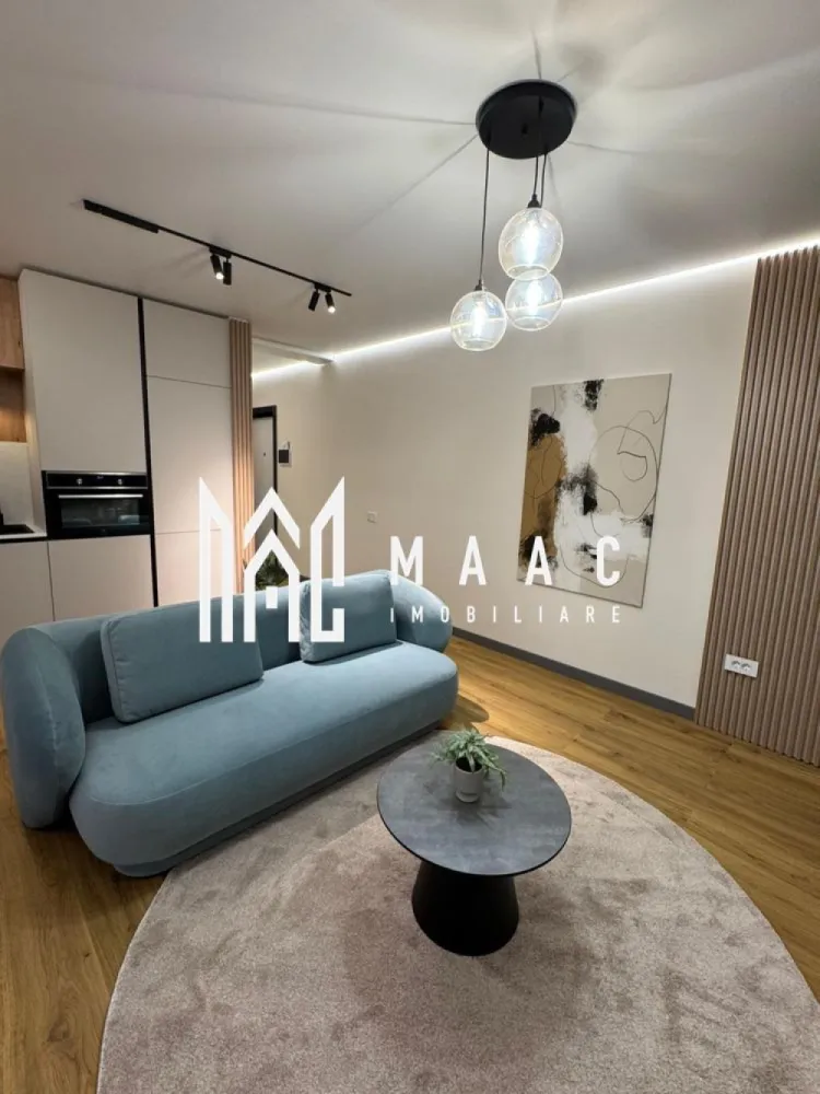 Apartament 2 camere | Etaj 1 | Prima inchiriere | Strand - MAAC Imobiliare oferă spre închiriere un apartament modern cu 2 camere, balcon, loc de parcare și boxă pentru depozitare, situat într-un imobil nou și elegant din zona Ștrand.

Apartamentul are o suprafață utilă de 52 mp (62 mp construiți) și este amplasat la etajul 1 din 4 al unui bloc construit în anul 2025, din cărămidă, izolat termic și dotat cu lift.

Locuința beneficiază de o compartimentare eficientă și funcțională, fiind compusă din:

living generos open-space cu bucătărie complet mobilată și utilată;
balcon cu acces din zona de zi;
dormitor spațios;
baie modernă cu cabină de duș walk-in și geam pentru aerisire naturală.

Apartamentul este amenajat cu mobilier realizat la comandă și dispune de toate dotările necesare pentru un stil de viață confortabil și modern:
plită, hotă și cuptor
combină frigorifică
mașină de spălat vase
mașină de spălat rufe cu uscător
aer condiționat
Smart TV
sistem SMART Home
încălzire în pardoseală pe întreaga suprafață
geamuri termopan cu 3 foi de sticlă pentru confort termic și luminozitate optimă
parchet de calitate, uși interioare din lemn și ușă metalică la intrare.

Poziționarea în zona Ștrand oferă acces rapid către numeroase puncte de interes: universități, parcuri, supermarketuri, farmacii, bănci și mijloace de transport în comun.

Apartamentul se închiriază complet mobilat și utilat, iar în prețul de 800 Euro/lună sunt incluse:
un loc de parcare subteran;
o boxă proprie pentru depozitare.

Disponibil începând cu 1 iulie.

Se caută chiriași serioși, fără animale de companie, pentru o perioadă contractuală minimă de 12 luni.
La semnarea contractului se percepe o garanție echivalentă cu valoarea a două chirii.

MAAC Imobiliare – alegerea potrivită pentru confortul tău de acasă. 
ID: CP3185488.