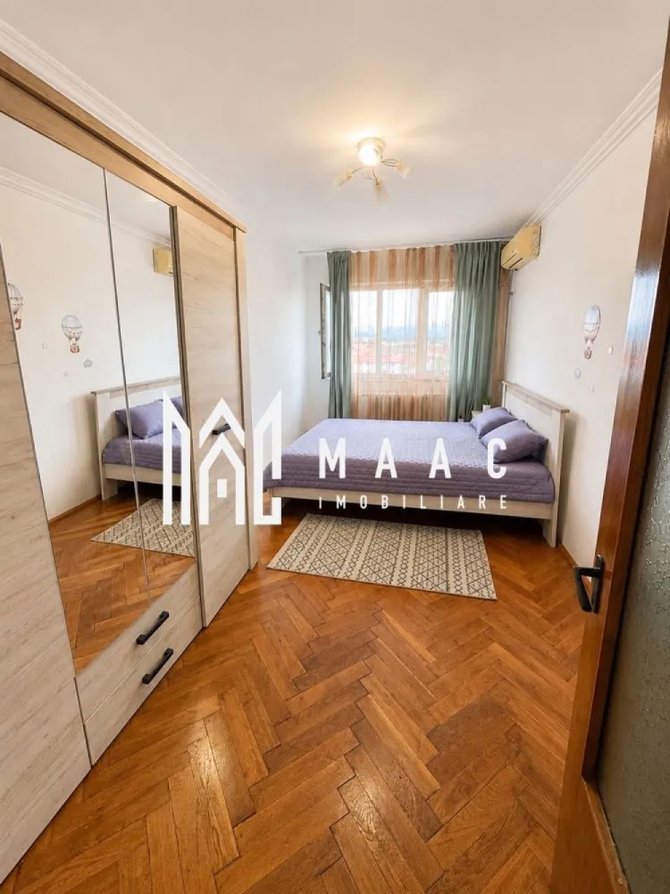 Apartament 3 camere | 2 Balcoane | 98 MPU | Mihai Viteazul - MAAC Imobiliare vă propune spre închiriere un apartament spațios cu 3 camere decomandate, situat într-un bloc turn dotat cu lift nou, într-o zonă cu acces rapid către centrul orașului și principalele puncte de interes din Sibiu.

Cu o suprafață utilă de 98 mp, locuința oferă spații generoase și o compartimentare practică, fiind ideală pentru o familie, un cuplu sau persoane care își doresc mai mult confort.

Detalii proprietate
Suprafață utilă: 98 mp
Compartimentare decomandată
Bloc cu lift nou
2 balcoane
Spații de depozitare
Disponibil începând cu 1 august
Compartimentare
Living spațios
2 dormitoare
Bucătărie
Baie
Hol generos
2 balcoane
Spații de depozitare
Avantaje
Suprafață generoasă
Compartimentare eficientă
Lift nou
Două balcoane
Multiple spații de depozitare
Luminozitate naturală
Potrivit pentru locuire pe termen lung
Avantaje locație
Stație de autobuz în imediata apropiere
Farmacii și magazine la câțiva pași
Magazin non-stop în zonă
Aproape de magazine de cartier și supermarketuri
Acces rapid către centrul orașului
Aproape de facultățile din Sibiu
Conexiune facilă către principalele zone comerciale și administrative ale orașului

Pentru mai multe detalii precizati telefonic ca ati vazut anuntul cu ID: CP3185721