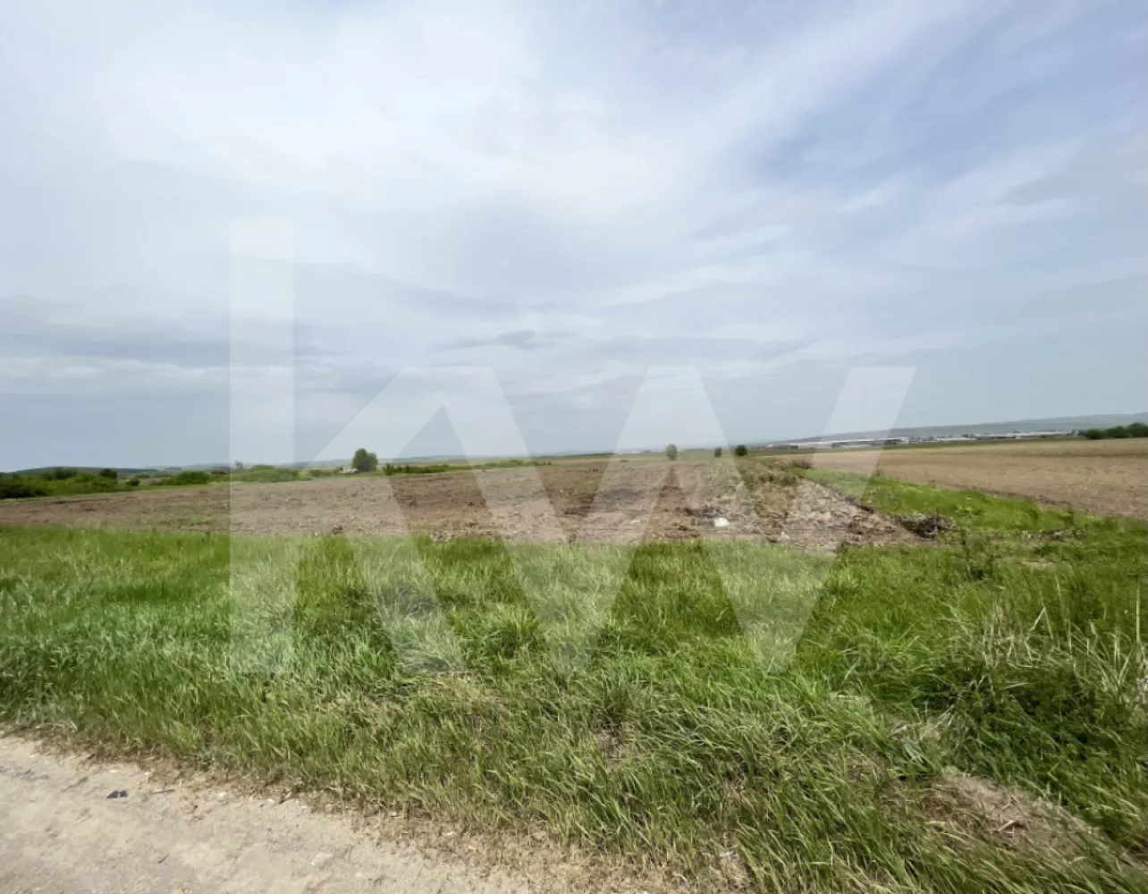 Teren 14.800 mp - PUZ Construcții - Zona Aeroport Sibiu - Teren intravilan de vanzare in Sibiu zona industrial Vest Sibiu, direct la ( DN 1) cu o suprafata de 14800 mp, cu propunere in PUZ aprobat de Regim inaltime 9m, POT 18,5% CUT 0,18, ce rezulta o constructie de 2748mp, impartita in:
- cladire birouri pe parter suprafata de 393mp
- hala in suprafata de 1290mp si regim inaltime de 9h, prevazuta cu rampa
- hala in suprafata de 1090mp si regim inaltime 9h, prevazuta cu rampa
- terenul dispune de 2 fronturi stradale
- 34 locuri de parcare
- acces tir
- utilitati in zona
 Deschidere de 65 m la sosea, in cea mai cautata zona industriala a orasului aflata in continua dezvoltare. Terenul este amplasat intre doua accese la autostrada.
Aceasta proprietate este pretabila pentru constructia: showroom, birouri, hale, depozite fabrici sau orice alte oportunitati de investitie profitabile luand in calcul suprafata mare a acestuia.
Utilitatiile respectiv curentul electric apa canalizarea si gazul se afla la limita proprietatii. 
Accesul la teren se face direct din DN 1, dar mai dispune si de un drum de exploatare pe partea din spate. Zona este una in continua dezvoltare si un mare avantaj il constituie Aeroportul International Sibiu, Autostrada A1 si toata zona industriala de vest, marile corporatii.