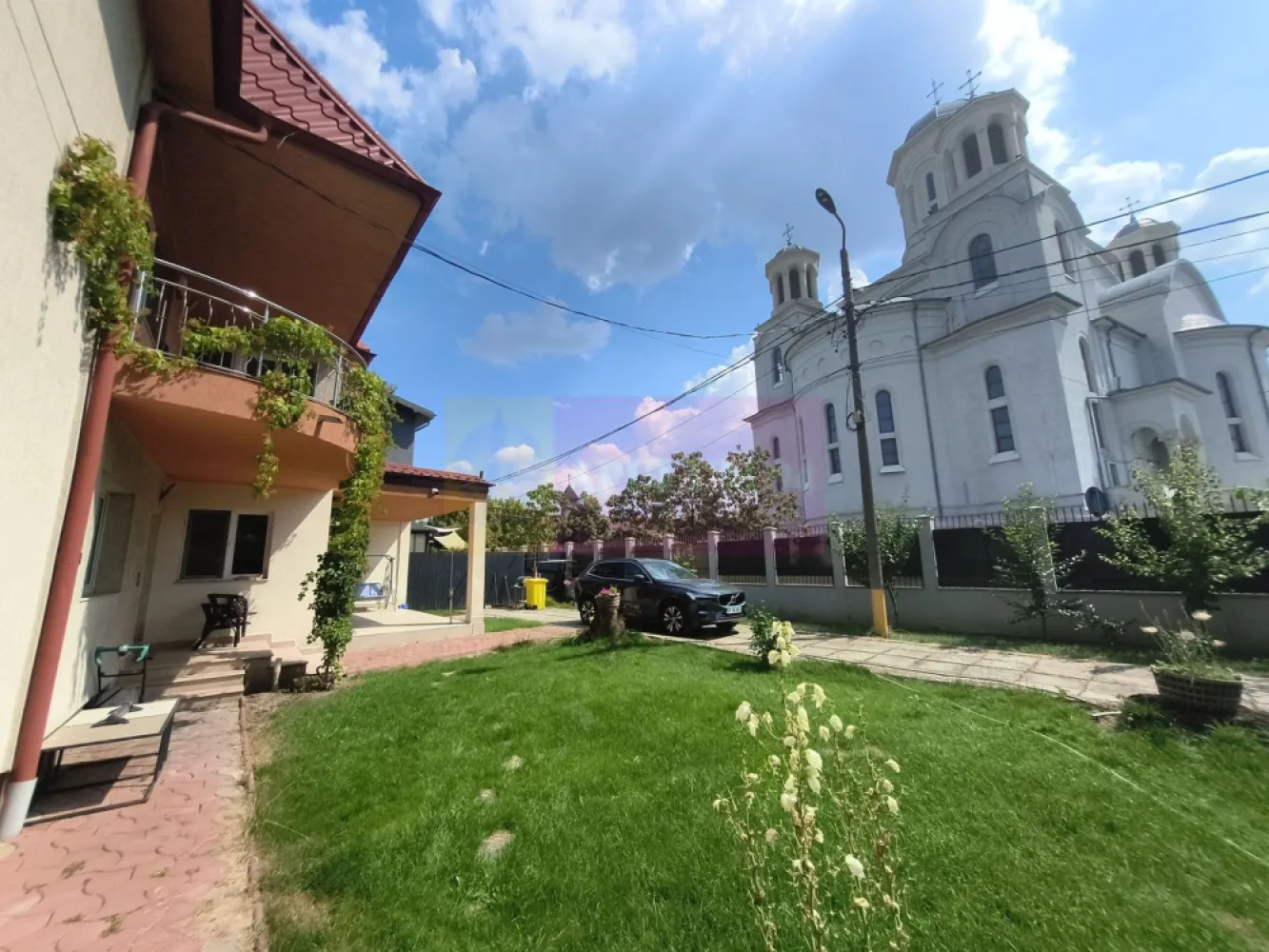 Vila de lângă Catedrala Ortodoxă ,,Sfânta Cuvioasă Parascheva" - Vindem vila de peste drum de Catedrala Ortodoxă Sfânta Cuvioasă Parascheva, cu acces din strada Sfântul Ioan Iacob Hozevitul, strada alăturată Catedralei. Casa se află într-o zonă centrală și extrem de frumoasă din Voluntari, aici ne bucurăm de multe facilități și avem acces la toate utilitățile. Imobilul cuprinde un corp principal de casă dispus pe două nivele plus mansardă, un corp secundar dispus doar pe parter care are însă placă de beton și permite extindere, o anexă acoperită pentru activități diverse și o curte splendidă foarte frumos amenajată. Corpul principal dispus pe parter și etaj oferă posibilitatea de a amenaja după bunul plac o mansardă spațioasă care beneficiază de trei ferestre tip Velux, bine izolată dar nefinisată, între etaj și terasă având placă de beton. Frontul stradal este generos și pe partea dinspre Catedrală avem pomi fructiferi tineri și tufe de trandafiri. Configurația corpului principal este foarte plăcută și extrem de practică, accesul se face fie pe intrarea principală fie direct prin bucătăria imensă și bine luminată. La parter afară de bucătăria tip salon care beneficiază și de o zonă de tip lounge, 2 (două) dormitoare mari și luminoase cu orientare sudică, o baie spațioasă și bine echipată ce beneficiază de fereastră pentru aer proaspăt, un dressing încăpător care deasemenea beneficiază de fereastră și are mai multe zone de depozitare evident plus o cameră tehnică și o cameră pentru menajeră sau pentru oaspeți care stau mai mult timp ce beneficiază de baie proprie cu cabină de duș. La etaj avem alte 4 (patru) dormitoare, o baie mare, o zonă de loisir cu bibliotecă în proximitatea scării de marmură și o cameră pentru depozitare, toate dormitoarele de la etaj au acces la balcoane tip terasă, dormitoarele mai apropiate de scara de marmură au orientare sudică și au acces spre balconul care oferă o priveliște superbă spre Catedrala Sfânta Cuvioasă Parascheva iar cele două dormitoare aflate în capătul holului au acces facil la baia bine echipată de la etaj și beneficiază de un balcon deschis tip terasă de aproximativ 20mp ce oferă o priveliște splendidă spre propria curte. Curtea este foarte ușor de întreținut, avem aspersoare și o diferențiere frumoasă a diferitelor zone. În proximitatea corpului principal de casă avem gazon și jnepenișuri iar în apropiere de zona de parcare avem o minidumbravă cu 5 conifere mature, două magnolii deasemenea mature și un smochin bine aclimatizat plus alte plante. Parcarea este umbrită de o boltă de viță de vie aflată pe rod bineînțeles. Zona de parcare se închide într-un spațiu acoperit aflat în prelungirea corpului secundar, spațiu care beneficiază de curent electric și care poate fi folosit pentru activități de atelier sau ca garaj acoperit. Corpul secundar de casă este gândit ca o zonă de party cu o zonă de bar, un open-space de peste 50mp, două grupuri sanitare, o zonă tehnică și chiar și o bucătărie. O casă superbă pe care vă invit să o vizionați. Daniel Apulum94