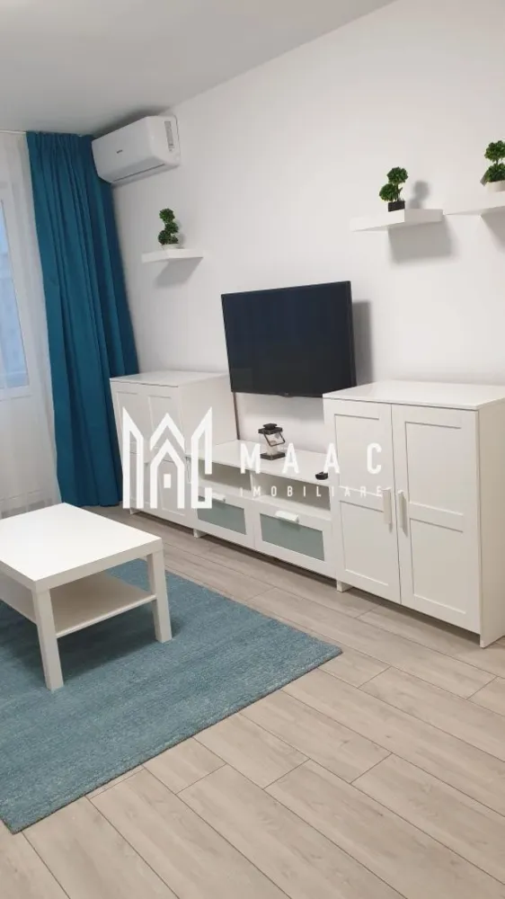 Apartament 2 camere | 52 MPU | Balcon | Lift | Mihai Viteazul - MAAC Imobiliare vă propune spre închiriere un apartament modern, situat pe Bulevardul Mihai Viteazul, într-o zonă liniștită, cu spații verzi și acces rapid către principalele puncte de interes ale orașului Sibiu.

Apartamentul este complet renovat și oferă toate dotările necesare pentru un stil de viață confortabil, fiind pregătit pentru mutare imediată.

Detalii proprietate
Apartament renovat complet
Situat într-un bloc izolat termic
Bloc cu lift și casa scării renovată
Parcare în apropierea imobilului
Zonă cu spații verzi
Compartimentare
Living
Dormitor
Bucătărie
Baie
Hol
Dotări și beneficii
Complet mobilat și utilat
Aer condiționat
TV LCD
Finisaje moderne
Bloc renovat și bine întreținut
Costuri reduse de întreținere
Avantaje locație
Situat pe Bulevardul Mihai Viteazul
Aproape de magazine și supermarketuri
Stații de autobuz în imediata apropiere
Acces rapid către centrul orașului
În apropierea școlilor, grădinițelor și farmaciilor
Zonă liniștită, cu spații verzi
Condiții de închiriere
Disponibil pentru mutare imediată
Se acceptă animale de companie doar de talie mică

Se închiriază pe termen lung. Nu se acceptă fumători și nu se acceptă animale de companie. Cod anunț CP3197439
