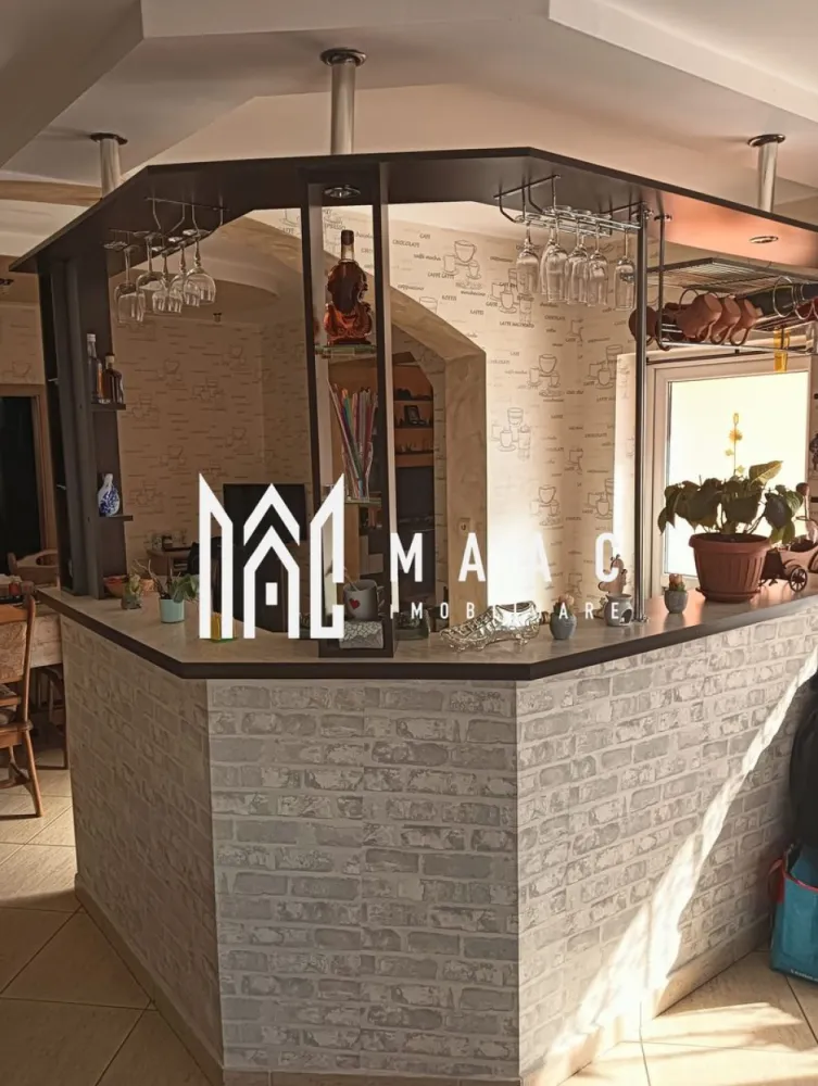 Casa 8 camere I 336 MPU I 1309 MP Teren I Agnita - MAAC Imobiliare va propune spre vanzare o casa amplasată într-o zonă excelentă, ideală pentru locuire sau investiție. Proprietatea oferă un spațiu generos și funcțional, fiind structurată pe demisol, parter și etaj, cu două intrări separate atât în casă, cât și în curte. Suprafața utilă este de 450 mp, iar terenul total măsoară 1309 mp. Demisolul este compartimentat practic, având două camere, un hol de acces, pivniță și spălătorie — perfect pentru spații tehnice, depozitare sau zone hobby. Parterul impresionează prin spațiul deschis și luminos, fiind compus dintr-un living cu bucătărie spațioasă, loc de luat masa, o cameră suplimentară, baie, cămară, hol de acces și o terasă ce oferă un loc ideal pentru relaxare. Casa scărilor include un dressing generos, maximizând eficient spațiul. Etajul cuprinde patru camere, fiecare prevăzută cu balcon propriu, o baie și un hol bine configurat. Spațiul este ideal pentru o familie numeroasă, oferind confort și intimitate. Proprietatea se remarcă prin terenul întins și posibilitățile multiple de amenajare, iar poziționarea în zonă foarte bună îi conferă un avantaj major pentru cei care caută liniște, siguranță și acces facil la punctele de interes. Pentru mai multe detalii si programarea unei vizionari va rugam sa specificati ID: CP2852093 }}